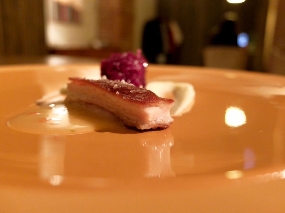 Galleria fotografica






La nostra cena negli scatti di Tanio Liotta. Conosciamo chi produce il pane, è la cooperativa Pausa Cafè, lo impastano i detenuti di una delle due prigioni di Alessandria, quella di San Michele. Ne avevamo parlato qui: Il buon pane dei cattivi. Poi ci sono anche grissini home made e taralli artigianali di Vincenzo Fiore









Bonbon di cinghiale, polvere di barbabietola, ketchup di barbabietola rossa









Buonissimi i Tacos di wafer, guacamole e maionese alla paprika affumicata









Patata pietrificata, maionese di zafferano e i suoi fiori









Finto pomodorino su pane verde all'acciuga









S'inizia il pasto vero e proprio: qui Pescato del Mediterraneo crudo e cotto incontra l'Oriente, ossia gambero rosso di Mazara, ricciola, cipolla rossa di Breme, gel della stessa, peperoncino fresco, riso selvaggio soffiato, latte di cocco, lemon grass, zenzero, acqua di cottura delle cozze. Piatto molto intrigante, spinge su sentori dolci e aromatici/speziati. A parte sono serviti dei calamaretti spillo fritti con paprika affumicata: un po' troppo sale









Uovo bio, carciofo, caviale di trota, Casanova: l'uovo è de La Montagnola, azienda agricola di Riccardo e Gabriele Nicora a Bocco, frazione di Brallo di Pregola (Pv), zona a cavallo tra la bassa valle Staffora e la valle del Trebbia, «da loro mi rifornisco anche di uno splendido zafferano», spiega Sgorbini. È in doppia panatura di pane e panko, poi una fonduta di Casanova (formaggio prodotto dal Caseificio Cavanna sempre in valle Staffora, a pasta molle da latte vaccino intero pastorizzato), un po' dello stesso Casanova a tocchetti, il gambo del carciofo cotto a bassa temperatura e uova di trota. Piatto molto buono, fondente









Deliziosa l'Animella, panna acida al pepe di Timut, daikon e lamponi. L'animella è fritta e poi spolverata di polvere di lamponi, il daikon in infusione di acetosella rossa, poi fondo di cottura di vitello. Perfetto il bilanciamento degli aromi e delle texture: acido/grasso, dolce/piccante, morbido/croccante









Divertente - anche come presentazione - la reinterpretazione di un classico oltrepadano: Ravioli al brasato, cialde di Grana Padano, bieta, jus di vitello









Risotto ai quattro formaggi dell'Oltrepò Pavese. Il riso Riserva San Massimo ha alla base una crema di pere, è mantecato con extravergine e poco burro, e un po' di limone. I formaggi sono liquidi nelle ampolline in fondo, e di altissima qualità, e ognuno richiama una diversa percezione di gusto: stafforella del Caseificio Cavanna per l'acido (è un formaggio vaccino a pasta molle): il Latte & Co di Marco Bernini per l'amaro (erborinato vaccino annegato in salamoia di roquefort e pistacchio di Bronte. Di Bernini abbiamo parlato qui: In viaggio dal casaro-alchimista); il Quadro a pasta fiorita de Il Boscasso (formaggio di capra a latte crudo, stagionato 40 giorni) per il sapido; Grana Padano Dop 20 mesi dell'azienda agrigola Garbelli per l'umami. Da versare a piacere; il dolce, come detto, è già nella crema di pere. Anche in questo caso, piatto molto intrigante









Grissini bolliti Milano (un omaggio ai due maestri), che poi sarebbero Bartolini (i suoi famosi grissini bolliti) e Ribaldone (lo Spaghetto Milano, ne abbiamo parlato qui: uno spaghettone Monograno Felicetti mantecato con un risotto alla milanese stracotto, mantecato con Grana Padano e burro, poi frullato per ottenere una crema di riso allo zafferano). In questo caso Sgorbini unisce le due idee, aggiunge midollo ghiacciato grattugiato e gremolada









Piatto favoloso, quello che vale il viaggio: Diaframma, ostrica, insalatina, arancia. Pulito, essenziale, ricco, equilibrato. Il diaframma è cotto a bassa temperatura a 55°, poi affumicato e finito alla piastra: magnifico. Viene condito con una salsa di ostriche frullate con la loro acqua ed extravergine; a stemperare lo scontro ferroso-iodato arriva la parte vegetale, con le note dolci e acide dell'arancia che si ritrovano anche nel fondo bruno aromatizzato









Come side dish, un'Ostrica con salsa ponzu. Elegantissima









Pollo ficatum, limone, pomelo, cicorie: di nuovo una cottura a bassa temperatura, in questo caso del petto del pollo, mentre la coscetta è panata e fritta. Poi salsa agropiccante di pomelo, insalatina di cicorie, maionese al limone senza uova









Buono anche lo Storione, bernese, cavolfiore, olive. Il pesce è marinato in sale grosso, poi fiammeggiato con salsa di soia, miele, miso e aceto, quindi cavolfiore crudo, polvere di olive nere e verdi, alghe, una bernese classica e agretti






