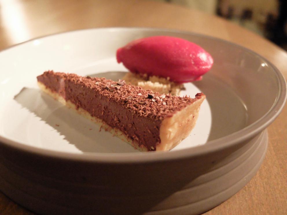 Galleria fotografica






La nostra cena negli scatti di Tanio Liotta. Conosciamo chi produce il pane, è la cooperativa Pausa Cafè, lo impastano i detenuti di una delle due prigioni di Alessandria, quella di San Michele. Ne avevamo parlato qui: Il buon pane dei cattivi. Poi ci sono anche grissini home made e taralli artigianali di Vincenzo Fiore









Bonbon di cinghiale, polvere di barbabietola, ketchup di barbabietola rossa









Buonissimi i Tacos di wafer, guacamole e maionese alla paprika affumicata









Patata pietrificata, maionese di zafferano e i suoi fiori









Finto pomodorino su pane verde all'acciuga









S'inizia il pasto vero e proprio: qui Pescato del Mediterraneo crudo e cotto incontra l'Oriente, ossia gambero rosso di Mazara, ricciola, cipolla rossa di Breme, gel della stessa, peperoncino fresco, riso selvaggio soffiato, latte di cocco, lemon grass, zenzero, acqua di cottura delle cozze. Piatto molto intrigante, spinge su sentori dolci e aromatici/speziati. A parte sono serviti dei calamaretti spillo fritti con paprika affumicata: un po' troppo sale









Uovo bio, carciofo, caviale di trota, Casanova: l'uovo è de La Montagnola, azienda agricola di Riccardo e Gabriele Nicora a Bocco, frazione di Brallo di Pregola (Pv), zona a cavallo tra la bassa valle Staffora e la valle del Trebbia, «da loro mi rifornisco anche di uno splendido zafferano», spiega Sgorbini. È in doppia panatura di pane e panko, poi una fonduta di Casanova (formaggio prodotto dal Caseificio Cavanna sempre in valle Staffora, a pasta molle da latte vaccino intero pastorizzato), un po' dello stesso Casanova a tocchetti, il gambo del carciofo cotto a bassa temperatura e uova di trota. Piatto molto buono, fondente









Deliziosa l'Animella, panna acida al pepe di Timut, daikon e lamponi. L'animella è fritta e poi spolverata di polvere di lamponi, il daikon in infusione di acetosella rossa, poi fondo di cottura di vitello. Perfetto il bilanciamento degli aromi e delle texture: acido/grasso, dolce/piccante, morbido/croccante









Divertente - anche come presentazione - la reinterpretazione di un classico oltrepadano: Ravioli al brasato, cialde di Grana Padano, bieta, jus di vitello









Risotto ai quattro formaggi dell'Oltrepò Pavese. Il riso Riserva San Massimo ha alla base una crema di pere, è mantecato con extravergine e poco burro, e un po' di limone. I formaggi sono liquidi nelle ampolline in fondo, e di altissima qualità, e ognuno richiama una diversa percezione di gusto: stafforella del Caseificio Cavanna per l'acido (è un formaggio vaccino a pasta molle): il Latte & Co di Marco Bernini per l'amaro (erborinato vaccino annegato in salamoia di roquefort e pistacchio di Bronte. Di Bernini abbiamo parlato qui: In viaggio dal casaro-alchimista); il Quadro a pasta fiorita de Il Boscasso (formaggio di capra a latte crudo, stagionato 40 giorni) per il sapido; Grana Padano Dop 20 mesi dell'azienda agrigola Garbelli per l'umami. Da versare a piacere; il dolce, come detto, è già nella crema di pere. Anche in questo caso, piatto molto intrigante









Grissini bolliti Milano (un omaggio ai due maestri), che poi sarebbero Bartolini (i suoi famosi grissini bolliti) e Ribaldone (lo Spaghetto Milano, ne abbiamo parlato qui: uno spaghettone Monograno Felicetti mantecato con un risotto alla milanese stracotto, mantecato con Grana Padano e burro, poi frullato per ottenere una crema di riso allo zafferano). In questo caso Sgorbini unisce le due idee, aggiunge midollo ghiacciato grattugiato e gremolada









Piatto favoloso, quello che vale il viaggio: Diaframma, ostrica, insalatina, arancia. Pulito, essenziale, ricco, equilibrato. Il diaframma è cotto a bassa temperatura a 55°, poi affumicato e finito alla piastra: magnifico. Viene condito con una salsa di ostriche frullate con la loro acqua ed extravergine; a stemperare lo scontro ferroso-iodato arriva la parte vegetale, con le note dolci e acide dell'arancia che si ritrovano anche nel fondo bruno aromatizzato









Come side dish, un'Ostrica con salsa ponzu. Elegantissima









Pollo ficatum, limone, pomelo, cicorie: di nuovo una cottura a bassa temperatura, in questo caso del petto del pollo, mentre la coscetta è panata e fritta. Poi salsa agropiccante di pomelo, insalatina di cicorie, maionese al limone senza uova









Buono anche lo Storione, bernese, cavolfiore, olive. Il pesce è marinato in sale grosso, poi fiammeggiato con salsa di soia, miele, miso e aceto, quindi cavolfiore crudo, polvere di olive nere e verdi, alghe, una bernese classica e agretti









Maialino agropiccante, pastinaca all'anice, cavolo viola fermentato: la carne a bassa temperatura, poi piastrata









Limone e liquirizia: panna cotta, sorbetto di limone, gel di liquirizia, meringa al limone. Buonissimo, fresco, accattivante









Zuppa di Voghera: una interpretazione di un dolce tipico della pasticceria Vellini di Voghera (fatto con pan di Spagna, cioccolato... una sorta di tiramisù, con crema agli agrumi). Qui crumble di caramello salato, crema pasticcera agli agrumi, gel al cardamomo, granita di caffè, panna ghiacciata. Sarebbe solo goloso, se il cardamomo non gli conferisse quella nota in più






