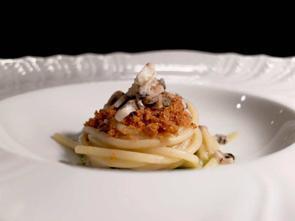 Galleria fotografica






La nostra cena al Dina nelle foto di Tanio Liotta. Il pane pugliese da lievito madre è aromatizzato con acciughe, capperi, olive e scorze di limone. Viene servito con burro alla scorza d'arancia









Un primo brodo, di verdure. «Adoro i brodi, richiamano la casa. Ne propongo uno accogliente all'inizio e uno profondo alla fine». Non chiarificato, con forte nota caramellata









Da dentro al sacchetto: casoncello crudo, ma cotto: lo si è assaggiato anche a Identità Milano 2018









Lo chef lo racconta così: «Avete mai mangiato la pasta ripiena cruda? Io ne ho mangiata una quantità sconsigliabile a chiunque. Quando ero a Modena, all'Osteria Francescana, un giorno ho mangiato due tortellini crudi e ho pensato: mamma mia, ma quanto sono buoni?! Sarebbe davvero bello renderli crudi, ma cotti: percezione palatale del crudo, ma assolutamente cotto. Ci ho lavorato, ci sono riuscito e così è nato il mio Casoncello crudo, ma cotto. Se Massimo Bottura un giorno verrà da Dina, solo per lui, ci sarà un tortellino crudo, ma cotto. Immagino di mandarlo sotto al tavolo facendo cadere una finta farina dall’alto e, come da bambino, se vorrà, potrà rubare il suo tortellino crudo, ma cotto “da sotto al tavolo”. Io rubavo i casoncelli dal sacchetto, quindi da Dina ognuno può giocare con la memoria attraverso questo piatto»









Tutto ci passa attraverso e ci cambia. Lo chef ama i prodotti-filtro, «capesante, cozze, eccetera». Qui crema di cozze, crema di pomodori confit piccante, aria di limone, erbe aromatiche, pane croccante e tartare di fungo. «L'uomo è un filtro (come la cozza): tutto ciò che incontra lascia in lui dei segni. L'uomo è anche un parassita (come il fungo): si lega a ciò che lo attrae». Il piatto è servito in un "bidoncino del pattume"









Agretti come spaghetti, piatto buonissimo. Lo chef fa annusare un'estrazione di radice di agretti (la terra) e una di tarassaco (un campo dopo la pioggia). Quindi si mangia il piatto, che prevede anche crema di noci, lime, timo, ravanello, prezzemolo e olio al fieno greco. Gli agretti sono cotti nella loro estrazione









Carciofo o ostrica. Piatto ispirato a Pippo Feroci dell'Osteria Francescana, «lui è come un'ostrica o un carciofo, ci vuole un po' di tempo per arrivare al cuore». Il carciofo cotto alla romana è condito con maionese d'ostrica e foie gras









Non mi era proprio mai piaciuta, «perché a me la pasta pomodoro e basilico non piaceva». Lo chef mette sottovuoto degli spaghetti con dell'acqua di pomodoro; gli acidi di quest'ultima estraggono gli amidi, formando una sorta di gel. La parte di pasta rimasta, sfibrata, viene frullata col basilico e un poco di questo gel, quindi è usata per condire gli spaghetti veri e propri e per ottenere la pallina di gelato. La cialda è invece una meringa ottenuta dal solito gel






