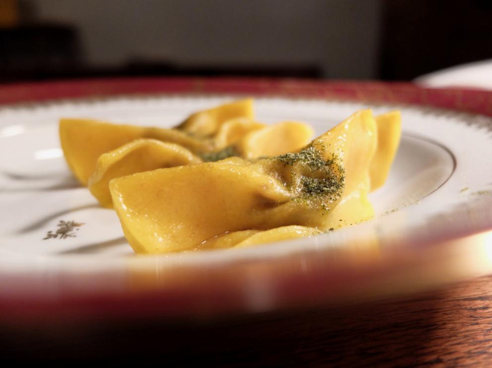 Galleria fotografica






La nostra cena al Dina nelle foto di Tanio Liotta. Il pane pugliese da lievito madre è aromatizzato con acciughe, capperi, olive e scorze di limone. Viene servito con burro alla scorza d'arancia









Un primo brodo, di verdure. «Adoro i brodi, richiamano la casa. Ne propongo uno accogliente all'inizio e uno profondo alla fine». Non chiarificato, con forte nota caramellata









Da dentro al sacchetto: casoncello crudo, ma cotto: lo si è assaggiato anche a Identità Milano 2018









Lo chef lo racconta così: «Avete mai mangiato la pasta ripiena cruda? Io ne ho mangiata una quantità sconsigliabile a chiunque. Quando ero a Modena, all'Osteria Francescana, un giorno ho mangiato due tortellini crudi e ho pensato: mamma mia, ma quanto sono buoni?! Sarebbe davvero bello renderli crudi, ma cotti: percezione palatale del crudo, ma assolutamente cotto. Ci ho lavorato, ci sono riuscito e così è nato il mio Casoncello crudo, ma cotto. Se Massimo Bottura un giorno verrà da Dina, solo per lui, ci sarà un tortellino crudo, ma cotto. Immagino di mandarlo sotto al tavolo facendo cadere una finta farina dall’alto e, come da bambino, se vorrà, potrà rubare il suo tortellino crudo, ma cotto “da sotto al tavolo”. Io rubavo i casoncelli dal sacchetto, quindi da Dina ognuno può giocare con la memoria attraverso questo piatto»









Tutto ci passa attraverso e ci cambia. Lo chef ama i prodotti-filtro, «capesante, cozze, eccetera». Qui crema di cozze, crema di pomodori confit piccante, aria di limone, erbe aromatiche, pane croccante e tartare di fungo. «L'uomo è un filtro (come la cozza): tutto ciò che incontra lascia in lui dei segni. L'uomo è anche un parassita (come il fungo): si lega a ciò che lo attrae». Il piatto è servito in un "bidoncino del pattume"









Agretti come spaghetti, piatto buonissimo. Lo chef fa annusare un'estrazione di radice di agretti (la terra) e una di tarassaco (un campo dopo la pioggia). Quindi si mangia il piatto, che prevede anche crema di noci, lime, timo, ravanello, prezzemolo e olio al fieno greco. Gli agretti sono cotti nella loro estrazione









Carciofo o ostrica. Piatto ispirato a Pippo Feroci dell'Osteria Francescana, «lui è come un'ostrica o un carciofo, ci vuole un po' di tempo per arrivare al cuore». Il carciofo cotto alla romana è condito con maionese d'ostrica e foie gras









Non mi era proprio mai piaciuta, «perché a me la pasta pomodoro e basilico non piaceva». Lo chef mette sottovuoto degli spaghetti con dell'acqua di pomodoro; gli acidi di quest'ultima estraggono gli amidi, formando una sorta di gel. La parte di pasta rimasta, sfibrata, viene frullata col basilico e un poco di questo gel, quindi è usata per condire gli spaghetti veri e propri e per ottenere la pallina di gelato. La cialda è invece una meringa ottenuta dal solito gel









Aglio, Olio e 58, «pasta golosa» inventata per la Franceschetta 58 di Modena (da qui il nome), ma là mai servita. Prevede crema di prezzemolo, patata, scalogno, aglio, timo, peperoncino e ostriche






