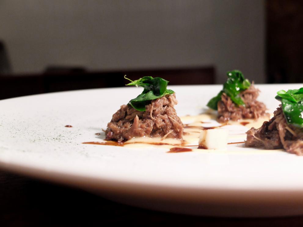 Galleria fotografica






La nostra cena al Dina nelle foto di Tanio Liotta. Il pane pugliese da lievito madre è aromatizzato con acciughe, capperi, olive e scorze di limone. Viene servito con burro alla scorza d'arancia









Un primo brodo, di verdure. «Adoro i brodi, richiamano la casa. Ne propongo uno accogliente all'inizio e uno profondo alla fine». Non chiarificato, con forte nota caramellata









Da dentro al sacchetto: casoncello crudo, ma cotto: lo si è assaggiato anche a Identità Milano 2018









Lo chef lo racconta così: «Avete mai mangiato la pasta ripiena cruda? Io ne ho mangiata una quantità sconsigliabile a chiunque. Quando ero a Modena, all'Osteria Francescana, un giorno ho mangiato due tortellini crudi e ho pensato: mamma mia, ma quanto sono buoni?! Sarebbe davvero bello renderli crudi, ma cotti: percezione palatale del crudo, ma assolutamente cotto. Ci ho lavorato, ci sono riuscito e così è nato il mio Casoncello crudo, ma cotto. Se Massimo Bottura un giorno verrà da Dina, solo per lui, ci sarà un tortellino crudo, ma cotto. Immagino di mandarlo sotto al tavolo facendo cadere una finta farina dall’alto e, come da bambino, se vorrà, potrà rubare il suo tortellino crudo, ma cotto “da sotto al tavolo”. Io rubavo i casoncelli dal sacchetto, quindi da Dina ognuno può giocare con la memoria attraverso questo piatto»









Tutto ci passa attraverso e ci cambia. Lo chef ama i prodotti-filtro, «capesante, cozze, eccetera». Qui crema di cozze, crema di pomodori confit piccante, aria di limone, erbe aromatiche, pane croccante e tartare di fungo. «L'uomo è un filtro (come la cozza): tutto ciò che incontra lascia in lui dei segni. L'uomo è anche un parassita (come il fungo): si lega a ciò che lo attrae». Il piatto è servito in un "bidoncino del pattume"









Agretti come spaghetti, piatto buonissimo. Lo chef fa annusare un'estrazione di radice di agretti (la terra) e una di tarassaco (un campo dopo la pioggia). Quindi si mangia il piatto, che prevede anche crema di noci, lime, timo, ravanello, prezzemolo e olio al fieno greco. Gli agretti sono cotti nella loro estrazione









Carciofo o ostrica. Piatto ispirato a Pippo Feroci dell'Osteria Francescana, «lui è come un'ostrica o un carciofo, ci vuole un po' di tempo per arrivare al cuore». Il carciofo cotto alla romana è condito con maionese d'ostrica e foie gras









Non mi era proprio mai piaciuta, «perché a me la pasta pomodoro e basilico non piaceva». Lo chef mette sottovuoto degli spaghetti con dell'acqua di pomodoro; gli acidi di quest'ultima estraggono gli amidi, formando una sorta di gel. La parte di pasta rimasta, sfibrata, viene frullata col basilico e un poco di questo gel, quindi è usata per condire gli spaghetti veri e propri e per ottenere la pallina di gelato. La cialda è invece una meringa ottenuta dal solito gel









Aglio, Olio e 58, «pasta golosa» inventata per la Franceschetta 58 di Modena (da qui il nome), ma là mai servita. Prevede crema di prezzemolo, patata, scalogno, aglio, timo, peperoncino e ostriche









Ne mangerei un bidet!, il copyright del nome è di Davide Di Fabio, sous di Bottura. Questa volta i casoncelli sono proprio cotti, conditi poi con crema di Grana Padano 43 mesi riserva della Latteria Sant'Angelo di Campitello (Mn)









Ma quante ne sanno! Bottoni ripieni di polpo alla luciana e beurre blanc






