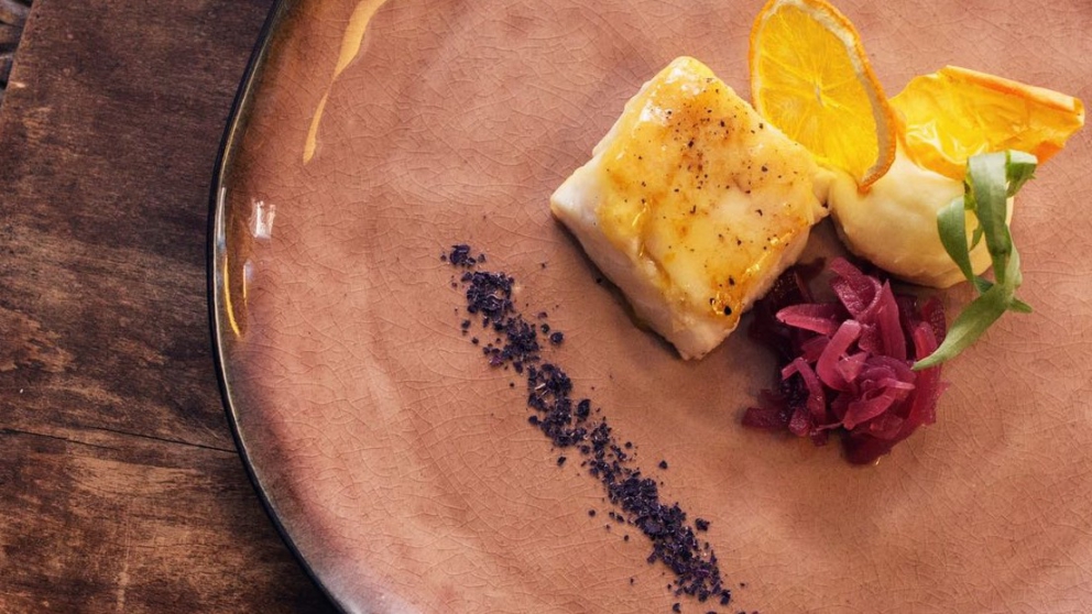 Galleria fotografica






Di grande complessità il Crudo di gambero rosso con stracciatella di burrata al pepe nero e centrifuga di pomodoro datterino al basilico, caviale di storione e polpa di ricci, sferzante, tonico, di mare in tempesta e di terra feconda. Da non perdere per alternanza di tendenze dolci, acidità eterogenee, speziatura e sapidità









La Vitellina a punta di coltello con fonduta di formaggi cremosi e bacche di ginepro dell’Etna affumicata agli aghi di pino investe tre sensi: per la vista è un’immagine evocativa della Muntagna, col rosso della carne al centro a simboleggiare la lava e il bianco della fonduta a rappresentare la neve; per l’olfatto è inebriante il fumo di pino che si diffonde nell’aria quando si solleva la cloche; per il palato è la gioia di un piatto intenso e polposo, bilanciato nella cremosità e nelle acidità silvestri e impreziosito da un delicata affumicatura al ricordo di bosco









Ancora la Vitellina a punta di coltello con fonduta di formaggi cremosi e bacche di ginepro dell’Etna affumicata agli aghi di pino









Rigogliosa celebrazione del mare sono le Linguine all’aglio, olio e peperoncino con tagliatelle di calamaro, gambero rosso, bottarga di tonno, polpa di ricci e crumble di crostacei (nella foto), mentre il gusto ricco delle carni grasse si è esaltato nei Paccheri artigianali mantecati con fonduta al primo sale, petto d’anatra affumicato in casa e cremoso al foie gras









Più coinvolgente la preparazione risottata della Zuppetta calda di crostacei con spaghettino artigianale spezzato: non lasciano indifferenti un notevole scheletro acido, le dolci nuance amidate in armonica lotta con le piccole scie amarognole e speziate e le intriganti sensazioni iodate






