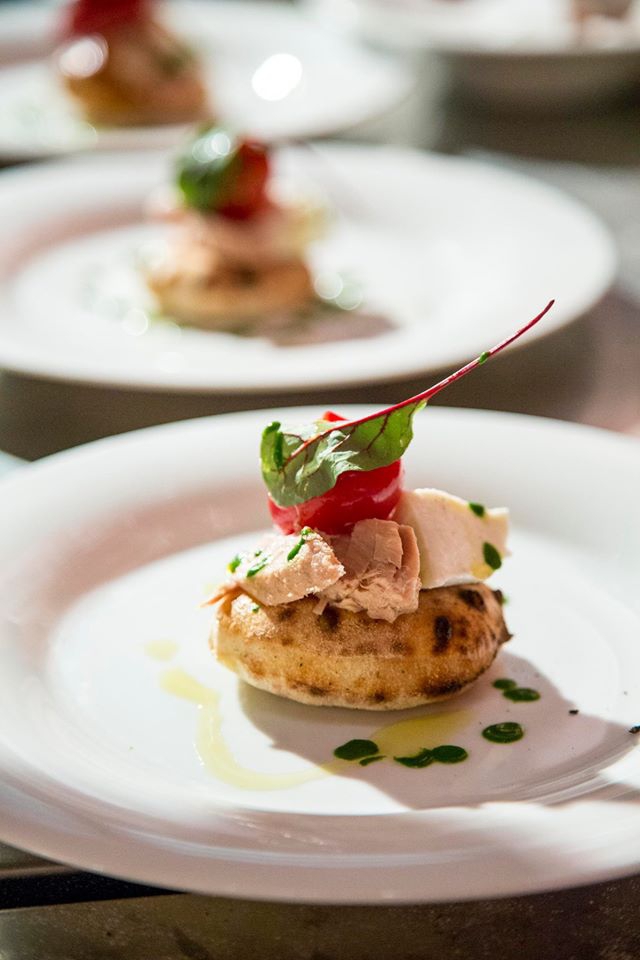 Galleria fotografica






Patrick Ricci, Pomodoro & Basilico, San Mauro Torinese (Torino)

Emozioni - Foie gras con criollo 100%, mostarda di fichi e mousse al caffè. Sottotitolo, l'amore in un morso. Resta in bocca un gusto finale di amaro e dolce, è un po' la sensazione che si prova quando si vive un amore, ma nei momenti un po' tristi, dopo una lite o quando non è corrisposto – foto Luca Appiotti









Simone Lombardi, Dry, Milano

Pizza anguilla al cartoccio, cime di rapa e provola affumicata - Un piatto dalla prevalente nota affumicata data dalla cottura dell’anguilla nel forno a legna. Le cime di rapa ne risaltano: sapidità, grassezza e tendenza amarognola









Leonardo Giannico, Taverna Gourmet, Milano

Pizza polipo e cime di rapa, impasto al nero di seppia – Con vellutata di broccoli calabresi cime di rapa e polipo alla plancia, il tutto accompagnato da un bicchierino di acqua di polipo, lime e pepe nero, per sciacquare la bocca e accompagnare la pizza









Antonio Pappalardo, La Cascina dei Sapori, Rezzato (Brescia)

Pizza da degustazione con tagliatelle di seppia, caco, noce macadamia e frutto della passione - L'abbiamo proposta in anteprima per la serata di beneficienza che abbiamo organizzato a favore della fondazione PInAC ed è piaciuta molto. L'ho creata insieme al mio secondo Matteo Attianese, perché abbiamo visto che in precedenza abbiamo proposto la seppia in alcune pizze ma sempre con poco successo. Quindi cambiando forma alla seppia (prima cotta sottovuoto e poi tagliata con l'affettatrice a mó di tagliatella) ho notato che è stata molto apprezzata









Denis Lovatel, Da Ezio, Alano di Piave (Belluno)

In-fusioni - La pizza inaugura un progetto al quale tengo molto, prevede la creazione di 12 pizze d'autore ideate insieme ad altrettanti importanti chef. Ne proporremo una al mese qui Da Ezio. Questo mese partiamo con una pizza creata insieme a Francesco Brutto di Undicesimo Vineria, premiato di recente come Miglior Chef Emergente del Nordest. Insieme abbiamo pensato una pizza bianca con fiordilatte, topinambur al forno, chips di cavolo nero, succo di cavolo nero, noci e infuso di Pu'er, un particolare tè post-fermentato cinese della regione della Yunnan, che più invecchia e più migliora. Sulla pizza usiamo un Pu'er del 1998 con sentori di noce, cantina, terra e corteccia. In generale è una pizza che gioca sull'armonia e non sui contrasti, i gusti si richiamano a vicenda









Alberto Morello, Gigi Pipa, Este (Padova)

Gennaio nell'orto - La verdura è ovviamente di nostra produzione (broccolo verde, finocchio con aneto, cipolla caramellata, spuma di spinaci e parmigiano, chips di broccolo fiolaro)









Ruggero Ravagnan, Grigoris, Mestre (Venezia)

Cavolo che sarda! - Fiordilatte, cavolo nero, sarda al forno, peperoncino fresco, pane croccante di Petra9, finocchietto









Simone Padoan, I Tigli, San Bonifacio (Verona)

Pizza raperonzoli e pasta di salame - Perché per me è la perfetta trasposizione di ricordi di infanzia in un piatto moderno, capace di attualizzare sapori tradizionali tipici di questo periodo









Renato Bosco, Saporè, San Martino Buon Albergo (Verona)

Aria Affumicata - Aria di pane cotta al vapore con renga affumicata e con crema calda di broccoletto di Custoza. Tradizioni e usanze della cucina veronese vogliono essere riportate in chiave attuale presentando un piatto che si troverà a Saporè nel periodo quaresimale. In molti paesi del Veronese si festeggia la renga (pesce povero) in concomitanza con il mercoledì delle ceneri. Sacro e profano si mescolano









Matto Aloe, Berberè, Bologna (anche Castelmaggiore e Firenze)

Pizza 'nduja di Spilinga, pomodoro, caciocavallo. Una pizza che ha preso posto nei menu di tutte le stagioni in Berberè. Un'evergreen caldo, deciso e accogliente: una pizza del sud









Massimo Gatti, I Due Gatti, Borgo Val di Taro (Parma)

Pizza Don Camillo. E' una delle pizze che comporrà il menu della nuova pizzeria al taglio Pizza di Parma, in posizione centralissima a Parma (apertura entro marzo) che proporremo lungo l'anno con cadenza mensile, per giocare anche con prodotti fuori del nostro territorio in maniera accattivante. E' ispirata alle scorribande e ai luoghi del personaggio di Guareschi: spalla cotta di San Secondo, la crema di Parmigiano-Reggiano (tratto d'unione tra le due province) e le cipolline Borettane (Boretto è un paese nei pressi di Brescello, dove venne sviluppata la storia di Don Camillo) cotte nella Fortana, vino tipico della Bassa Parmense e Reggiana 









Gabriele Bonci, Pizzarium, Roma

Pizza carbonara di carciofi. Una focaccia di cipolle dolci, con sopra una strapazzata di uovo, guanciale e pecorino. Rifinita con qualche carciofo, alla giudia e alla romana. L'ho dedicata a tutte quelle persone che ogni giorno vengono da tutto il mondo per assaggiare la mia pizza. Un boccone di romanità all'ennesima potenza









Stefano Callegari, Sforno, Roma

Bruschetta culo e camicia. Fetta di pane tostato con un velo di burro Occelli, uovo Parisi in camicia e una fetta di culatello Spigaroli sopra. La presenterò da Sbanco, il mio nuovo locale, apertura marzo 2016









Franco Pepe, Pepe in Grani, Caiazzo (Caserta)

Pizza Bucolica. L'ispirazione nasce da un'antica ricetta campana. Alla zucca ed ai fagioli si uniscono il sapore deciso della scamorza affumicata e la nota croccante del radicchio









Ciro Salvo, 50 Kalò, Napoli

50 Kalò (Margherita con scarole). Ingredienti: pomodorini datterini freschi, scarole cotte a vapore, fior di latte di Agerola, olive nere taggiasche, capperi di Salina azienda agrobiologica Salvatore D'Amico, olio extra vergine d'oliva Dop colline salernitane









Enzo Coccia, La Notizia 94, Napoli

Pizza Guardia Costiera. E' una pizza nata in nome della solidarietà per gli uomini e donne della guardia costiera che ogni anno salvano migliaia di vite (profughi). Include mozzarella di bufala, tonno affumicato tagliato sottile, erba cipollina, olio aromatizzao al limone, origano e basilico. Abbinamento consigliato: champagne Jacquesson 738









Gino Sorbillo, Sorbillo, Napoli e Milano

La pizza dell'Alleanza Slow Food. L'incontro di 3 differenti Presidi Slow Food della Campania sulla classica pizza della tradizione napoletana: Pomodoro San Marzano Dop, Salciccia Rossa di Castelpoto e Cacioricotta di Capra Cilentana. Impasto di farina biologica integrale e biologica tipo 0, fiordilatte de Il Casolare di Alvignano; extravergine biologico di Terre Francescane. Cottura a legna









Francesco e Salvatore Salvo, Salvo Pizzaioli, San Giorgio a Cremano (Napoli)

Pizza torzelle e salsiccia affumicata. orzelle del Vesuvio con la salsiccia affumicata a legno di quercia e castagno di nero casertano poggiato su una base bianca di "latte cotto di bufala". E una pizza stagionale,e la ormai rarità dell'ortaggio permettono di proporre questa pizza per un breve periodo da dicembre alla metà di gennaio. Una pizza proposta per il secondo anno ma già un nostro must






