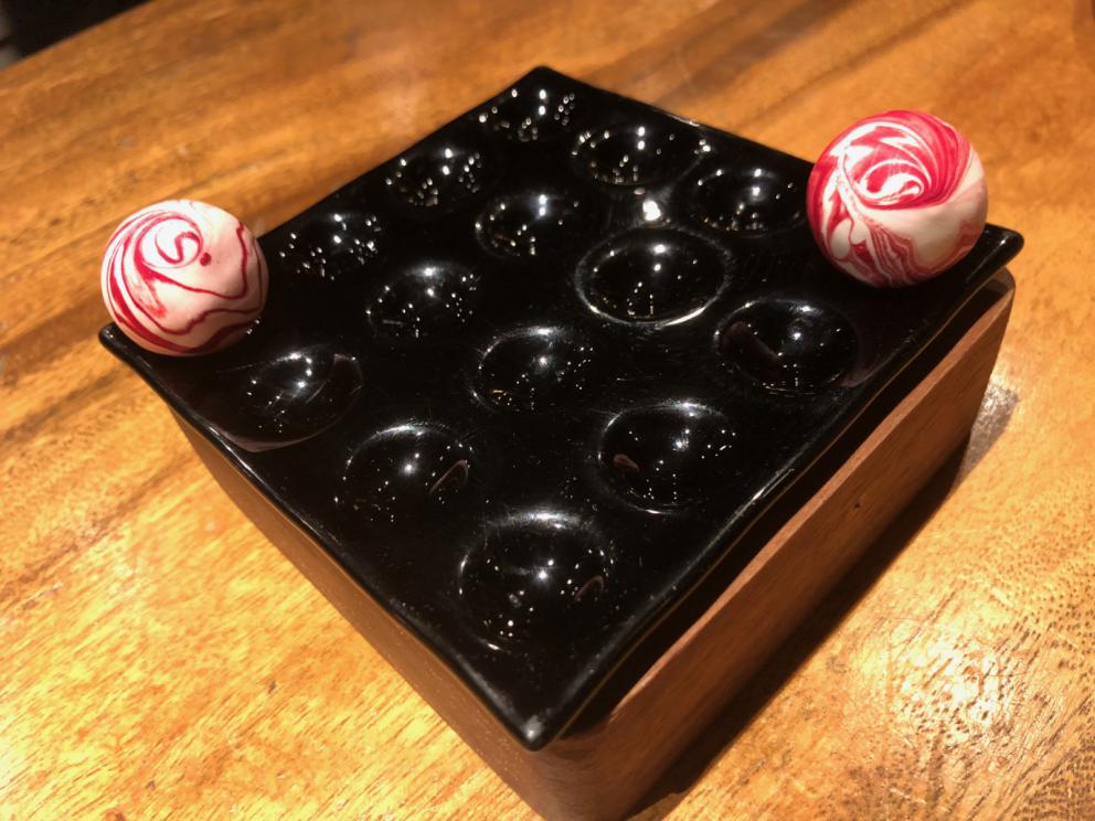 Photogallery






The sign appearing on Soi Langsuan in Bangkok, the little road where you can find restaurant Gaggan and, in front of it, the new-born Gaa, same ownership









The entrance to the restaurant, which recently got the second Michelin star. It’s open only in the evening. There are 65 people here who serve 100 clients daily, divided into two shifts (photo from themalaymailonline.com)









Gaggan’s famous emoji menu: "We first create the dish, then we sum it up with an emoji", he points out (photo from Andershusa/Instagram)









1 
Pink elderflower and watermelon
The tasting menu starts with the notes of the Foo Fighters. The entire first part of the menu is to be eaten with your hands: "This is how it works in India", he explains. First dish: a pearl among elderberry flowers and watermelon in an edible oyster shell. A debut to rinse the palate









2
Yogurt Explosion
Gaggan’s most famous dish. It’s the result of his early internship at elBulli in Roses, Catalonia. "If Ferran Adrià has had Spanish people accept a spherified olives", he says, "why shouldn’t I do the same with an emblem of India?". The spherified yogurt is made with low fat yogurt dipped in a sodium alginate









3
Lick it up. Mushroom peas
With "Lick it up", a hit from the Eighties by Kiss playing in the background, they serve this dish which you must hold with both hands and lick. The sauces, from bottom to top, in "licking order ": tomato, dehydrated mushrooms and mashed green chickpeas. On top, shaved truffle.  "Music, words, food. This is how we represent lightness"









Gaggan holds a cone









4
Tom Yum Kung
This is his version of Tom Yam (or Yum), a popular Thai soup. It’s a cold purée of tom yam served in crispy rice paper with a head of scampi to add flavour. It’s a sort of prawn cocktail in the shape of a cone









5
Goat brain, flower power
A cracker of goat brain ("to us Indians, it’s like foie gras", beams Gaggan) and rice flour. It is served to women first, playing with the similar sounds of flour and flower









6
Eggplant cookie
A cookie of aubergine, a sandwich the size of a coin, held together thanks to some onion chutney. "Out of 20, in Asia ingredients are usually worth 5, technique 15. With this dish I wanted to go in the opposite direction, return to Western minimalism with a universal emblem, that is to say aubergines. It’s a recent dish, which portraits the restaurant as it is now"






