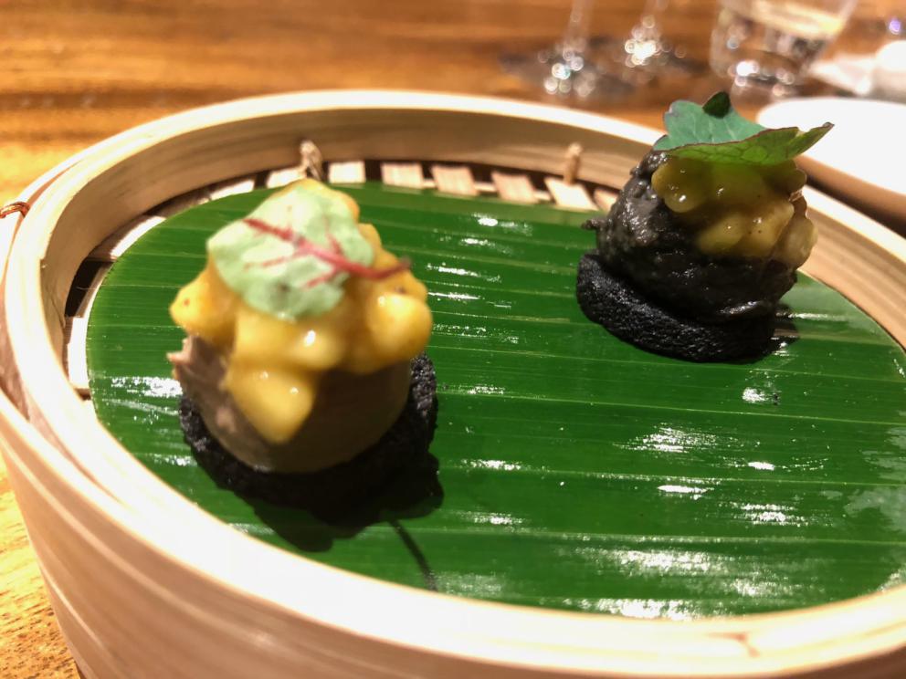 Photogallery






The sign appearing on Soi Langsuan in Bangkok, the little road where you can find restaurant Gaggan and, in front of it, the new-born Gaa, same ownership









The entrance to the restaurant, which recently got the second Michelin star. It’s open only in the evening. There are 65 people here who serve 100 clients daily, divided into two shifts (photo from themalaymailonline.com)









Gaggan’s famous emoji menu: "We first create the dish, then we sum it up with an emoji", he points out (photo from Andershusa/Instagram)









1 
Pink elderflower and watermelon
The tasting menu starts with the notes of the Foo Fighters. The entire first part of the menu is to be eaten with your hands: "This is how it works in India", he explains. First dish: a pearl among elderberry flowers and watermelon in an edible oyster shell. A debut to rinse the palate









2
Yogurt Explosion
Gaggan’s most famous dish. It’s the result of his early internship at elBulli in Roses, Catalonia. "If Ferran Adrià has had Spanish people accept a spherified olives", he says, "why shouldn’t I do the same with an emblem of India?". The spherified yogurt is made with low fat yogurt dipped in a sodium alginate









3
Lick it up. Mushroom peas
With "Lick it up", a hit from the Eighties by Kiss playing in the background, they serve this dish which you must hold with both hands and lick. The sauces, from bottom to top, in "licking order ": tomato, dehydrated mushrooms and mashed green chickpeas. On top, shaved truffle.  "Music, words, food. This is how we represent lightness"









Gaggan holds a cone









4
Tom Yum Kung
This is his version of Tom Yam (or Yum), a popular Thai soup. It’s a cold purée of tom yam served in crispy rice paper with a head of scampi to add flavour. It’s a sort of prawn cocktail in the shape of a cone









5
Goat brain, flower power
A cracker of goat brain ("to us Indians, it’s like foie gras", beams Gaggan) and rice flour. It is served to women first, playing with the similar sounds of flour and flower









6
Eggplant cookie
A cookie of aubergine, a sandwich the size of a coin, held together thanks to some onion chutney. "Out of 20, in Asia ingredients are usually worth 5, technique 15. With this dish I wanted to go in the opposite direction, return to Western minimalism with a universal emblem, that is to say aubergines. It’s a recent dish, which portraits the restaurant as it is now"









7
Chilly bon bon
Chilli pepper spheres. "Chocolates" filled with cumin, chilli pepper, ginger, and other spices. "In India there are four degrees of spiciness: hot, hotter, very hot and hell". The bon bon was mildly hot









8
Idly Sambar
Idly Sambar is a Tamil recipe, from the south of India: vegetable stew, tamarind and varying spices. "The world can be divided into two: those who eat rice, and those who eat bread. In this case, the base is bread made of fermented rice"






