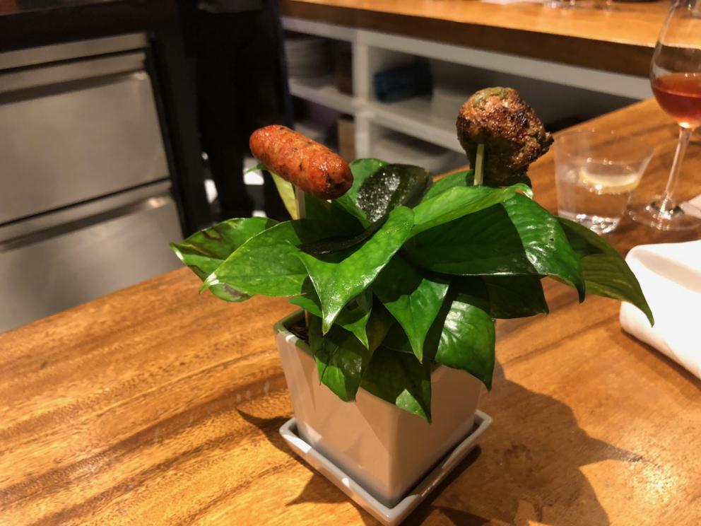 Photogallery






The sign appearing on Soi Langsuan in Bangkok, the little road where you can find restaurant Gaggan and, in front of it, the new-born Gaa, same ownership









The entrance to the restaurant, which recently got the second Michelin star. It’s open only in the evening. There are 65 people here who serve 100 clients daily, divided into two shifts (photo from themalaymailonline.com)









Gaggan’s famous emoji menu: "We first create the dish, then we sum it up with an emoji", he points out (photo from Andershusa/Instagram)









1 
Pink elderflower and watermelon
The tasting menu starts with the notes of the Foo Fighters. The entire first part of the menu is to be eaten with your hands: "This is how it works in India", he explains. First dish: a pearl among elderberry flowers and watermelon in an edible oyster shell. A debut to rinse the palate









2
Yogurt Explosion
Gaggan’s most famous dish. It’s the result of his early internship at elBulli in Roses, Catalonia. "If Ferran Adrià has had Spanish people accept a spherified olives", he says, "why shouldn’t I do the same with an emblem of India?". The spherified yogurt is made with low fat yogurt dipped in a sodium alginate









3
Lick it up. Mushroom peas
With "Lick it up", a hit from the Eighties by Kiss playing in the background, they serve this dish which you must hold with both hands and lick. The sauces, from bottom to top, in "licking order ": tomato, dehydrated mushrooms and mashed green chickpeas. On top, shaved truffle.  "Music, words, food. This is how we represent lightness"









Gaggan holds a cone









4
Tom Yum Kung
This is his version of Tom Yam (or Yum), a popular Thai soup. It’s a cold purée of tom yam served in crispy rice paper with a head of scampi to add flavour. It’s a sort of prawn cocktail in the shape of a cone









5
Goat brain, flower power
A cracker of goat brain ("to us Indians, it’s like foie gras", beams Gaggan) and rice flour. It is served to women first, playing with the similar sounds of flour and flower









6
Eggplant cookie
A cookie of aubergine, a sandwich the size of a coin, held together thanks to some onion chutney. "Out of 20, in Asia ingredients are usually worth 5, technique 15. With this dish I wanted to go in the opposite direction, return to Western minimalism with a universal emblem, that is to say aubergines. It’s a recent dish, which portraits the restaurant as it is now"









7
Chilly bon bon
Chilli pepper spheres. "Chocolates" filled with cumin, chilli pepper, ginger, and other spices. "In India there are four degrees of spiciness: hot, hotter, very hot and hell". The bon bon was mildly hot









8
Idly Sambar
Idly Sambar is a Tamil recipe, from the south of India: vegetable stew, tamarind and varying spices. "The world can be divided into two: those who eat rice, and those who eat bread. In this case, the base is bread made of fermented rice"









9
Banana chicken liver
"My daughter is one year and a half old. She’s difficult when it comes to eating. Give this combination to your children and they’ll be happy"









10
Fish Granola
Granola with fried seabass, walnuts and cheese cream









11
Gin tonic cucumber uni
Sea urchin cones, temaki, key lime and Indian tonic water. "This dish is the result of my trips to Japan: I went there 74 times only in the last couple of years. It has sea urchins from Hokkaido, in the north. In India we never eat raw food". The nori seaweed is made with dill









The selection of sea urchins from Hokkaido. "It’s worth its weight in gold", sighs Gaggan









12
Chutoro sushi
This is Gaggan’s homage to Tuna nigiri, an emblem of his future homeland (in 2021 after closing in Bangkok he’ll open a completely different restaurant in Fukuoka, Japan). Chutoro is a medium-fat tuna. In this case it is caramelised, adding a little emulsion of yuzu on top. The interesting part is below: it’s not rice, but a meringue made of all the ingredients used in sushi, that is to say vinegar, rice, sugar. "Sushi is a one way trip. You’ll never return. Nobody told me how to make it. This dish is a new take on a very personal memory"









13
Foie gras yuzu carrot
Carrot tartelette filled with foie gras. There’s no sweat on the hand: before the tasting they spray yuzu on the palm









Recipe number 14, another excursus between Japan and India









The dish is finished at the table









Whisking the mixture









14
Green vegetable matcha
Green apple gazpacho, cucumber and matcha tea. "I first fell in love with Japan thanks to tea. This looks like Japan but tastes of India and represents Gaggan"









15
Pork Vindaloo 
Vindaloo is a recipe from Goa, the Portuguese feud in west India. It’s pork, seasoned with garlic, vinegar and hot chilli pepper. In this case the fried texture is super-crispy, enriched with Japanese mustard which gives value to the Iberian pig marinated in wine and spices









New dishing out at the Chef's Table









16
Scallop uncooked curry
Scallops with green chilli, fried shallot and coconut ice cream. A “fake-curry ". The dish is served with a complaint about the past: "It’s the British who brought curry. It’s not part of our heritage, just like Chicken tikka masala. For me curry is a universal flavour, suitable for everything"









You can enrich the curry with two chilli sauces: the green, sweeter one (make love) or the red hot one (sex). "I come front the country that invented Kamasutra"






