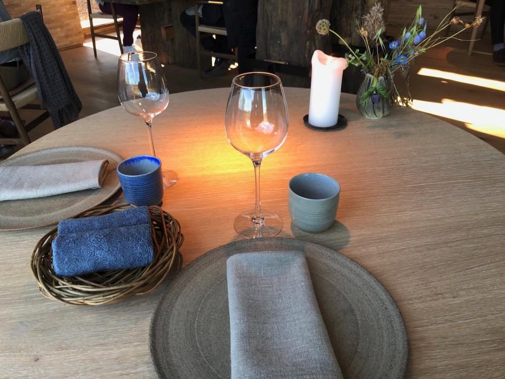 Photogallery






Noma 2.0 is in Christianshavn, the same neighbourhood as the first Noma. They’re 1.5 km apart, a 15 minutes’ walk. This picture shows the distance: to the right, there’s the warehouse of the old location (in Strandgade 93), to the left the smokestacks of Amager Bakke, the futuristic incinerator below which stands the new Noma (in Refshalevej 96)









Weather permitting, you can have a peaceful walk between the previous Noma to today’s Noma 









The new Noma is on an isthmus surrounded by canals. In the future they also want to reclaim some small parts for hydroponic farming









Bucolic scene with incinerator









Bikes left outside Noma. It’s the favourite means of transport among employees and interns









The long path taking you to the restaurant. The fence on the left shows how works are still in progress









On the two sides of the path there are the two new sections of the "Noma village", each with its specialty: grill, hot dishes, snacks, fermentations... In one month’s time, behind the fence we’ll have greenhouses, the test kitchen and the bread making area









To the left, before arriving at the restaurant, the future test kitchen. This will be run by Danish Mette Søberg with Riccardo Canella. "My first challenge?", reveals the latter, for a long time sous chef here, "is to work on the extraction of essential oils" 









The future Test Kitchen









The temporary gangway to the restaurant









Looking from the door to the restaurant, there’s a lake and the smokestacks puffing vapour from the Amager Bakke incinerator. It’s a futuristic project, both in terms of sustainability and architecture. It’s also known as Amager Slope or Copenhill, and its author is starchitect Bjarke Ingels, the same who designed the new Noma. Gradually opened in 2017, it transforms waste into electricity. The goal is to donate electricity to 62500 houses and hot water to 160000. It’s part of an ambitious project to transform Copenhagen into the first city in the world in terms of zero carbon dioxide emissions by 2025. By autumn this year, Amager Slope should open its ski slope, a climbing wall and a hiking track. You’ll be able to slalom on top of the incinerator









The windows from the dining room









Work is still in progress (photo taken on Thursday 22nd February 2018)









Traces of the old building, with barbwire. During WWII, they built bombs here









A view of the dining room at night (photo from Instagram/James Spreadbury)









The entrance to the restaurant









The usual ritual: a welcome from the entire staff, led by Rene Redzepi 









Behind the entrance, there are formaldehyde tanks with creatures from the abyss, shaped as in Damien Hirst’s works. The first image once you’re inside is to reproduce a Scandinavian village









The service kitchen is larger, more spacious and a completely open view from the dining room: "It’s the heart of our Scandinavian village", says Canella. There are 30 cooks working here now. 10 more, compared to the previous Noma









Large skylights above the cooks









There are currently more than 100 people working at Noma, of whom 63 are cooks - 26 employed, and 37 as interns









There’s fire in the kitchen, for the first time









On average, the dining room can host 40 people. "However", complains Redzepi, "there’s always someone who turns up with more people than the ones booked"









While the dining room is set, the outside space still need to be defined









The staff made the dining room decorations. There are no overly expensive designer objects









Dried fish









Seaweeds hanging from the ceiling









Dried octopus heads preserved in salt (with a balloon inside)














Bjarke Ingels and Redzepi’s plan included the wish to recreate a Danish farm









The luminous private dining room









The counter in the dining room. They drew the beams from the canals around the restaurant











