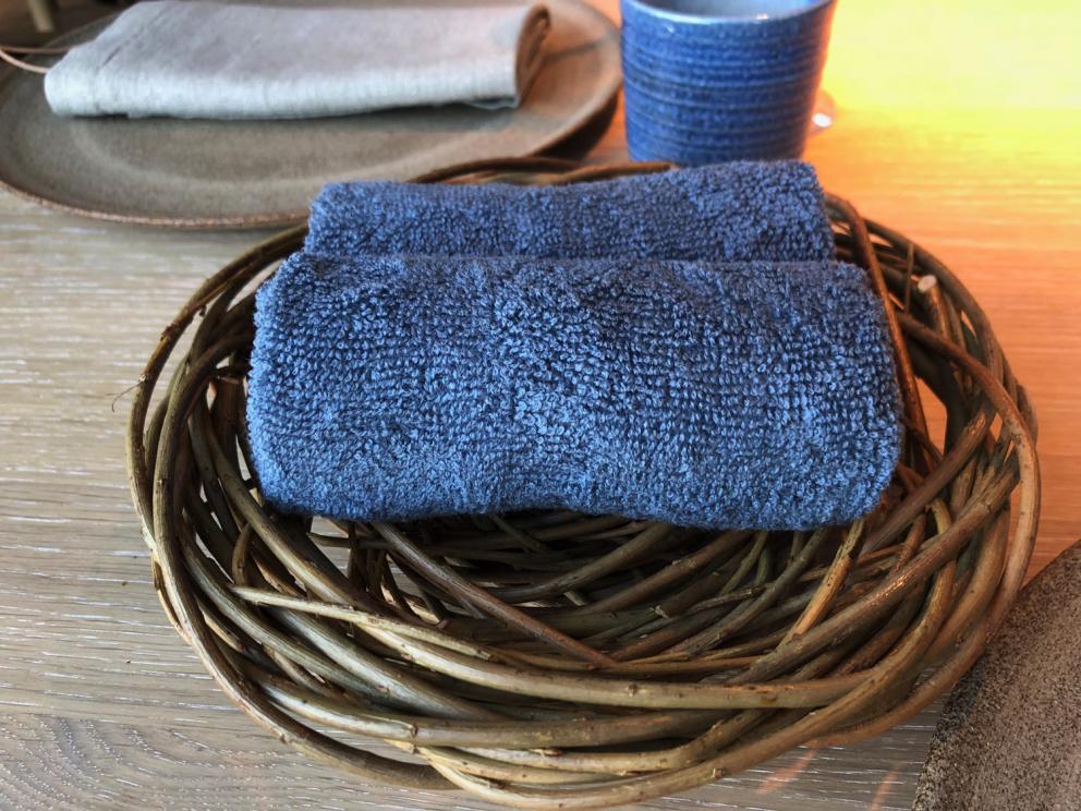 Photogallery






Noma 2.0 is in Christianshavn, the same neighbourhood as the first Noma. They’re 1.5 km apart, a 15 minutes’ walk. This picture shows the distance: to the right, there’s the warehouse of the old location (in Strandgade 93), to the left the smokestacks of Amager Bakke, the futuristic incinerator below which stands the new Noma (in Refshalevej 96)









Weather permitting, you can have a peaceful walk between the previous Noma to today’s Noma 









The new Noma is on an isthmus surrounded by canals. In the future they also want to reclaim some small parts for hydroponic farming









Bucolic scene with incinerator









Bikes left outside Noma. It’s the favourite means of transport among employees and interns









The long path taking you to the restaurant. The fence on the left shows how works are still in progress









On the two sides of the path there are the two new sections of the "Noma village", each with its specialty: grill, hot dishes, snacks, fermentations... In one month’s time, behind the fence we’ll have greenhouses, the test kitchen and the bread making area









To the left, before arriving at the restaurant, the future test kitchen. This will be run by Danish Mette Søberg with Riccardo Canella. "My first challenge?", reveals the latter, for a long time sous chef here, "is to work on the extraction of essential oils" 









The future Test Kitchen









The temporary gangway to the restaurant









Looking from the door to the restaurant, there’s a lake and the smokestacks puffing vapour from the Amager Bakke incinerator. It’s a futuristic project, both in terms of sustainability and architecture. It’s also known as Amager Slope or Copenhill, and its author is starchitect Bjarke Ingels, the same who designed the new Noma. Gradually opened in 2017, it transforms waste into electricity. The goal is to donate electricity to 62500 houses and hot water to 160000. It’s part of an ambitious project to transform Copenhagen into the first city in the world in terms of zero carbon dioxide emissions by 2025. By autumn this year, Amager Slope should open its ski slope, a climbing wall and a hiking track. You’ll be able to slalom on top of the incinerator









The windows from the dining room









Work is still in progress (photo taken on Thursday 22nd February 2018)









Traces of the old building, with barbwire. During WWII, they built bombs here









A view of the dining room at night (photo from Instagram/James Spreadbury)









The entrance to the restaurant









The usual ritual: a welcome from the entire staff, led by Rene Redzepi 









Behind the entrance, there are formaldehyde tanks with creatures from the abyss, shaped as in Damien Hirst’s works. The first image once you’re inside is to reproduce a Scandinavian village









The service kitchen is larger, more spacious and a completely open view from the dining room: "It’s the heart of our Scandinavian village", says Canella. There are 30 cooks working here now. 10 more, compared to the previous Noma









Large skylights above the cooks









There are currently more than 100 people working at Noma, of whom 63 are cooks - 26 employed, and 37 as interns









There’s fire in the kitchen, for the first time









On average, the dining room can host 40 people. "However", complains Redzepi, "there’s always someone who turns up with more people than the ones booked"









While the dining room is set, the outside space still need to be defined









The staff made the dining room decorations. There are no overly expensive designer objects









Dried fish









Seaweeds hanging from the ceiling









Dried octopus heads preserved in salt (with a balloon inside)














Bjarke Ingels and Redzepi’s plan included the wish to recreate a Danish farm









The luminous private dining room









The counter in the dining room. They drew the beams from the canals around the restaurant














The mise en place, bare and strictly without tablecloths









Water jug, candle, flower vase






