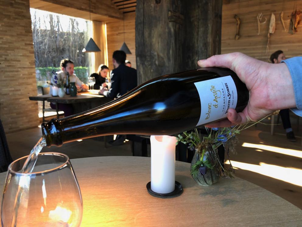 Photogallery






Noma 2.0 is in Christianshavn, the same neighbourhood as the first Noma. They’re 1.5 km apart, a 15 minutes’ walk. This picture shows the distance: to the right, there’s the warehouse of the old location (in Strandgade 93), to the left the smokestacks of Amager Bakke, the futuristic incinerator below which stands the new Noma (in Refshalevej 96)









Weather permitting, you can have a peaceful walk between the previous Noma to today’s Noma 









The new Noma is on an isthmus surrounded by canals. In the future they also want to reclaim some small parts for hydroponic farming









Bucolic scene with incinerator









Bikes left outside Noma. It’s the favourite means of transport among employees and interns









The long path taking you to the restaurant. The fence on the left shows how works are still in progress









On the two sides of the path there are the two new sections of the "Noma village", each with its specialty: grill, hot dishes, snacks, fermentations... In one month’s time, behind the fence we’ll have greenhouses, the test kitchen and the bread making area









To the left, before arriving at the restaurant, the future test kitchen. This will be run by Danish Mette Søberg with Riccardo Canella. "My first challenge?", reveals the latter, for a long time sous chef here, "is to work on the extraction of essential oils" 









The future Test Kitchen









The temporary gangway to the restaurant









Looking from the door to the restaurant, there’s a lake and the smokestacks puffing vapour from the Amager Bakke incinerator. It’s a futuristic project, both in terms of sustainability and architecture. It’s also known as Amager Slope or Copenhill, and its author is starchitect Bjarke Ingels, the same who designed the new Noma. Gradually opened in 2017, it transforms waste into electricity. The goal is to donate electricity to 62500 houses and hot water to 160000. It’s part of an ambitious project to transform Copenhagen into the first city in the world in terms of zero carbon dioxide emissions by 2025. By autumn this year, Amager Slope should open its ski slope, a climbing wall and a hiking track. You’ll be able to slalom on top of the incinerator









The windows from the dining room









Work is still in progress (photo taken on Thursday 22nd February 2018)









Traces of the old building, with barbwire. During WWII, they built bombs here









A view of the dining room at night (photo from Instagram/James Spreadbury)









The entrance to the restaurant









The usual ritual: a welcome from the entire staff, led by Rene Redzepi 









Behind the entrance, there are formaldehyde tanks with creatures from the abyss, shaped as in Damien Hirst’s works. The first image once you’re inside is to reproduce a Scandinavian village









The service kitchen is larger, more spacious and a completely open view from the dining room: "It’s the heart of our Scandinavian village", says Canella. There are 30 cooks working here now. 10 more, compared to the previous Noma









Large skylights above the cooks









There are currently more than 100 people working at Noma, of whom 63 are cooks - 26 employed, and 37 as interns









There’s fire in the kitchen, for the first time









On average, the dining room can host 40 people. "However", complains Redzepi, "there’s always someone who turns up with more people than the ones booked"









While the dining room is set, the outside space still need to be defined









The staff made the dining room decorations. There are no overly expensive designer objects









Dried fish









Seaweeds hanging from the ceiling









Dried octopus heads preserved in salt (with a balloon inside)














Bjarke Ingels and Redzepi’s plan included the wish to recreate a Danish farm









The luminous private dining room









The counter in the dining room. They drew the beams from the canals around the restaurant














The mise en place, bare and strictly without tablecloths









Water jug, candle, flower vase









A warm cloth, to begin with









Australian James Spreadbury, restaurant manager and partner at Noma






