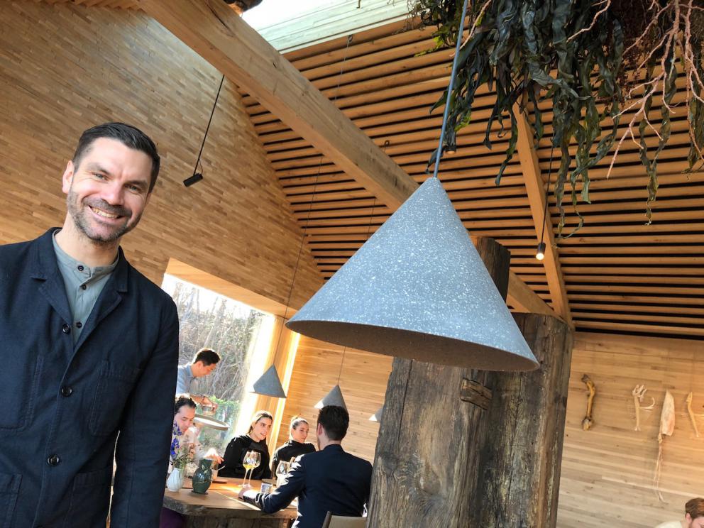 Photogallery






Noma 2.0 is in Christianshavn, the same neighbourhood as the first Noma. They’re 1.5 km apart, a 15 minutes’ walk. This picture shows the distance: to the right, there’s the warehouse of the old location (in Strandgade 93), to the left the smokestacks of Amager Bakke, the futuristic incinerator below which stands the new Noma (in Refshalevej 96)









Weather permitting, you can have a peaceful walk between the previous Noma to today’s Noma 









The new Noma is on an isthmus surrounded by canals. In the future they also want to reclaim some small parts for hydroponic farming









Bucolic scene with incinerator









Bikes left outside Noma. It’s the favourite means of transport among employees and interns









The long path taking you to the restaurant. The fence on the left shows how works are still in progress









On the two sides of the path there are the two new sections of the "Noma village", each with its specialty: grill, hot dishes, snacks, fermentations... In one month’s time, behind the fence we’ll have greenhouses, the test kitchen and the bread making area









To the left, before arriving at the restaurant, the future test kitchen. This will be run by Danish Mette Søberg with Riccardo Canella. "My first challenge?", reveals the latter, for a long time sous chef here, "is to work on the extraction of essential oils" 









The future Test Kitchen









The temporary gangway to the restaurant









Looking from the door to the restaurant, there’s a lake and the smokestacks puffing vapour from the Amager Bakke incinerator. It’s a futuristic project, both in terms of sustainability and architecture. It’s also known as Amager Slope or Copenhill, and its author is starchitect Bjarke Ingels, the same who designed the new Noma. Gradually opened in 2017, it transforms waste into electricity. The goal is to donate electricity to 62500 houses and hot water to 160000. It’s part of an ambitious project to transform Copenhagen into the first city in the world in terms of zero carbon dioxide emissions by 2025. By autumn this year, Amager Slope should open its ski slope, a climbing wall and a hiking track. You’ll be able to slalom on top of the incinerator









The windows from the dining room









Work is still in progress (photo taken on Thursday 22nd February 2018)









Traces of the old building, with barbwire. During WWII, they built bombs here









A view of the dining room at night (photo from Instagram/James Spreadbury)









The entrance to the restaurant









The usual ritual: a welcome from the entire staff, led by Rene Redzepi 









Behind the entrance, there are formaldehyde tanks with creatures from the abyss, shaped as in Damien Hirst’s works. The first image once you’re inside is to reproduce a Scandinavian village









The service kitchen is larger, more spacious and a completely open view from the dining room: "It’s the heart of our Scandinavian village", says Canella. There are 30 cooks working here now. 10 more, compared to the previous Noma









Large skylights above the cooks









There are currently more than 100 people working at Noma, of whom 63 are cooks - 26 employed, and 37 as interns









There’s fire in the kitchen, for the first time









On average, the dining room can host 40 people. "However", complains Redzepi, "there’s always someone who turns up with more people than the ones booked"









While the dining room is set, the outside space still need to be defined









The staff made the dining room decorations. There are no overly expensive designer objects









Dried fish









Seaweeds hanging from the ceiling









Dried octopus heads preserved in salt (with a balloon inside)














Bjarke Ingels and Redzepi’s plan included the wish to recreate a Danish farm









The luminous private dining room









The counter in the dining room. They drew the beams from the canals around the restaurant














The mise en place, bare and strictly without tablecloths









Water jug, candle, flower vase









A warm cloth, to begin with






