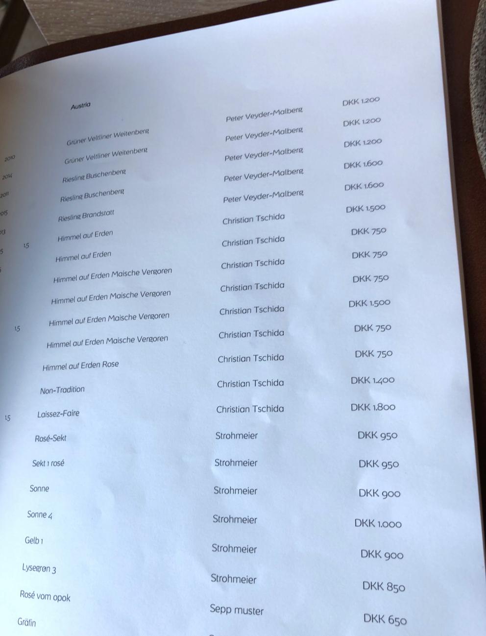 Photogallery






Noma 2.0 is in Christianshavn, the same neighbourhood as the first Noma. They’re 1.5 km apart, a 15 minutes’ walk. This picture shows the distance: to the right, there’s the warehouse of the old location (in Strandgade 93), to the left the smokestacks of Amager Bakke, the futuristic incinerator below which stands the new Noma (in Refshalevej 96)









Weather permitting, you can have a peaceful walk between the previous Noma to today’s Noma 









The new Noma is on an isthmus surrounded by canals. In the future they also want to reclaim some small parts for hydroponic farming









Bucolic scene with incinerator









Bikes left outside Noma. It’s the favourite means of transport among employees and interns









The long path taking you to the restaurant. The fence on the left shows how works are still in progress









On the two sides of the path there are the two new sections of the "Noma village", each with its specialty: grill, hot dishes, snacks, fermentations... In one month’s time, behind the fence we’ll have greenhouses, the test kitchen and the bread making area









To the left, before arriving at the restaurant, the future test kitchen. This will be run by Danish Mette Søberg with Riccardo Canella. "My first challenge?", reveals the latter, for a long time sous chef here, "is to work on the extraction of essential oils" 









The future Test Kitchen









The temporary gangway to the restaurant









Looking from the door to the restaurant, there’s a lake and the smokestacks puffing vapour from the Amager Bakke incinerator. It’s a futuristic project, both in terms of sustainability and architecture. It’s also known as Amager Slope or Copenhill, and its author is starchitect Bjarke Ingels, the same who designed the new Noma. Gradually opened in 2017, it transforms waste into electricity. The goal is to donate electricity to 62500 houses and hot water to 160000. It’s part of an ambitious project to transform Copenhagen into the first city in the world in terms of zero carbon dioxide emissions by 2025. By autumn this year, Amager Slope should open its ski slope, a climbing wall and a hiking track. You’ll be able to slalom on top of the incinerator









The windows from the dining room









Work is still in progress (photo taken on Thursday 22nd February 2018)









Traces of the old building, with barbwire. During WWII, they built bombs here









A view of the dining room at night (photo from Instagram/James Spreadbury)









The entrance to the restaurant









The usual ritual: a welcome from the entire staff, led by Rene Redzepi 









Behind the entrance, there are formaldehyde tanks with creatures from the abyss, shaped as in Damien Hirst’s works. The first image once you’re inside is to reproduce a Scandinavian village









The service kitchen is larger, more spacious and a completely open view from the dining room: "It’s the heart of our Scandinavian village", says Canella. There are 30 cooks working here now. 10 more, compared to the previous Noma









Large skylights above the cooks









There are currently more than 100 people working at Noma, of whom 63 are cooks - 26 employed, and 37 as interns









There’s fire in the kitchen, for the first time









On average, the dining room can host 40 people. "However", complains Redzepi, "there’s always someone who turns up with more people than the ones booked"









While the dining room is set, the outside space still need to be defined









The staff made the dining room decorations. There are no overly expensive designer objects









Dried fish









Seaweeds hanging from the ceiling









Dried octopus heads preserved in salt (with a balloon inside)














Bjarke Ingels and Redzepi’s plan included the wish to recreate a Danish farm









The luminous private dining room









The counter in the dining room. They drew the beams from the canals around the restaurant














The mise en place, bare and strictly without tablecloths









Water jug, candle, flower vase









A warm cloth, to begin with









Australian James Spreadbury, restaurant manager and partner at Noma









Welcome drink: Champagne extra brut Blanc d'Argile from Domaine Vouette et Sorbée









Sea Snail broth. The welcome dish at Noma is, as usual, a hot “soup”









Stefano Ferrano, from Torino, presents the following dish. There’s always a large Italian colony at Noma









Venus clams. Molluscs from Limfjord (Denmark) mixed with decorative clams, typical of Noma. Beside them, shells with blackcurrant oil and “Danish curry”, made with toasted coriander seeds, fennel and fennel seeds









The lid above the following dish. The mussels are not edible









Best of the mussel. Mussels open in a pan with water of fermented barley. «We recreate the mussel», says Canella, «using just the flaps, the best part». The paste is made with scraps from the mussel, cooked in smoked butter









The next dish is conceived and served by Riccardo Canella, the Paduan sous chef who conquered Redzepi, here with dining room intern Feline Hansen









Dried fruits and shrimps. In this case, the heads are not a decoration, but you must suck them –best not eat them because of the bones: they’re filled with a lovely prawn cream. The small crustaceans are still alive when they arrive on a ship straight from the Norwegian fjords









Inside, under the prawn broth skin, there’s fruits and vegetable preserved from the previous summer with raw prawns and gooseberry sauce with blackcurrant oil









How about beverages? There are three options, as usual: wine pairing (6 glasses plus a beer plus sake, 150 euros), juice pairing (juices and extracts, 110 euros) or a choice from the list. They recommend Champagne Chut... Libre from Val'Frison pour Dominique Derain, 50% Pinot Noir, 50% Chardonnay created by a couple who met at the old Noma. Well bodied, it will be a good match throughout the meal









As usual, the wine list starts with Champagne: the cheapest is 1400 crowns (190 euros)






