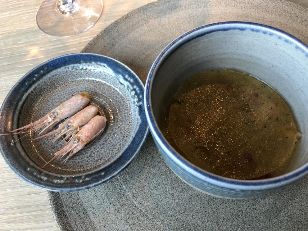 Photogallery






Noma 2.0 is in Christianshavn, the same neighbourhood as the first Noma. They’re 1.5 km apart, a 15 minutes’ walk. This picture shows the distance: to the right, there’s the warehouse of the old location (in Strandgade 93), to the left the smokestacks of Amager Bakke, the futuristic incinerator below which stands the new Noma (in Refshalevej 96)









Weather permitting, you can have a peaceful walk between the previous Noma to today’s Noma 









The new Noma is on an isthmus surrounded by canals. In the future they also want to reclaim some small parts for hydroponic farming









Bucolic scene with incinerator









Bikes left outside Noma. It’s the favourite means of transport among employees and interns









The long path taking you to the restaurant. The fence on the left shows how works are still in progress









On the two sides of the path there are the two new sections of the "Noma village", each with its specialty: grill, hot dishes, snacks, fermentations... In one month’s time, behind the fence we’ll have greenhouses, the test kitchen and the bread making area









To the left, before arriving at the restaurant, the future test kitchen. This will be run by Danish Mette Søberg with Riccardo Canella. "My first challenge?", reveals the latter, for a long time sous chef here, "is to work on the extraction of essential oils" 









The future Test Kitchen









The temporary gangway to the restaurant









Looking from the door to the restaurant, there’s a lake and the smokestacks puffing vapour from the Amager Bakke incinerator. It’s a futuristic project, both in terms of sustainability and architecture. It’s also known as Amager Slope or Copenhill, and its author is starchitect Bjarke Ingels, the same who designed the new Noma. Gradually opened in 2017, it transforms waste into electricity. The goal is to donate electricity to 62500 houses and hot water to 160000. It’s part of an ambitious project to transform Copenhagen into the first city in the world in terms of zero carbon dioxide emissions by 2025. By autumn this year, Amager Slope should open its ski slope, a climbing wall and a hiking track. You’ll be able to slalom on top of the incinerator









The windows from the dining room









Work is still in progress (photo taken on Thursday 22nd February 2018)









Traces of the old building, with barbwire. During WWII, they built bombs here









A view of the dining room at night (photo from Instagram/James Spreadbury)









The entrance to the restaurant









The usual ritual: a welcome from the entire staff, led by Rene Redzepi 









Behind the entrance, there are formaldehyde tanks with creatures from the abyss, shaped as in Damien Hirst’s works. The first image once you’re inside is to reproduce a Scandinavian village









The service kitchen is larger, more spacious and a completely open view from the dining room: "It’s the heart of our Scandinavian village", says Canella. There are 30 cooks working here now. 10 more, compared to the previous Noma









Large skylights above the cooks









There are currently more than 100 people working at Noma, of whom 63 are cooks - 26 employed, and 37 as interns









There’s fire in the kitchen, for the first time









On average, the dining room can host 40 people. "However", complains Redzepi, "there’s always someone who turns up with more people than the ones booked"









While the dining room is set, the outside space still need to be defined









The staff made the dining room decorations. There are no overly expensive designer objects









Dried fish









Seaweeds hanging from the ceiling









Dried octopus heads preserved in salt (with a balloon inside)














Bjarke Ingels and Redzepi’s plan included the wish to recreate a Danish farm









The luminous private dining room









The counter in the dining room. They drew the beams from the canals around the restaurant














The mise en place, bare and strictly without tablecloths









Water jug, candle, flower vase









A warm cloth, to begin with









Australian James Spreadbury, restaurant manager and partner at Noma









Welcome drink: Champagne extra brut Blanc d'Argile from Domaine Vouette et Sorbée









Sea Snail broth. The welcome dish at Noma is, as usual, a hot “soup”









Stefano Ferrano, from Torino, presents the following dish. There’s always a large Italian colony at Noma









Venus clams. Molluscs from Limfjord (Denmark) mixed with decorative clams, typical of Noma. Beside them, shells with blackcurrant oil and “Danish curry”, made with toasted coriander seeds, fennel and fennel seeds









The lid above the following dish. The mussels are not edible









Best of the mussel. Mussels open in a pan with water of fermented barley. «We recreate the mussel», says Canella, «using just the flaps, the best part». The paste is made with scraps from the mussel, cooked in smoked butter









The next dish is conceived and served by Riccardo Canella, the Paduan sous chef who conquered Redzepi, here with dining room intern Feline Hansen









Dried fruits and shrimps. In this case, the heads are not a decoration, but you must suck them –best not eat them because of the bones: they’re filled with a lovely prawn cream. The small crustaceans are still alive when they arrive on a ship straight from the Norwegian fjords






