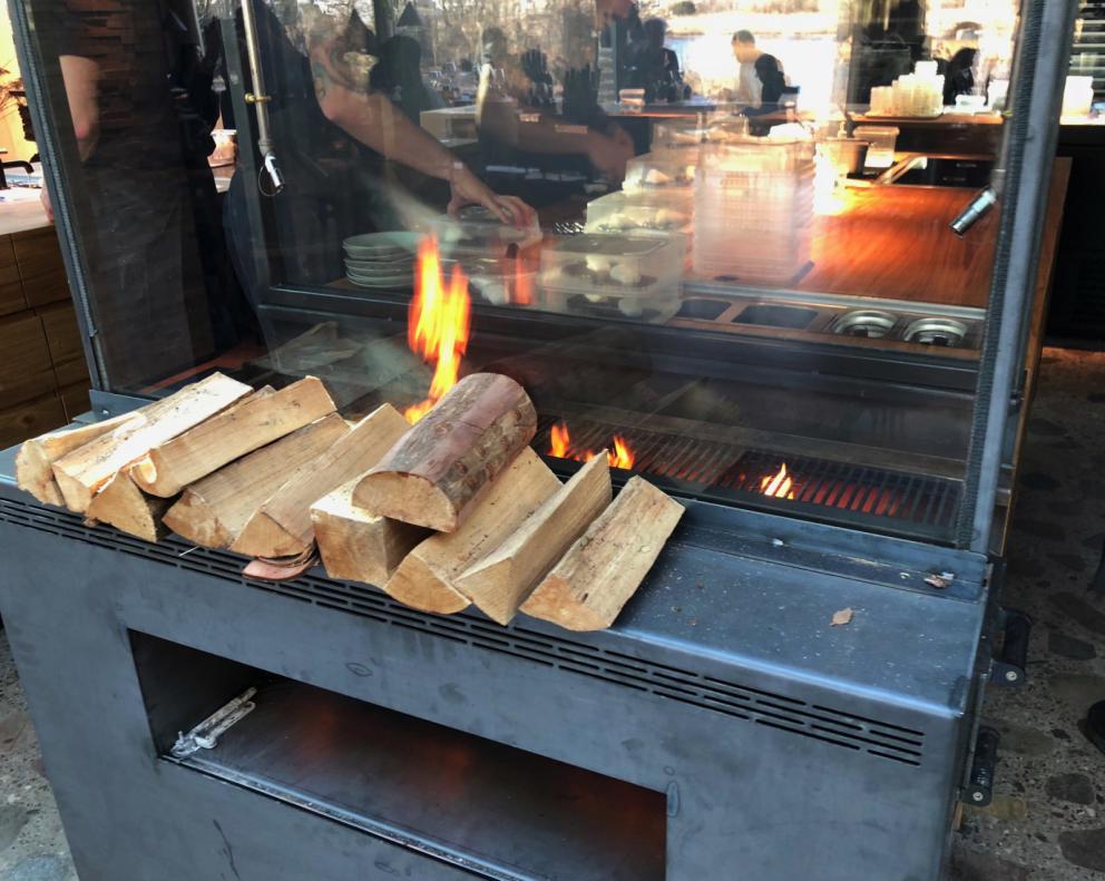 Photogallery






Noma 2.0 is in Christianshavn, the same neighbourhood as the first Noma. They’re 1.5 km apart, a 15 minutes’ walk. This picture shows the distance: to the right, there’s the warehouse of the old location (in Strandgade 93), to the left the smokestacks of Amager Bakke, the futuristic incinerator below which stands the new Noma (in Refshalevej 96)









Weather permitting, you can have a peaceful walk between the previous Noma to today’s Noma 









The new Noma is on an isthmus surrounded by canals. In the future they also want to reclaim some small parts for hydroponic farming









Bucolic scene with incinerator









Bikes left outside Noma. It’s the favourite means of transport among employees and interns









The long path taking you to the restaurant. The fence on the left shows how works are still in progress









On the two sides of the path there are the two new sections of the "Noma village", each with its specialty: grill, hot dishes, snacks, fermentations... In one month’s time, behind the fence we’ll have greenhouses, the test kitchen and the bread making area









To the left, before arriving at the restaurant, the future test kitchen. This will be run by Danish Mette Søberg with Riccardo Canella. "My first challenge?", reveals the latter, for a long time sous chef here, "is to work on the extraction of essential oils" 









The future Test Kitchen









The temporary gangway to the restaurant









Looking from the door to the restaurant, there’s a lake and the smokestacks puffing vapour from the Amager Bakke incinerator. It’s a futuristic project, both in terms of sustainability and architecture. It’s also known as Amager Slope or Copenhill, and its author is starchitect Bjarke Ingels, the same who designed the new Noma. Gradually opened in 2017, it transforms waste into electricity. The goal is to donate electricity to 62500 houses and hot water to 160000. It’s part of an ambitious project to transform Copenhagen into the first city in the world in terms of zero carbon dioxide emissions by 2025. By autumn this year, Amager Slope should open its ski slope, a climbing wall and a hiking track. You’ll be able to slalom on top of the incinerator









The windows from the dining room









Work is still in progress (photo taken on Thursday 22nd February 2018)









Traces of the old building, with barbwire. During WWII, they built bombs here









A view of the dining room at night (photo from Instagram/James Spreadbury)









The entrance to the restaurant









The usual ritual: a welcome from the entire staff, led by Rene Redzepi 









Behind the entrance, there are formaldehyde tanks with creatures from the abyss, shaped as in Damien Hirst’s works. The first image once you’re inside is to reproduce a Scandinavian village









The service kitchen is larger, more spacious and a completely open view from the dining room: "It’s the heart of our Scandinavian village", says Canella. There are 30 cooks working here now. 10 more, compared to the previous Noma









Large skylights above the cooks









There are currently more than 100 people working at Noma, of whom 63 are cooks - 26 employed, and 37 as interns






