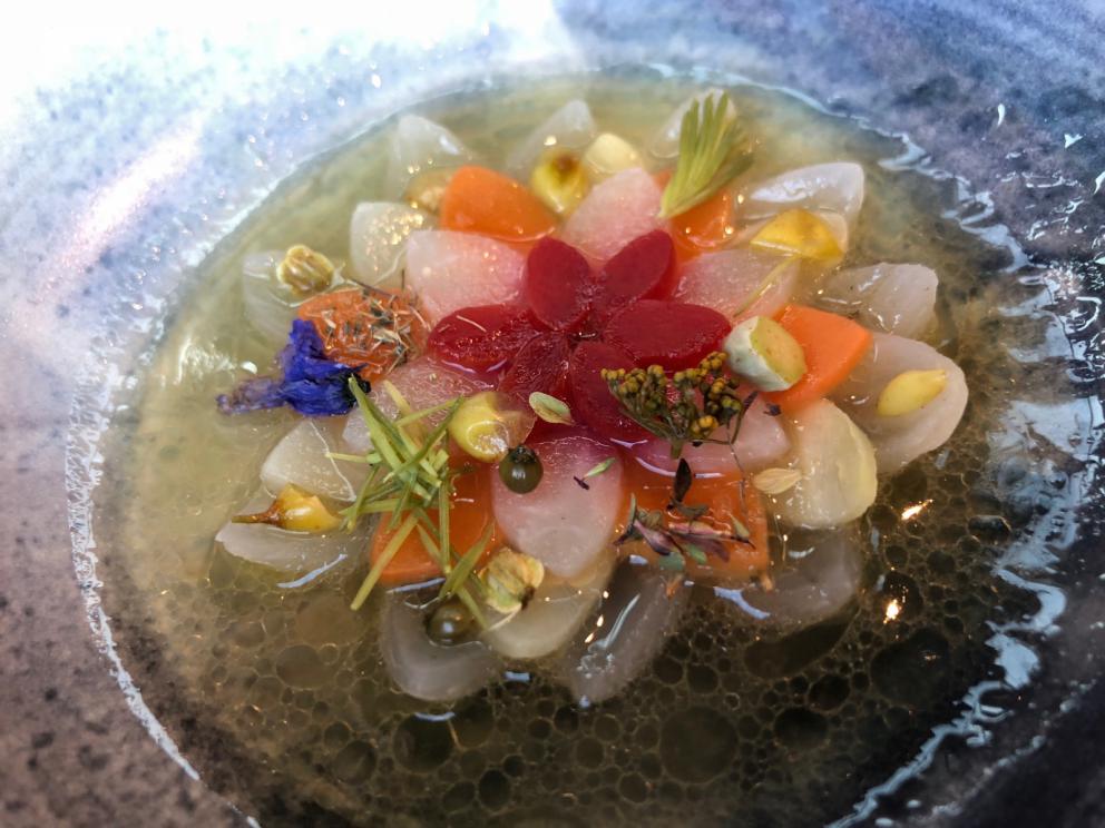 Photogallery






Noma 2.0 is in Christianshavn, the same neighbourhood as the first Noma. They’re 1.5 km apart, a 15 minutes’ walk. This picture shows the distance: to the right, there’s the warehouse of the old location (in Strandgade 93), to the left the smokestacks of Amager Bakke, the futuristic incinerator below which stands the new Noma (in Refshalevej 96)









Weather permitting, you can have a peaceful walk between the previous Noma to today’s Noma 









The new Noma is on an isthmus surrounded by canals. In the future they also want to reclaim some small parts for hydroponic farming









Bucolic scene with incinerator









Bikes left outside Noma. It’s the favourite means of transport among employees and interns









The long path taking you to the restaurant. The fence on the left shows how works are still in progress









On the two sides of the path there are the two new sections of the "Noma village", each with its specialty: grill, hot dishes, snacks, fermentations... In one month’s time, behind the fence we’ll have greenhouses, the test kitchen and the bread making area









To the left, before arriving at the restaurant, the future test kitchen. This will be run by Danish Mette Søberg with Riccardo Canella. "My first challenge?", reveals the latter, for a long time sous chef here, "is to work on the extraction of essential oils" 









The future Test Kitchen









The temporary gangway to the restaurant









Looking from the door to the restaurant, there’s a lake and the smokestacks puffing vapour from the Amager Bakke incinerator. It’s a futuristic project, both in terms of sustainability and architecture. It’s also known as Amager Slope or Copenhill, and its author is starchitect Bjarke Ingels, the same who designed the new Noma. Gradually opened in 2017, it transforms waste into electricity. The goal is to donate electricity to 62500 houses and hot water to 160000. It’s part of an ambitious project to transform Copenhagen into the first city in the world in terms of zero carbon dioxide emissions by 2025. By autumn this year, Amager Slope should open its ski slope, a climbing wall and a hiking track. You’ll be able to slalom on top of the incinerator









The windows from the dining room









Work is still in progress (photo taken on Thursday 22nd February 2018)









Traces of the old building, with barbwire. During WWII, they built bombs here









A view of the dining room at night (photo from Instagram/James Spreadbury)









The entrance to the restaurant









The usual ritual: a welcome from the entire staff, led by Rene Redzepi 









Behind the entrance, there are formaldehyde tanks with creatures from the abyss, shaped as in Damien Hirst’s works. The first image once you’re inside is to reproduce a Scandinavian village









The service kitchen is larger, more spacious and a completely open view from the dining room: "It’s the heart of our Scandinavian village", says Canella. There are 30 cooks working here now. 10 more, compared to the previous Noma









Large skylights above the cooks









There are currently more than 100 people working at Noma, of whom 63 are cooks - 26 employed, and 37 as interns









There’s fire in the kitchen, for the first time









On average, the dining room can host 40 people. "However", complains Redzepi, "there’s always someone who turns up with more people than the ones booked"









While the dining room is set, the outside space still need to be defined









The staff made the dining room decorations. There are no overly expensive designer objects









Dried fish









Seaweeds hanging from the ceiling









Dried octopus heads preserved in salt (with a balloon inside)














Bjarke Ingels and Redzepi’s plan included the wish to recreate a Danish farm









The luminous private dining room









The counter in the dining room. They drew the beams from the canals around the restaurant














The mise en place, bare and strictly without tablecloths









Water jug, candle, flower vase









A warm cloth, to begin with









Australian James Spreadbury, restaurant manager and partner at Noma









Welcome drink: Champagne extra brut Blanc d'Argile from Domaine Vouette et Sorbée









Sea Snail broth. The welcome dish at Noma is, as usual, a hot “soup”









Stefano Ferrano, from Torino, presents the following dish. There’s always a large Italian colony at Noma









Venus clams. Molluscs from Limfjord (Denmark) mixed with decorative clams, typical of Noma. Beside them, shells with blackcurrant oil and “Danish curry”, made with toasted coriander seeds, fennel and fennel seeds









The lid above the following dish. The mussels are not edible









Best of the mussel. Mussels open in a pan with water of fermented barley. «We recreate the mussel», says Canella, «using just the flaps, the best part». The paste is made with scraps from the mussel, cooked in smoked butter









The next dish is conceived and served by Riccardo Canella, the Paduan sous chef who conquered Redzepi, here with dining room intern Feline Hansen









Dried fruits and shrimps. In this case, the heads are not a decoration, but you must suck them –best not eat them because of the bones: they’re filled with a lovely prawn cream. The small crustaceans are still alive when they arrive on a ship straight from the Norwegian fjords









Inside, under the prawn broth skin, there’s fruits and vegetable preserved from the previous summer with raw prawns and gooseberry sauce with blackcurrant oil









How about beverages? There are three options, as usual: wine pairing (6 glasses plus a beer plus sake, 150 euros), juice pairing (juices and extracts, 110 euros) or a choice from the list. They recommend Champagne Chut... Libre from Val'Frison pour Dominique Derain, 50% Pinot Noir, 50% Chardonnay created by a couple who met at the old Noma. Well bodied, it will be a good match throughout the meal









As usual, the wine list starts with Champagne: the cheapest is 1400 crowns (190 euros)









White wines begin with labels from cold climates: first Austria, increasingly popular for its natural wines, then Germany, then all the others









How about Italy? Few names, among the white wines, from North and South









A dozen red/orange wines









Sea star, that is to say Cured trout roe and eggs, the emblem dish of this new era. They recommend moving the teaspoon from the heart to the edges of the tentacles. Aesthetics win over taste









Jellyfish. The jellyfish gel in the middle is in fact a clarified broth of calamari and recalls the texture of jellyfish. "We tried to cook jellyfish in 300 different ways but none was convincing so far". All around, pickled seaweed. The gel is almost tasteless, it serves to clean the palate after the pickles









Rene Redzepi himself presents the content of the first Seafood platter.









French style service with a small plate below for the empty shells









It’s made of two (per two) pieces: queen clam and mahogany clam









The Queen Clam is a very small variety of Norwegian scallop, seasoned with a vegetal reduction made with cucumber and peas miso. The red tip is the coral. "You should eat it using the top shell ", recommends Redzepi









The Mahogany clam is a centennial clam from the North Sea, very popular in Denmark and Iceland. «You can tell the age by the number of rings, like with trees», says Redzepi, «In 2007 they found one that was 450 years old. We’ve had it in the menu for a decade or so». The razor clam shell serves as teaspoon









Inside, there’s obviously not just a bare Mahogany. «We open it when the client arrives», says Canella, «remove the entrails and then slice it so as to preserve its firm texture». It’s seasoned with stir-fried gooseberry, capers of blackcurrants and blackcurrant sprouts preserved in vinegar. The sauce is made with mussel water









A note on the chairs: they’re more minimalistic. They’re no longer covered in sheepskin or leather from other Danish animals, in the style of Noma 1.0. The most significant element is the napkin: if you go to the toilet, they no longer replace it with a new one. There’s the old one, tied to the chair. "This is sustainability", they explain









The second seafood platter. It’s made of Sea cucumber and sour cream in various textures, including «chicharrones» (at 9 o’clock), sea urchins (at 12 and 3) and gigas oyster (at 6)









Sea urchins pressed in fresh cream and pumpkin seeds









Giga Oyster, a huge oyster from the Pacific, quickly steamed and garnished with pickles. Noma only reserved one thousand of these. In the menu until available









The following dish, off the menu, is again from Canella: horse mussel ragout, rare specimen of which 30 arrive at 'Noma each week









They cook the mussel as if it were kidney, in a sort of Bolognese sauce but with ginger. Ginger? "Yes, we’ve decided to include it, as with other spices, after our Mexican experience"









Another Italian presents a dish, Edoardo Fiaschi from Prato, at Noma for 3 years now









Squid in seaweed butter. An almost neglected Danish squid lightly seared in fermented koji oil, rolled and seasoned with seaweed butter and served on sticks of blackcurrant that widen its aromas. Formidable and beautiful









The following dish is inside a nice bee wax container. It’s made with balloons covered multiple times in bee wax. «We spent weeks making them. We’ve made thousands». They’re disposable...









Sea snail and roses. They recommend to: "Eat it keeping the bee wax on your hands "









Sea snail. Another small nibble from the top part of the sea snail, lightly warmed up in water and served on a reduction of lemon thyme









A sea snail toothpick, initially carved by Redzepi himself









Head of the cod, (right), the real main course at Noma









Another rather laborious recipe. «It takes half an hour just to separate the head. We remove the skin, the collagen, we cut mandibles, tongue, cheek and the part behind. We rinse it in water, spices, koji and cook it in the yakitori with a glaze of mushrooms and spiced fennel broth»









You can garnish the cod as you choose, with a paste of ants (top right corner), a slightly spicy emulsion of koji oil, water and horseradish sauce (left) and Danish curry (bottom)









On the side of the cod, there’s also wild garlic seasoned with smoked butter and roasted yeast. Intense flavour









Cod bones after the tasting









An interlocutory snack made of cod cheek






