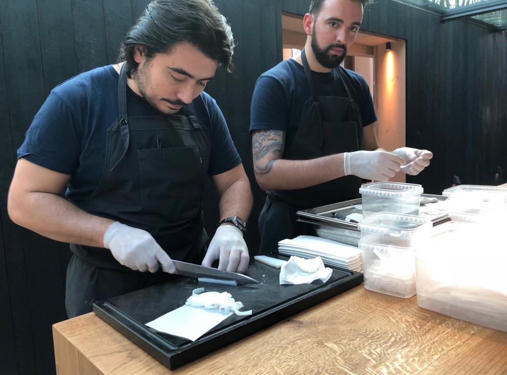 Photogallery






Noma 2.0 is in Christianshavn, the same neighbourhood as the first Noma. They’re 1.5 km apart, a 15 minutes’ walk. This picture shows the distance: to the right, there’s the warehouse of the old location (in Strandgade 93), to the left the smokestacks of Amager Bakke, the futuristic incinerator below which stands the new Noma (in Refshalevej 96)









Weather permitting, you can have a peaceful walk between the previous Noma to today’s Noma 









The new Noma is on an isthmus surrounded by canals. In the future they also want to reclaim some small parts for hydroponic farming









Bucolic scene with incinerator









Bikes left outside Noma. It’s the favourite means of transport among employees and interns









The long path taking you to the restaurant. The fence on the left shows how works are still in progress









On the two sides of the path there are the two new sections of the "Noma village", each with its specialty: grill, hot dishes, snacks, fermentations... In one month’s time, behind the fence we’ll have greenhouses, the test kitchen and the bread making area









To the left, before arriving at the restaurant, the future test kitchen. This will be run by Danish Mette Søberg with Riccardo Canella. "My first challenge?", reveals the latter, for a long time sous chef here, "is to work on the extraction of essential oils" 









The future Test Kitchen









The temporary gangway to the restaurant









Looking from the door to the restaurant, there’s a lake and the smokestacks puffing vapour from the Amager Bakke incinerator. It’s a futuristic project, both in terms of sustainability and architecture. It’s also known as Amager Slope or Copenhill, and its author is starchitect Bjarke Ingels, the same who designed the new Noma. Gradually opened in 2017, it transforms waste into electricity. The goal is to donate electricity to 62500 houses and hot water to 160000. It’s part of an ambitious project to transform Copenhagen into the first city in the world in terms of zero carbon dioxide emissions by 2025. By autumn this year, Amager Slope should open its ski slope, a climbing wall and a hiking track. You’ll be able to slalom on top of the incinerator









The windows from the dining room









Work is still in progress (photo taken on Thursday 22nd February 2018)









Traces of the old building, with barbwire. During WWII, they built bombs here









A view of the dining room at night (photo from Instagram/James Spreadbury)









The entrance to the restaurant









The usual ritual: a welcome from the entire staff, led by Rene Redzepi 









Behind the entrance, there are formaldehyde tanks with creatures from the abyss, shaped as in Damien Hirst’s works. The first image once you’re inside is to reproduce a Scandinavian village









The service kitchen is larger, more spacious and a completely open view from the dining room: "It’s the heart of our Scandinavian village", says Canella. There are 30 cooks working here now. 10 more, compared to the previous Noma









Large skylights above the cooks









There are currently more than 100 people working at Noma, of whom 63 are cooks - 26 employed, and 37 as interns









There’s fire in the kitchen, for the first time









On average, the dining room can host 40 people. "However", complains Redzepi, "there’s always someone who turns up with more people than the ones booked"









While the dining room is set, the outside space still need to be defined









The staff made the dining room decorations. There are no overly expensive designer objects









Dried fish









Seaweeds hanging from the ceiling









Dried octopus heads preserved in salt (with a balloon inside)














Bjarke Ingels and Redzepi’s plan included the wish to recreate a Danish farm









The luminous private dining room









The counter in the dining room. They drew the beams from the canals around the restaurant














The mise en place, bare and strictly without tablecloths









Water jug, candle, flower vase









A warm cloth, to begin with









Australian James Spreadbury, restaurant manager and partner at Noma









Welcome drink: Champagne extra brut Blanc d'Argile from Domaine Vouette et Sorbée









Sea Snail broth. The welcome dish at Noma is, as usual, a hot “soup”









Stefano Ferrano, from Torino, presents the following dish. There’s always a large Italian colony at Noma









Venus clams. Molluscs from Limfjord (Denmark) mixed with decorative clams, typical of Noma. Beside them, shells with blackcurrant oil and “Danish curry”, made with toasted coriander seeds, fennel and fennel seeds









The lid above the following dish. The mussels are not edible









Best of the mussel. Mussels open in a pan with water of fermented barley. «We recreate the mussel», says Canella, «using just the flaps, the best part». The paste is made with scraps from the mussel, cooked in smoked butter









The next dish is conceived and served by Riccardo Canella, the Paduan sous chef who conquered Redzepi, here with dining room intern Feline Hansen









Dried fruits and shrimps. In this case, the heads are not a decoration, but you must suck them –best not eat them because of the bones: they’re filled with a lovely prawn cream. The small crustaceans are still alive when they arrive on a ship straight from the Norwegian fjords









Inside, under the prawn broth skin, there’s fruits and vegetable preserved from the previous summer with raw prawns and gooseberry sauce with blackcurrant oil









How about beverages? There are three options, as usual: wine pairing (6 glasses plus a beer plus sake, 150 euros), juice pairing (juices and extracts, 110 euros) or a choice from the list. They recommend Champagne Chut... Libre from Val'Frison pour Dominique Derain, 50% Pinot Noir, 50% Chardonnay created by a couple who met at the old Noma. Well bodied, it will be a good match throughout the meal









As usual, the wine list starts with Champagne: the cheapest is 1400 crowns (190 euros)









White wines begin with labels from cold climates: first Austria, increasingly popular for its natural wines, then Germany, then all the others









How about Italy? Few names, among the white wines, from North and South









A dozen red/orange wines









Sea star, that is to say Cured trout roe and eggs, the emblem dish of this new era. They recommend moving the teaspoon from the heart to the edges of the tentacles. Aesthetics win over taste









Jellyfish. The jellyfish gel in the middle is in fact a clarified broth of calamari and recalls the texture of jellyfish. "We tried to cook jellyfish in 300 different ways but none was convincing so far". All around, pickled seaweed. The gel is almost tasteless, it serves to clean the palate after the pickles









Rene Redzepi himself presents the content of the first Seafood platter.









French style service with a small plate below for the empty shells









It’s made of two (per two) pieces: queen clam and mahogany clam









The Queen Clam is a very small variety of Norwegian scallop, seasoned with a vegetal reduction made with cucumber and peas miso. The red tip is the coral. "You should eat it using the top shell ", recommends Redzepi









The Mahogany clam is a centennial clam from the North Sea, very popular in Denmark and Iceland. «You can tell the age by the number of rings, like with trees», says Redzepi, «In 2007 they found one that was 450 years old. We’ve had it in the menu for a decade or so». The razor clam shell serves as teaspoon









Inside, there’s obviously not just a bare Mahogany. «We open it when the client arrives», says Canella, «remove the entrails and then slice it so as to preserve its firm texture». It’s seasoned with stir-fried gooseberry, capers of blackcurrants and blackcurrant sprouts preserved in vinegar. The sauce is made with mussel water









A note on the chairs: they’re more minimalistic. They’re no longer covered in sheepskin or leather from other Danish animals, in the style of Noma 1.0. The most significant element is the napkin: if you go to the toilet, they no longer replace it with a new one. There’s the old one, tied to the chair. "This is sustainability", they explain









The second seafood platter. It’s made of Sea cucumber and sour cream in various textures, including «chicharrones» (at 9 o’clock), sea urchins (at 12 and 3) and gigas oyster (at 6)









Sea urchins pressed in fresh cream and pumpkin seeds









Giga Oyster, a huge oyster from the Pacific, quickly steamed and garnished with pickles. Noma only reserved one thousand of these. In the menu until available









The following dish, off the menu, is again from Canella: horse mussel ragout, rare specimen of which 30 arrive at 'Noma each week









They cook the mussel as if it were kidney, in a sort of Bolognese sauce but with ginger. Ginger? "Yes, we’ve decided to include it, as with other spices, after our Mexican experience"









Another Italian presents a dish, Edoardo Fiaschi from Prato, at Noma for 3 years now









Squid in seaweed butter. An almost neglected Danish squid lightly seared in fermented koji oil, rolled and seasoned with seaweed butter and served on sticks of blackcurrant that widen its aromas. Formidable and beautiful









The following dish is inside a nice bee wax container. It’s made with balloons covered multiple times in bee wax. «We spent weeks making them. We’ve made thousands». They’re disposable...









Sea snail and roses. They recommend to: "Eat it keeping the bee wax on your hands "









Sea snail. Another small nibble from the top part of the sea snail, lightly warmed up in water and served on a reduction of lemon thyme









A sea snail toothpick, initially carved by Redzepi himself









Head of the cod, (right), the real main course at Noma









Another rather laborious recipe. «It takes half an hour just to separate the head. We remove the skin, the collagen, we cut mandibles, tongue, cheek and the part behind. We rinse it in water, spices, koji and cook it in the yakitori with a glaze of mushrooms and spiced fennel broth»









You can garnish the cod as you choose, with a paste of ants (top right corner), a slightly spicy emulsion of koji oil, water and horseradish sauce (left) and Danish curry (bottom)









On the side of the cod, there’s also wild garlic seasoned with smoked butter and roasted yeast. Intense flavour









Cod bones after the tasting









An interlocutory snack made of cod cheek









Pickled vegetables and arctic herbs. The only vegetable dish in the menu, marks the passage from savoury to sweet dishes. Between June and August 2018 the menu at Noma will be 100% vegetarian









Preparation time: half an hour! A challenge for the person making it









Mussels appear once again, a classic emblem









This time it’s a dessert in the shape of a small sandwich. Pear and roasted kelp ice cream 









Cloudberries and pinecones. A dessert that continues Redzepi’s saga of unsweet sweets: cloudberries, pinecones preserved in sugar, yogurt snow (by Italian Jessica Natali) and a sea snail made with cloudberry sorbet









Filtered coffee made with stolen kenyoti seeds farmed in Honduras by a Norwegian guy. Italian sommelier Francesca Niro tells us this story. «In Denmark», she says, «coffee is not a final act»









Sugar kelp tart. Tartelletta di alga kelp con pralinato di pino (sul modello di quello di mandorle, autore Canella), panna e crisp di ostrica









Sugar kelp tart. Jessica Natali, 23, from the March, has been at Noma for 4 years now









Natali introduces the last dish, Plankton cake









It’s Redzepi’s tribute to Andalusian chef Angel Leon, the chef who brought the abyss of the sea on fine dining tables. A final trivia fact at the end of the meal: we were never served bread, a historic strongpoint at Noma. "There’s no need for bread in this menu", said Redzepi









With Canella we walk the very long corridor that starts from the opposite side of the room, right after the entrance






