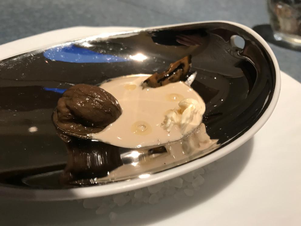 Galleria fotografica






L'inizio di un percorso meraviglioso: Lengua helada de pasión con ron, ossia una lingua di gatto gelata al rum, frutto della passione e menta piperita. Inizia il gioco di temperature









Rosa & lichis: poesia pura. Sferificazioni di acqua di rose (sui petali laterali) e finta mora ghiacciata di lichi









La remolacha que sale de tierra: insieme sorbetto e meringa di barbabietola









Panchino relleno de caviar beluga: uno dei piatti signature del Disfrutar. Si prepara una pasta per brioche con molta acqua e lievito. Viene collocata in un sifone e si ottiene una schiuma. Quindi si riempie il fondo di uno stampo circolare con questa schiuma, si aggiunge il caviale e una crema doppia panna, quindi ancora schiuma per coprire il tutto. Si immerge in una padella con olio a 180 gradi per 20 secondi. Ovviamente il caviale può essere sostituito da formaggi, tonno, sorbetti...









La preparazione al tavolo del Sidra casera ahumada al momento, un sidro di mele istantaneo: si versa sul ghiaccio secco una mistura di liquore e succo di mela e si lascia agire









Inizia il tributo alle noci. Qui il gheriglio, ricostruito, custodisce un quarto di noce, affumicata. E deliziosa. In pratica il guscio è stato aperto, senza romperlo; la noce è stata affumicata, poi rimessa al suo posto, il tutto richiuso






