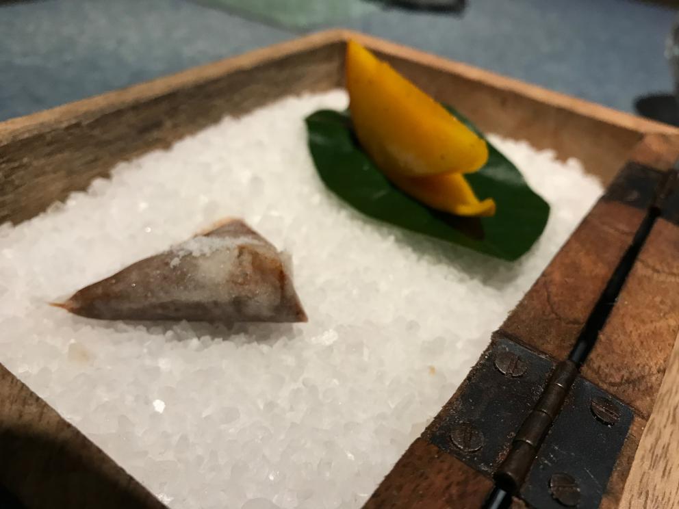 Galleria fotografica






L'inizio di un percorso meraviglioso: Lengua helada de pasión con ron, ossia una lingua di gatto gelata al rum, frutto della passione e menta piperita. Inizia il gioco di temperature









Rosa & lichis: poesia pura. Sferificazioni di acqua di rose (sui petali laterali) e finta mora ghiacciata di lichi









La remolacha que sale de tierra: insieme sorbetto e meringa di barbabietola









Panchino relleno de caviar beluga: uno dei piatti signature del Disfrutar. Si prepara una pasta per brioche con molta acqua e lievito. Viene collocata in un sifone e si ottiene una schiuma. Quindi si riempie il fondo di uno stampo circolare con questa schiuma, si aggiunge il caviale e una crema doppia panna, quindi ancora schiuma per coprire il tutto. Si immerge in una padella con olio a 180 gradi per 20 secondi. Ovviamente il caviale può essere sostituito da formaggi, tonno, sorbetti...









La preparazione al tavolo del Sidra casera ahumada al momento, un sidro di mele istantaneo: si versa sul ghiaccio secco una mistura di liquore e succo di mela e si lascia agire









Inizia il tributo alle noci. Qui il gheriglio, ricostruito, custodisce un quarto di noce, affumicata. E deliziosa. In pratica il guscio è stato aperto, senza romperlo; la noce è stata affumicata, poi rimessa al suo posto, il tutto richiuso









Ancora Cáscara de nuez: qui è un tripudio. Una noce tenera, senza pelle, l'altra verde col gheriglio e resa commestibile, infine l'ultima cotta e macerata nel ratafià, come abbiamo già spiegato nel pezzo. Il tutto con un filo di latte di noce e di olio di frutta secca. L'idea è: con un prodotto possiamo costruire all'infinito






