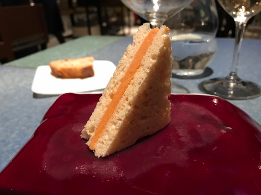 Galleria fotografica






L'inizio di un percorso meraviglioso: Lengua helada de pasión con ron, ossia una lingua di gatto gelata al rum, frutto della passione e menta piperita. Inizia il gioco di temperature









Rosa & lichis: poesia pura. Sferificazioni di acqua di rose (sui petali laterali) e finta mora ghiacciata di lichi









La remolacha que sale de tierra: insieme sorbetto e meringa di barbabietola









Panchino relleno de caviar beluga: uno dei piatti signature del Disfrutar. Si prepara una pasta per brioche con molta acqua e lievito. Viene collocata in un sifone e si ottiene una schiuma. Quindi si riempie il fondo di uno stampo circolare con questa schiuma, si aggiunge il caviale e una crema doppia panna, quindi ancora schiuma per coprire il tutto. Si immerge in una padella con olio a 180 gradi per 20 secondi. Ovviamente il caviale può essere sostituito da formaggi, tonno, sorbetti...









La preparazione al tavolo del Sidra casera ahumada al momento, un sidro di mele istantaneo: si versa sul ghiaccio secco una mistura di liquore e succo di mela e si lascia agire









Inizia il tributo alle noci. Qui il gheriglio, ricostruito, custodisce un quarto di noce, affumicata. E deliziosa. In pratica il guscio è stato aperto, senza romperlo; la noce è stata affumicata, poi rimessa al suo posto, il tutto richiuso









Ancora Cáscara de nuez: qui è un tripudio. Una noce tenera, senza pelle, l'altra verde col gheriglio e resa commestibile, infine l'ultima cotta e macerata nel ratafià, come abbiamo già spiegato nel pezzo. Il tutto con un filo di latte di noce e di olio di frutta secca. L'idea è: con un prodotto possiamo costruire all'infinito









Candy salado de nueces con mango, haba tonka y whisky: la bustina commestibile contiene caramello salato e noci, quindi il mango crudo e il profumo del whisky affumicato









Milhojas de idiazábal, millefoglie di idiazábal, un formaggio basco. Sterzata salata dopo una prima parte di degustazione in cui prevalevano le note dolci (a esaltare anche il caviale del Panchino). In generale, sono tutti piatti che superano la tradizionale distinzione dolce/salato









"Hostia" de flor del mandarino: la finta ostia è di ovulato, racchiude essenza di fiore di mandarino. Un piatto che colpisce il cuore









La Gilda del Disfrutar. La gilda è il classico pincho che si serve nei Paesi Baschi, a base di olive e acciughe. Qui abbiamo le celebri false olive di Adrià, croccanti fuori (burro di cacao) e liquide all'interno. Poi sgombro marinato, semi di pepe basco e la loro crema






