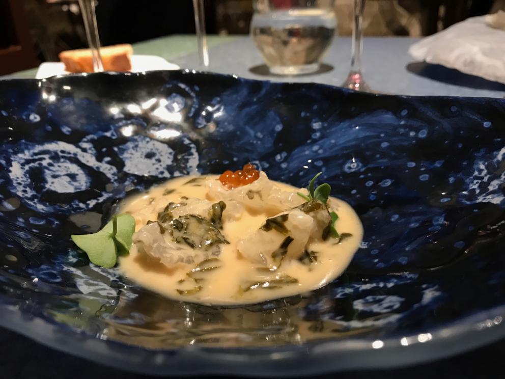 Galleria fotografica






L'inizio di un percorso meraviglioso: Lengua helada de pasión con ron, ossia una lingua di gatto gelata al rum, frutto della passione e menta piperita. Inizia il gioco di temperature









Rosa & lichis: poesia pura. Sferificazioni di acqua di rose (sui petali laterali) e finta mora ghiacciata di lichi









La remolacha que sale de tierra: insieme sorbetto e meringa di barbabietola









Panchino relleno de caviar beluga: uno dei piatti signature del Disfrutar. Si prepara una pasta per brioche con molta acqua e lievito. Viene collocata in un sifone e si ottiene una schiuma. Quindi si riempie il fondo di uno stampo circolare con questa schiuma, si aggiunge il caviale e una crema doppia panna, quindi ancora schiuma per coprire il tutto. Si immerge in una padella con olio a 180 gradi per 20 secondi. Ovviamente il caviale può essere sostituito da formaggi, tonno, sorbetti...









La preparazione al tavolo del Sidra casera ahumada al momento, un sidro di mele istantaneo: si versa sul ghiaccio secco una mistura di liquore e succo di mela e si lascia agire









Inizia il tributo alle noci. Qui il gheriglio, ricostruito, custodisce un quarto di noce, affumicata. E deliziosa. In pratica il guscio è stato aperto, senza romperlo; la noce è stata affumicata, poi rimessa al suo posto, il tutto richiuso









Ancora Cáscara de nuez: qui è un tripudio. Una noce tenera, senza pelle, l'altra verde col gheriglio e resa commestibile, infine l'ultima cotta e macerata nel ratafià, come abbiamo già spiegato nel pezzo. Il tutto con un filo di latte di noce e di olio di frutta secca. L'idea è: con un prodotto possiamo costruire all'infinito









Candy salado de nueces con mango, haba tonka y whisky: la bustina commestibile contiene caramello salato e noci, quindi il mango crudo e il profumo del whisky affumicato









Milhojas de idiazábal, millefoglie di idiazábal, un formaggio basco. Sterzata salata dopo una prima parte di degustazione in cui prevalevano le note dolci (a esaltare anche il caviale del Panchino). In generale, sono tutti piatti che superano la tradizionale distinzione dolce/salato









"Hostia" de flor del mandarino: la finta ostia è di ovulato, racchiude essenza di fiore di mandarino. Un piatto che colpisce il cuore









La Gilda del Disfrutar. La gilda è il classico pincho che si serve nei Paesi Baschi, a base di olive e acciughe. Qui abbiamo le celebri false olive di Adrià, croccanti fuori (burro di cacao) e liquide all'interno. Poi sgombro marinato, semi di pepe basco e la loro crema









Sandwich de gazpacho con guarnición olorosa de vinagre de Jerez: qui il falso pane ghiacciato (sono meringhe di pomodoro secco) racchiude una farcitura in cui emergono le note acide e aromatiche dell'aceto di Jerez a esaltare il classico aroma del gazpacho andaluso









Almendras "supertiernas" en vinagreta: al Disfrutar giocano molto con la frutta secca, qui mandorle ammorbidite o croccanti e accompagnate da aromi di vaniglia, aglio, olio, vinaigrette... Altro capolavoro









Yema de huevo crujiente con gelatina caliente de setas: una crema d'uovo in tempura, croccante fuori e liquida dentro, sopra un gel di funghi racchiuso nel guscio dell'uovo stesso. «Per noi è un classico - ci dicono - Ma sempre molto difficile da gestire»









Piatto spettacolare e gentile, Tatin de foie-gras y maíz multiesférico: tutto giocato su un equilibrio in cui le note dolci sono spinte al limite. La tecnica è quella della multisferificazione, con gel di glutammato a chiudere la partita









Ceviche en deconstrucción: leche de tigre, emulsione di pesce, olio di coriandolo e sorbetto di zucca e ajì. Un classico del Disfrutar

 









Questa è la cartilagine del muso del salmone...






