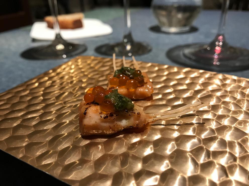 Galleria fotografica






L'inizio di un percorso meraviglioso: Lengua helada de pasión con ron, ossia una lingua di gatto gelata al rum, frutto della passione e menta piperita. Inizia il gioco di temperature









Rosa & lichis: poesia pura. Sferificazioni di acqua di rose (sui petali laterali) e finta mora ghiacciata di lichi









La remolacha que sale de tierra: insieme sorbetto e meringa di barbabietola









Panchino relleno de caviar beluga: uno dei piatti signature del Disfrutar. Si prepara una pasta per brioche con molta acqua e lievito. Viene collocata in un sifone e si ottiene una schiuma. Quindi si riempie il fondo di uno stampo circolare con questa schiuma, si aggiunge il caviale e una crema doppia panna, quindi ancora schiuma per coprire il tutto. Si immerge in una padella con olio a 180 gradi per 20 secondi. Ovviamente il caviale può essere sostituito da formaggi, tonno, sorbetti...









La preparazione al tavolo del Sidra casera ahumada al momento, un sidro di mele istantaneo: si versa sul ghiaccio secco una mistura di liquore e succo di mela e si lascia agire









Inizia il tributo alle noci. Qui il gheriglio, ricostruito, custodisce un quarto di noce, affumicata. E deliziosa. In pratica il guscio è stato aperto, senza romperlo; la noce è stata affumicata, poi rimessa al suo posto, il tutto richiuso









Ancora Cáscara de nuez: qui è un tripudio. Una noce tenera, senza pelle, l'altra verde col gheriglio e resa commestibile, infine l'ultima cotta e macerata nel ratafià, come abbiamo già spiegato nel pezzo. Il tutto con un filo di latte di noce e di olio di frutta secca. L'idea è: con un prodotto possiamo costruire all'infinito









Candy salado de nueces con mango, haba tonka y whisky: la bustina commestibile contiene caramello salato e noci, quindi il mango crudo e il profumo del whisky affumicato









Milhojas de idiazábal, millefoglie di idiazábal, un formaggio basco. Sterzata salata dopo una prima parte di degustazione in cui prevalevano le note dolci (a esaltare anche il caviale del Panchino). In generale, sono tutti piatti che superano la tradizionale distinzione dolce/salato









"Hostia" de flor del mandarino: la finta ostia è di ovulato, racchiude essenza di fiore di mandarino. Un piatto che colpisce il cuore









La Gilda del Disfrutar. La gilda è il classico pincho che si serve nei Paesi Baschi, a base di olive e acciughe. Qui abbiamo le celebri false olive di Adrià, croccanti fuori (burro di cacao) e liquide all'interno. Poi sgombro marinato, semi di pepe basco e la loro crema









Sandwich de gazpacho con guarnición olorosa de vinagre de Jerez: qui il falso pane ghiacciato (sono meringhe di pomodoro secco) racchiude una farcitura in cui emergono le note acide e aromatiche dell'aceto di Jerez a esaltare il classico aroma del gazpacho andaluso









Almendras "supertiernas" en vinagreta: al Disfrutar giocano molto con la frutta secca, qui mandorle ammorbidite o croccanti e accompagnate da aromi di vaniglia, aglio, olio, vinaigrette... Altro capolavoro









Yema de huevo crujiente con gelatina caliente de setas: una crema d'uovo in tempura, croccante fuori e liquida dentro, sopra un gel di funghi racchiuso nel guscio dell'uovo stesso. «Per noi è un classico - ci dicono - Ma sempre molto difficile da gestire»









Piatto spettacolare e gentile, Tatin de foie-gras y maíz multiesférico: tutto giocato su un equilibrio in cui le note dolci sono spinte al limite. La tecnica è quella della multisferificazione, con gel di glutammato a chiudere la partita









Ceviche en deconstrucción: leche de tigre, emulsione di pesce, olio di coriandolo e sorbetto di zucca e ajì. Un classico del Disfrutar

 









Questa è la cartilagine del muso del salmone...









...protagonista di quest'altro piatto, nuovissimo: il collagene del muso del salmone con le sue uova e salsa di acetosella. Wow!






