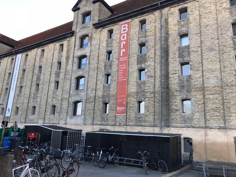 Photogallery






Noma 2.0 is in Christianshavn, the same neighbourhood as the first Noma. They’re 1.5 km apart, a 15 minutes’ walk. This picture shows the distance: to the right, there’s the warehouse of the old location (in Strandgade 93), to the left the smokestacks of Amager Bakke, the futuristic incinerator below which stands the new Noma (in Refshalevej 96)









Weather permitting, you can have a peaceful walk between the previous Noma to today’s Noma 









The new Noma is on an isthmus surrounded by canals. In the future they also want to reclaim some small parts for hydroponic farming









Bucolic scene with incinerator









Bikes left outside Noma. It’s the favourite means of transport among employees and interns









The long path taking you to the restaurant. The fence on the left shows how works are still in progress









On the two sides of the path there are the two new sections of the "Noma village", each with its specialty: grill, hot dishes, snacks, fermentations... In one month’s time, behind the fence we’ll have greenhouses, the test kitchen and the bread making area









To the left, before arriving at the restaurant, the future test kitchen. This will be run by Danish Mette Søberg with Riccardo Canella. "My first challenge?", reveals the latter, for a long time sous chef here, "is to work on the extraction of essential oils" 









The future Test Kitchen









The temporary gangway to the restaurant









Looking from the door to the restaurant, there’s a lake and the smokestacks puffing vapour from the Amager Bakke incinerator. It’s a futuristic project, both in terms of sustainability and architecture. It’s also known as Amager Slope or Copenhill, and its author is starchitect Bjarke Ingels, the same who designed the new Noma. Gradually opened in 2017, it transforms waste into electricity. The goal is to donate electricity to 62500 houses and hot water to 160000. It’s part of an ambitious project to transform Copenhagen into the first city in the world in terms of zero carbon dioxide emissions by 2025. By autumn this year, Amager Slope should open its ski slope, a climbing wall and a hiking track. You’ll be able to slalom on top of the incinerator









The windows from the dining room









Work is still in progress (photo taken on Thursday 22nd February 2018)









Traces of the old building, with barbwire. During WWII, they built bombs here









A view of the dining room at night (photo from Instagram/James Spreadbury)









The entrance to the restaurant









The usual ritual: a welcome from the entire staff, led by Rene Redzepi 









Behind the entrance, there are formaldehyde tanks with creatures from the abyss, shaped as in Damien Hirst’s works. The first image once you’re inside is to reproduce a Scandinavian village









The service kitchen is larger, more spacious and a completely open view from the dining room: "It’s the heart of our Scandinavian village", says Canella. There are 30 cooks working here now. 10 more, compared to the previous Noma









Large skylights above the cooks









There are currently more than 100 people working at Noma, of whom 63 are cooks - 26 employed, and 37 as interns









There’s fire in the kitchen, for the first time









On average, the dining room can host 40 people. "However", complains Redzepi, "there’s always someone who turns up with more people than the ones booked"









While the dining room is set, the outside space still need to be defined









The staff made the dining room decorations. There are no overly expensive designer objects









Dried fish









Seaweeds hanging from the ceiling









Dried octopus heads preserved in salt (with a balloon inside)














Bjarke Ingels and Redzepi’s plan included the wish to recreate a Danish farm









The luminous private dining room









The counter in the dining room. They drew the beams from the canals around the restaurant














The mise en place, bare and strictly without tablecloths









Water jug, candle, flower vase









A warm cloth, to begin with









Australian James Spreadbury, restaurant manager and partner at Noma









Welcome drink: Champagne extra brut Blanc d'Argile from Domaine Vouette et Sorbée









Sea Snail broth. The welcome dish at Noma is, as usual, a hot “soup”









Stefano Ferrano, from Torino, presents the following dish. There’s always a large Italian colony at Noma









Venus clams. Molluscs from Limfjord (Denmark) mixed with decorative clams, typical of Noma. Beside them, shells with blackcurrant oil and “Danish curry”, made with toasted coriander seeds, fennel and fennel seeds









The lid above the following dish. The mussels are not edible









Best of the mussel. Mussels open in a pan with water of fermented barley. «We recreate the mussel», says Canella, «using just the flaps, the best part». The paste is made with scraps from the mussel, cooked in smoked butter









The next dish is conceived and served by Riccardo Canella, the Paduan sous chef who conquered Redzepi, here with dining room intern Feline Hansen









Dried fruits and shrimps. In this case, the heads are not a decoration, but you must suck them –best not eat them because of the bones: they’re filled with a lovely prawn cream. The small crustaceans are still alive when they arrive on a ship straight from the Norwegian fjords









Inside, under the prawn broth skin, there’s fruits and vegetable preserved from the previous summer with raw prawns and gooseberry sauce with blackcurrant oil









How about beverages? There are three options, as usual: wine pairing (6 glasses plus a beer plus sake, 150 euros), juice pairing (juices and extracts, 110 euros) or a choice from the list. They recommend Champagne Chut... Libre from Val'Frison pour Dominique Derain, 50% Pinot Noir, 50% Chardonnay created by a couple who met at the old Noma. Well bodied, it will be a good match throughout the meal









As usual, the wine list starts with Champagne: the cheapest is 1400 crowns (190 euros)









White wines begin with labels from cold climates: first Austria, increasingly popular for its natural wines, then Germany, then all the others









How about Italy? Few names, among the white wines, from North and South









A dozen red/orange wines









Sea star, that is to say Cured trout roe and eggs, the emblem dish of this new era. They recommend moving the teaspoon from the heart to the edges of the tentacles. Aesthetics win over taste









Jellyfish. The jellyfish gel in the middle is in fact a clarified broth of calamari and recalls the texture of jellyfish. "We tried to cook jellyfish in 300 different ways but none was convincing so far". All around, pickled seaweed. The gel is almost tasteless, it serves to clean the palate after the pickles









Rene Redzepi himself presents the content of the first Seafood platter.









French style service with a small plate below for the empty shells









It’s made of two (per two) pieces: queen clam and mahogany clam









The Queen Clam is a very small variety of Norwegian scallop, seasoned with a vegetal reduction made with cucumber and peas miso. The red tip is the coral. "You should eat it using the top shell ", recommends Redzepi









The Mahogany clam is a centennial clam from the North Sea, very popular in Denmark and Iceland. «You can tell the age by the number of rings, like with trees», says Redzepi, «In 2007 they found one that was 450 years old. We’ve had it in the menu for a decade or so». The razor clam shell serves as teaspoon









Inside, there’s obviously not just a bare Mahogany. «We open it when the client arrives», says Canella, «remove the entrails and then slice it so as to preserve its firm texture». It’s seasoned with stir-fried gooseberry, capers of blackcurrants and blackcurrant sprouts preserved in vinegar. The sauce is made with mussel water









A note on the chairs: they’re more minimalistic. They’re no longer covered in sheepskin or leather from other Danish animals, in the style of Noma 1.0. The most significant element is the napkin: if you go to the toilet, they no longer replace it with a new one. There’s the old one, tied to the chair. "This is sustainability", they explain









The second seafood platter. It’s made of Sea cucumber and sour cream in various textures, including «chicharrones» (at 9 o’clock), sea urchins (at 12 and 3) and gigas oyster (at 6)









Sea urchins pressed in fresh cream and pumpkin seeds









Giga Oyster, a huge oyster from the Pacific, quickly steamed and garnished with pickles. Noma only reserved one thousand of these. In the menu until available









The following dish, off the menu, is again from Canella: horse mussel ragout, rare specimen of which 30 arrive at 'Noma each week









They cook the mussel as if it were kidney, in a sort of Bolognese sauce but with ginger. Ginger? "Yes, we’ve decided to include it, as with other spices, after our Mexican experience"









Another Italian presents a dish, Edoardo Fiaschi from Prato, at Noma for 3 years now









Squid in seaweed butter. An almost neglected Danish squid lightly seared in fermented koji oil, rolled and seasoned with seaweed butter and served on sticks of blackcurrant that widen its aromas. Formidable and beautiful









The following dish is inside a nice bee wax container. It’s made with balloons covered multiple times in bee wax. «We spent weeks making them. We’ve made thousands». They’re disposable...









Sea snail and roses. They recommend to: "Eat it keeping the bee wax on your hands "









Sea snail. Another small nibble from the top part of the sea snail, lightly warmed up in water and served on a reduction of lemon thyme









A sea snail toothpick, initially carved by Redzepi himself









Head of the cod, (right), the real main course at Noma









Another rather laborious recipe. «It takes half an hour just to separate the head. We remove the skin, the collagen, we cut mandibles, tongue, cheek and the part behind. We rinse it in water, spices, koji and cook it in the yakitori with a glaze of mushrooms and spiced fennel broth»









You can garnish the cod as you choose, with a paste of ants (top right corner), a slightly spicy emulsion of koji oil, water and horseradish sauce (left) and Danish curry (bottom)









On the side of the cod, there’s also wild garlic seasoned with smoked butter and roasted yeast. Intense flavour









Cod bones after the tasting









An interlocutory snack made of cod cheek









Pickled vegetables and arctic herbs. The only vegetable dish in the menu, marks the passage from savoury to sweet dishes. Between June and August 2018 the menu at Noma will be 100% vegetarian









Preparation time: half an hour! A challenge for the person making it









Mussels appear once again, a classic emblem









This time it’s a dessert in the shape of a small sandwich. Pear and roasted kelp ice cream 









Cloudberries and pinecones. A dessert that continues Redzepi’s saga of unsweet sweets: cloudberries, pinecones preserved in sugar, yogurt snow (by Italian Jessica Natali) and a sea snail made with cloudberry sorbet









Filtered coffee made with stolen kenyoti seeds farmed in Honduras by a Norwegian guy. Italian sommelier Francesca Niro tells us this story. «In Denmark», she says, «coffee is not a final act»









Sugar kelp tart. Tartelletta di alga kelp con pralinato di pino (sul modello di quello di mandorle, autore Canella), panna e crisp di ostrica









Sugar kelp tart. Jessica Natali, 23, from the March, has been at Noma for 4 years now









Natali introduces the last dish, Plankton cake









It’s Redzepi’s tribute to Andalusian chef Angel Leon, the chef who brought the abyss of the sea on fine dining tables. A final trivia fact at the end of the meal: we were never served bread, a historic strongpoint at Noma. "There’s no need for bread in this menu", said Redzepi









With Canella we walk the very long corridor that starts from the opposite side of the room, right after the entrance









It’s the rationalised and enlarged equivalent of the previous Noma’s first floor. Dozens of guys are making the pre-preparations









Canella with Ali Sonko, Noma’s famous kitchen hand from Gambia who then became partner









Sea cucumbers and huge Artic crabs swim in the water tanks














Ants on a shrimp, the emblem of Noma’s pop-up in Tokyo














The new equipment includes a sonicator for emulsions, a Rotovapor, essential oil extractors. Natural extraction, like that of perfumes, is an idea that Canella would like to develop in all possible ways, following the example of Alajmo









Temporary location for wild herbs









The staff area









Final relax in the lounge next to the dining room, much larger and more luminous than the previous one









They give us the bill: a total of 3250 crowns (436 euros), including the 2250 Danish crown menu (302 euros), already paid when booking 3 months ago, 50 crowns for water (6.50 euros), 700 for champagne (half of 1400 crowns, that is to say 190 euros), 175 (23,50) for the welcome Champagne glass and 75 (10 euros) for coffee. Ten percent of the places are reserved for students at a shared table: they pay a special fee of 1000 crowns (134 euros) for the menu including either the wine or juice pairing. For reservations click here






