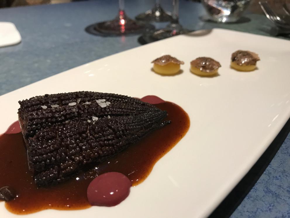 Galleria fotografica






L'inizio di un percorso meraviglioso: Lengua helada de pasión con ron, ossia una lingua di gatto gelata al rum, frutto della passione e menta piperita. Inizia il gioco di temperature









Rosa & lichis: poesia pura. Sferificazioni di acqua di rose (sui petali laterali) e finta mora ghiacciata di lichi









La remolacha que sale de tierra: insieme sorbetto e meringa di barbabietola









Panchino relleno de caviar beluga: uno dei piatti signature del Disfrutar. Si prepara una pasta per brioche con molta acqua e lievito. Viene collocata in un sifone e si ottiene una schiuma. Quindi si riempie il fondo di uno stampo circolare con questa schiuma, si aggiunge il caviale e una crema doppia panna, quindi ancora schiuma per coprire il tutto. Si immerge in una padella con olio a 180 gradi per 20 secondi. Ovviamente il caviale può essere sostituito da formaggi, tonno, sorbetti...









La preparazione al tavolo del Sidra casera ahumada al momento, un sidro di mele istantaneo: si versa sul ghiaccio secco una mistura di liquore e succo di mela e si lascia agire









Inizia il tributo alle noci. Qui il gheriglio, ricostruito, custodisce un quarto di noce, affumicata. E deliziosa. In pratica il guscio è stato aperto, senza romperlo; la noce è stata affumicata, poi rimessa al suo posto, il tutto richiuso









Ancora Cáscara de nuez: qui è un tripudio. Una noce tenera, senza pelle, l'altra verde col gheriglio e resa commestibile, infine l'ultima cotta e macerata nel ratafià, come abbiamo già spiegato nel pezzo. Il tutto con un filo di latte di noce e di olio di frutta secca. L'idea è: con un prodotto possiamo costruire all'infinito









Candy salado de nueces con mango, haba tonka y whisky: la bustina commestibile contiene caramello salato e noci, quindi il mango crudo e il profumo del whisky affumicato









Milhojas de idiazábal, millefoglie di idiazábal, un formaggio basco. Sterzata salata dopo una prima parte di degustazione in cui prevalevano le note dolci (a esaltare anche il caviale del Panchino). In generale, sono tutti piatti che superano la tradizionale distinzione dolce/salato









"Hostia" de flor del mandarino: la finta ostia è di ovulato, racchiude essenza di fiore di mandarino. Un piatto che colpisce il cuore









La Gilda del Disfrutar. La gilda è il classico pincho che si serve nei Paesi Baschi, a base di olive e acciughe. Qui abbiamo le celebri false olive di Adrià, croccanti fuori (burro di cacao) e liquide all'interno. Poi sgombro marinato, semi di pepe basco e la loro crema









Sandwich de gazpacho con guarnición olorosa de vinagre de Jerez: qui il falso pane ghiacciato (sono meringhe di pomodoro secco) racchiude una farcitura in cui emergono le note acide e aromatiche dell'aceto di Jerez a esaltare il classico aroma del gazpacho andaluso









Almendras "supertiernas" en vinagreta: al Disfrutar giocano molto con la frutta secca, qui mandorle ammorbidite o croccanti e accompagnate da aromi di vaniglia, aglio, olio, vinaigrette... Altro capolavoro









Yema de huevo crujiente con gelatina caliente de setas: una crema d'uovo in tempura, croccante fuori e liquida dentro, sopra un gel di funghi racchiuso nel guscio dell'uovo stesso. «Per noi è un classico - ci dicono - Ma sempre molto difficile da gestire»









Piatto spettacolare e gentile, Tatin de foie-gras y maíz multiesférico: tutto giocato su un equilibrio in cui le note dolci sono spinte al limite. La tecnica è quella della multisferificazione, con gel di glutammato a chiudere la partita









Ceviche en deconstrucción: leche de tigre, emulsione di pesce, olio di coriandolo e sorbetto di zucca e ajì. Un classico del Disfrutar

 









Questa è la cartilagine del muso del salmone...









...protagonista di quest'altro piatto, nuovissimo: il collagene del muso del salmone con le sue uova e salsa di acetosella. Wow!









Altra novità, presentata a Gastronomika, è la Costilla de salmón con mojo di estragón. Le costolette di salmone, ottenute una a una sfilettando con attenzione le lische con la polpa attorno, sono accompagnate da mojo di dragoncello e uova di salmone









Conserva de navajas a la sal: le navajas sono state lasciate macerare per un giorno con alghe nel frigorifero, poi 5 minuti al forno. Sono molluschi chiamati "guscio rasoio", tassonomicamente Ensis arcuatus, simili ai cannolicchi. Qui con olio e aceto di Jerez 25 anni









Ensalada líquida, non serve traduzione...









...accompagnata da Polvorón de tomate y caviaroli de arbequina. Il polvorón è un classico dolce spagnolo di Natale, molto friabile, in genere fatto di farina, zucchero, latte e mandorle. Qui è di pomodoro e accompagnato da caviaroli di oliva arbequina: il Caviaroli è di una ditta catalana che sferifica varie tipologie di olio evo, anche aromatizzato, ce n'è anche una a base di tartufo Tartuflanghe









Tre piatti che raccontano il suquet, tipica salsa a base di pesce. Qui Noodles de espardeñas (le rare “lingue di mare”, in tassonomia stichopus regalis) en suquet









Langostino (ossia gamberone) en suquet, con gnocchi di patata, aria di prezzemolo, crema di zafferano e patata. Sul fondo si vede anche il Capucchino de suquet









Finale salato a base di piccione: qui il suo consommé con armagnac, dragoncello e arancia









Bombon di piccione e foie e foglia d'argento









Laksa de pichón. La laksa è una popolare zuppa di Singapore, speziata, con cocco, lime e citronella. Qui ccon riduzione di piccione e fideuà






