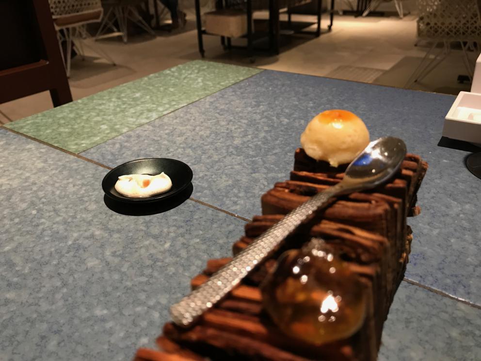 Galleria fotografica






L'inizio di un percorso meraviglioso: Lengua helada de pasión con ron, ossia una lingua di gatto gelata al rum, frutto della passione e menta piperita. Inizia il gioco di temperature









Rosa & lichis: poesia pura. Sferificazioni di acqua di rose (sui petali laterali) e finta mora ghiacciata di lichi









La remolacha que sale de tierra: insieme sorbetto e meringa di barbabietola









Panchino relleno de caviar beluga: uno dei piatti signature del Disfrutar. Si prepara una pasta per brioche con molta acqua e lievito. Viene collocata in un sifone e si ottiene una schiuma. Quindi si riempie il fondo di uno stampo circolare con questa schiuma, si aggiunge il caviale e una crema doppia panna, quindi ancora schiuma per coprire il tutto. Si immerge in una padella con olio a 180 gradi per 20 secondi. Ovviamente il caviale può essere sostituito da formaggi, tonno, sorbetti...









La preparazione al tavolo del Sidra casera ahumada al momento, un sidro di mele istantaneo: si versa sul ghiaccio secco una mistura di liquore e succo di mela e si lascia agire









Inizia il tributo alle noci. Qui il gheriglio, ricostruito, custodisce un quarto di noce, affumicata. E deliziosa. In pratica il guscio è stato aperto, senza romperlo; la noce è stata affumicata, poi rimessa al suo posto, il tutto richiuso









Ancora Cáscara de nuez: qui è un tripudio. Una noce tenera, senza pelle, l'altra verde col gheriglio e resa commestibile, infine l'ultima cotta e macerata nel ratafià, come abbiamo già spiegato nel pezzo. Il tutto con un filo di latte di noce e di olio di frutta secca. L'idea è: con un prodotto possiamo costruire all'infinito









Candy salado de nueces con mango, haba tonka y whisky: la bustina commestibile contiene caramello salato e noci, quindi il mango crudo e il profumo del whisky affumicato









Milhojas de idiazábal, millefoglie di idiazábal, un formaggio basco. Sterzata salata dopo una prima parte di degustazione in cui prevalevano le note dolci (a esaltare anche il caviale del Panchino). In generale, sono tutti piatti che superano la tradizionale distinzione dolce/salato









"Hostia" de flor del mandarino: la finta ostia è di ovulato, racchiude essenza di fiore di mandarino. Un piatto che colpisce il cuore









La Gilda del Disfrutar. La gilda è il classico pincho che si serve nei Paesi Baschi, a base di olive e acciughe. Qui abbiamo le celebri false olive di Adrià, croccanti fuori (burro di cacao) e liquide all'interno. Poi sgombro marinato, semi di pepe basco e la loro crema









Sandwich de gazpacho con guarnición olorosa de vinagre de Jerez: qui il falso pane ghiacciato (sono meringhe di pomodoro secco) racchiude una farcitura in cui emergono le note acide e aromatiche dell'aceto di Jerez a esaltare il classico aroma del gazpacho andaluso









Almendras "supertiernas" en vinagreta: al Disfrutar giocano molto con la frutta secca, qui mandorle ammorbidite o croccanti e accompagnate da aromi di vaniglia, aglio, olio, vinaigrette... Altro capolavoro









Yema de huevo crujiente con gelatina caliente de setas: una crema d'uovo in tempura, croccante fuori e liquida dentro, sopra un gel di funghi racchiuso nel guscio dell'uovo stesso. «Per noi è un classico - ci dicono - Ma sempre molto difficile da gestire»









Piatto spettacolare e gentile, Tatin de foie-gras y maíz multiesférico: tutto giocato su un equilibrio in cui le note dolci sono spinte al limite. La tecnica è quella della multisferificazione, con gel di glutammato a chiudere la partita









Ceviche en deconstrucción: leche de tigre, emulsione di pesce, olio di coriandolo e sorbetto di zucca e ajì. Un classico del Disfrutar

 









Questa è la cartilagine del muso del salmone...









...protagonista di quest'altro piatto, nuovissimo: il collagene del muso del salmone con le sue uova e salsa di acetosella. Wow!









Altra novità, presentata a Gastronomika, è la Costilla de salmón con mojo di estragón. Le costolette di salmone, ottenute una a una sfilettando con attenzione le lische con la polpa attorno, sono accompagnate da mojo di dragoncello e uova di salmone









Conserva de navajas a la sal: le navajas sono state lasciate macerare per un giorno con alghe nel frigorifero, poi 5 minuti al forno. Sono molluschi chiamati "guscio rasoio", tassonomicamente Ensis arcuatus, simili ai cannolicchi. Qui con olio e aceto di Jerez 25 anni









Ensalada líquida, non serve traduzione...









...accompagnata da Polvorón de tomate y caviaroli de arbequina. Il polvorón è un classico dolce spagnolo di Natale, molto friabile, in genere fatto di farina, zucchero, latte e mandorle. Qui è di pomodoro e accompagnato da caviaroli di oliva arbequina: il Caviaroli è di una ditta catalana che sferifica varie tipologie di olio evo, anche aromatizzato, ce n'è anche una a base di tartufo Tartuflanghe









Tre piatti che raccontano il suquet, tipica salsa a base di pesce. Qui Noodles de espardeñas (le rare “lingue di mare”, in tassonomia stichopus regalis) en suquet









Langostino (ossia gamberone) en suquet, con gnocchi di patata, aria di prezzemolo, crema di zafferano e patata. Sul fondo si vede anche il Capucchino de suquet









Finale salato a base di piccione: qui il suo consommé con armagnac, dragoncello e arancia









Bombon di piccione e foie e foglia d'argento









Laksa de pichón. La laksa è una popolare zuppa di Singapore, speziata, con cocco, lime e citronella. Qui ccon riduzione di piccione e fideuà









Pichón Pibil con abrigo de màiz y trufa de verano: il pibil è una cottura tradizionale maya, sotto la cenere. Il piccione è coperto da un "cappotto" nero (abrigo) di mais e accompagnato da tartufo









La parte dolce-dolce inizia col Pandan, «l'idea viene dalla Malaysia»: sorbetto di mango con caviale di mango, spugna e infusione di pandan (una pianta asiatica dalla quale si ricavano foglie aromatiche) e cocco









Cornete de sésamo negro









Cerezas 2017. Ciliegie con la stessa tecnica delle olive






