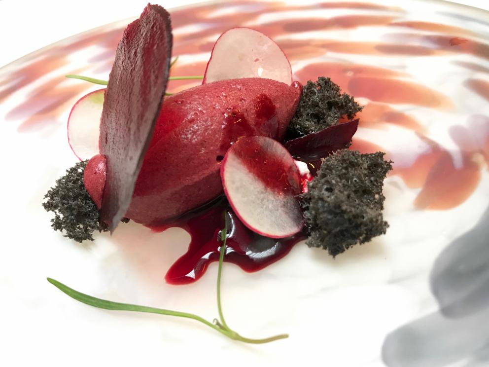 Galleria fotografica






La mappa storico-gastronomica che concettualizza la proposta del Sucede









Il nostro pranzo al Sucede. Si inizia con El huevo y la manzana, ossia uovo e mela, due elementi tipici dei Saturnali romani









Uva gasificada, ossia uva gassata. Si accompagna col latino mursum, un succo d'uva fermentato, non alcolico, con miele (qui aria di miele)









Inizia il banchetto romano vero e proprio. Dentelle de salazones, un cracker di uova di riccio di mare in salagione, più erbe e fiori. Buonissimo. Il dentelle è il merletto









La fritura de la sardina. la sardina è fritta senza olio, nel mannitolo









Mejillón ojimiel, ossia cozza con aceto e miele









Delizioso il Pan de higos, pane di fichi con trota e caviale di trota, a parte









Ostra con holandesa de garum, ostrica con salsa olandese di garum. Piatto elegantissimo









Merengue de erizo, meringa di ricci di mare









Si compone così il banchetto romano









Parte una sorta di focus sull'anguilla e i ceci. Qui uno snack, Pieles de garbanzo, ossia pelle di ceci









Infusión de anguila y garbanzo, infusione di anguilla e ceci









Ottima la Tartaleta de anguila, tartelletta di ceci verdi con anguilla e sferificazione di Merlot









Anguila al azafrán, ossia filetto di anguilla con zafferano e schiuma di agrumi









Anguila y garbanzo verde, ossia una stratosferica crema di anguilla e ceci verdi, non secchi









Tartaleta de tuétano, ossia tortino di midollo, un cracker di noci macadamia con midollo grattugiato e frutti rossi









Tuétano silvestre, midollo selvaggio: un flan di midollo con tartufo, funghi e crema di castagne









Altro passaggio, Cartílago, trufa y altramuces, ossia cartilagine, tartufo e lupino. La cartilagine è di maiale, c'è la sua demi-glace, poi lupini e sferificazione di tartufo
 









Liebre y encurtidos, lepre e sottaceti: un bel filetto di lepre con melanzane e cipolle sottaceto, sfere di olio e crema di aglio nero









Paloma con pistachos, colomba con pistacchi: gran piatto, i pistacchi sono in tre texture (cotti in crema, crudi e pralinati). Forti note tostate, anche in questo caso si gioca sul superamento delle barriere tra dolce e salato, come nei piatti precedenti









Consomé de tórtola e Tórtola al romero, quindi consommé di tortora e tortora affumicata al rosmarino. Piatto perfetto, goloso, elegante, di grandissima classe









Inzia la parte araba del menu, con Agua de dátil y rosas, acqua di datteri e rose. Richiama il carcadè che veniva offerto in segno di benvenuto









Flor de hibiscus, fiore di ibisco, con polpa di barbabietola e broccoli









Vol au vent de hibiscus y lentejas, vol au vent di ibisco, crema di lenticchie e raviolo di miele









Lentejas caviar y caracoles, ossia lenticchie, una sfera di brodo di lenticchie e caviale di lumaca. Buonissimo









A parte, un Consommé di lumaca









Ñoquis de berenjena, gnocchi di melanzana con yogurt, cous cous di erbe, sfere di yogurt alla curcuma









Brocheta de cordero a la naranja, spiedino di agnello all'arancia









Tutta la parte dedicata al coniglio è di bontà clamorosa. Qui Oreja de conejo, orecchie di coniglio croccanti









Conejo mi-cuit, mi-cuit di fegato di coniglio









Forse il piatto più strepitoso, Lenguas de conejo, ossia lingue di coniglio (ma anche il suo cervello) con membrana di melone









Conejo melón, un brodo di coniglio e melone con pinoli e olive. Gran livello









Riñón de conejo, rognoncini di coniglio su foglie di cardamomo e melone









Altra sezione: arriva al tavolo questa cosa, che è una lingua di vitello salata, stagionata e affumicata, come fosse un katsuobushi









Una fetta di lingua di vitello-katsuobushi finisce su una bistecca di vitello (invero un po' poco frollata): Ternera y lengua









Arroz del Mediterráneo, il riso del Mediterraneo, un riso fermentato con miele: assomiglia a un formaggio fresco di capra. È a tutti gli effetti il "formaggio" che chiude la parte salata









Agua de calabaza asada, acqua di zucca tostata (richiama l'arnadì, un dolce arabo-valenciano con miele e zucca)









Merengue de calabaza, meringa di crema di zucca e pinoli, appunto una reintepretazione dell'arnadì









Zanahoria y mandarina, cialda di carota e sorbetto di mandarino, con pane di yogurt






