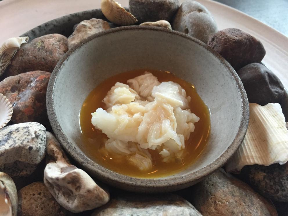 Photogallery






The traditional welcome at Noma: the chefs from the service kitchen greet the guests. In the middle, Italian Riccardo Canella, who will help us describing the last menu in detail (photo gallery by Luca Iaccarino and Gabriele Zanatta)









Warm broth of cloudberries. It’s the last welcome dish at Noma. It’s cold outside but as soon as you sit inside, you get warm thanks to this hot broth made with cloudberries enriched with rhubarb root oil. You dip a bouquet of hay, lemon thyme and mountain pine. Corroborating









Riccardo Canella brings a preview of what will follow









It’s a dish with seafood, including a huge (and alive) king crab, sea urchins and oysters









Apple of the season









Apple of the season. Once you open the shell, many small apple parisienne appear in a juice made with centrifuged, clarified apple scraps, seasoned with verbena and thyme. There’s also a purée of apples fermented in broth. The dish is finished with oxalis flowers, tagete and oil of blackcurrant wood, made by beating the blackcurrant branches with a hammer, so as to extract their essential oils. A very pleasant dish despite its complex idea.

"The first time I saw it ", added Canella, "I was struck because it reminded me of the stuffed apples they used to make at restaurant Bulesca in Selvazzano, Padua, in the early Eighties. Except in that case it was filled with rolls made with granny smith apple and prosciutto from Montagnana" 









Fresh sliced scallop. It’s a scallop taken from the fish tank and shelled a few moments before serving it. It is then sliced, brushed with a reduction of vegetable whipped butter with cucumber centrifuge juice, then reduced, and piso broth (that is to say miso with dehydrated peas).

The technique is the same used for the broth ice-clarification made famous in the Nineties by Heston Blumenthal at Fat Duck: you freeze the broth then hang a table cloth so as to obtain the “pure” part of the liquid. A trick that adds the same satisfying sensation of a meat jus to a vegetable broth. The scallop is finally dipped into a classic mussel broth. An incredible mouthful of seafood and umami









A Winter Platter. Hidden among the leaves, are four edible tastings









He sums up in just one dish 4 snacks that he might would have served separately a few years back. A fun and tasty idea. In detail:

At 6 o’clock: Pear pressed in fermented red gooseberry with fully ripe common sea buckthorn. It’s a rather tart ensemble made sweeter by piso (again miso made with dried peas) seasoned with coriander seeds (supplied by Redzepi’s historic supplier Soren Wiuff). The external thinner leaf is a peel made with chicken broth and beech leaves preserved in vinegar.

10 o'clock: crispy black currant leaf-shaped sandwich, seasoned with yogurt, kombucha, elderberry flowers and red oxalis 

12 o'clock: malt branch with nasturtium leaves, creme fraiche, salt aromatised with pine and ants

4 o'clock: black garlic leaf with salt aromatised with kelp, a Japanese seaweed 









A detail of the malt branch, with well visible ants. At Noma, the study of the aromatic contribution given by formic acid to dishes continues. And even the service acquires elegance: in the past you might have seen ants floating in a few dishes. This is no longer the case









A Tupperware from the "ant library", on the first floor at Strangade









Radish pie. It’s an emblem of the latest menus at Noma. It’s been in the menu for almost a year. In the crunchy disc on the bottom there’s kelp seaweed and a vegetable reduction made with coriander pesto. The radish roses (22, no more, no less) were pressed in beetroot juice. Another formidable tasting









Interns roll the radish roses together, on the top floor at Noma. Loud music and teamwork help making the job less alienating









Natural fermented bread of Øland wheat and hulless barley.  Øland wheat is Danish, with 83% hydration. “Nerd” bread maker Rasmus Kristensen is obsessed with it: even though it could last a week, he bakes it fresh every day for the two services (see the interview on Vice). It has a crispy yet soft crust, and it’s a great progress compared to the early bread making at the restaurant.

The salted butter is instead Norwegian Røros, according to some “the best butter in the world”. One of the most extraordinary pairings ever tasted. We asked for an encore









Cooked oyster and broccoli stems. The oyster is blanched for two minutes and placed on a shell with the edges powdered with salicornia. Between the broccoli and the oyster there are some diced stalks of sorrel. There’s a reduction with kelp seaweed, whisked with butter, thyme and “capers” made with white currants [they’re not real capers but the currants are preserved for a year in 2% salt, like capers). The sauce for the oyster is made with white gooseberries. An artwork, but less convincing than the other tastings









Sea urchin and cabbage. It’s a cabbage leaf pressed with hazelnut oil, filled with sea urchin roe and seasoned with pine vinegar, water from fermented porcini and pickled chanterelle mushrooms. On top, there’s parsley pesto and salt aromatised with pine. It’s a dish that changes greatly according to the season: compared to September, the leaves are now smaller and woodier. Two extraordinary mouthfuls, the result of a rather simple intuition









Sea urchin and cabbage, a detail. Northern sea urchins are creamier than Italian ones. A blast









Langoustine, onion and lavender. The langoustine is the precious one from the Far Oer Islands. The onion is Danish and grilled, steamed in a vacuum bag with Koji oil (blended rapeseed oil with fermented oil) and then grilled again, only slightly, so as to get a golden nuance. The langoustine is instead cooked in its shell, seared in butter at 60°C for 2 minutes, then peeled, cut and served. Rose oil, vinegar made with lovage sprouts and dried lavender complete the picture. The dish is focused on the sweetness given by the onion, which has a similar texture to the langoustine. Very nice









Butternut squash, barley and caviar. The butternut squash is confit in oil aromatised with seaweeds later roasted and placed on top. It is completed with beechnuts, a sauce made with fermented barley and butter and a handful of Finnish caviar. A sweet interlude









Claws and heads of a langoustine from the Far Oer Islands, cut in two. The heads of the langoustine are braised with a paste made with the entrails of the langoustine and a reduction of yeast and thyme and lemon on top. A very pleasing neo-primitive tasting with a strong dose of umami









Steamed king crab and egg yolk sauce. A new take on a classic Japanese dish, learnt in Tokyo and applied in Australia to a snow crab. Global nomadism made Redzepi’s cuisine rounder, less extreme than in the past






