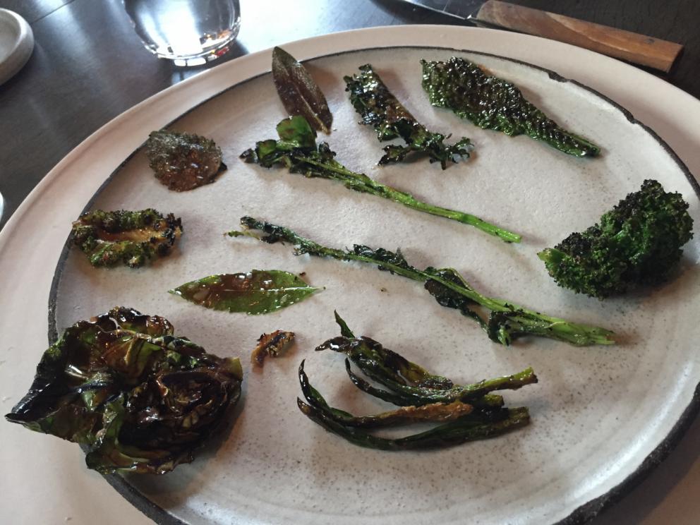 Photogallery






The traditional welcome at Noma: the chefs from the service kitchen greet the guests. In the middle, Italian Riccardo Canella, who will help us describing the last menu in detail (photo gallery by Luca Iaccarino and Gabriele Zanatta)









Warm broth of cloudberries. It’s the last welcome dish at Noma. It’s cold outside but as soon as you sit inside, you get warm thanks to this hot broth made with cloudberries enriched with rhubarb root oil. You dip a bouquet of hay, lemon thyme and mountain pine. Corroborating









Riccardo Canella brings a preview of what will follow









It’s a dish with seafood, including a huge (and alive) king crab, sea urchins and oysters









Apple of the season









Apple of the season. Once you open the shell, many small apple parisienne appear in a juice made with centrifuged, clarified apple scraps, seasoned with verbena and thyme. There’s also a purée of apples fermented in broth. The dish is finished with oxalis flowers, tagete and oil of blackcurrant wood, made by beating the blackcurrant branches with a hammer, so as to extract their essential oils. A very pleasant dish despite its complex idea.

"The first time I saw it ", added Canella, "I was struck because it reminded me of the stuffed apples they used to make at restaurant Bulesca in Selvazzano, Padua, in the early Eighties. Except in that case it was filled with rolls made with granny smith apple and prosciutto from Montagnana" 









Fresh sliced scallop. It’s a scallop taken from the fish tank and shelled a few moments before serving it. It is then sliced, brushed with a reduction of vegetable whipped butter with cucumber centrifuge juice, then reduced, and piso broth (that is to say miso with dehydrated peas).

The technique is the same used for the broth ice-clarification made famous in the Nineties by Heston Blumenthal at Fat Duck: you freeze the broth then hang a table cloth so as to obtain the “pure” part of the liquid. A trick that adds the same satisfying sensation of a meat jus to a vegetable broth. The scallop is finally dipped into a classic mussel broth. An incredible mouthful of seafood and umami









A Winter Platter. Hidden among the leaves, are four edible tastings









He sums up in just one dish 4 snacks that he might would have served separately a few years back. A fun and tasty idea. In detail:

At 6 o’clock: Pear pressed in fermented red gooseberry with fully ripe common sea buckthorn. It’s a rather tart ensemble made sweeter by piso (again miso made with dried peas) seasoned with coriander seeds (supplied by Redzepi’s historic supplier Soren Wiuff). The external thinner leaf is a peel made with chicken broth and beech leaves preserved in vinegar.

10 o'clock: crispy black currant leaf-shaped sandwich, seasoned with yogurt, kombucha, elderberry flowers and red oxalis 

12 o'clock: malt branch with nasturtium leaves, creme fraiche, salt aromatised with pine and ants

4 o'clock: black garlic leaf with salt aromatised with kelp, a Japanese seaweed 









A detail of the malt branch, with well visible ants. At Noma, the study of the aromatic contribution given by formic acid to dishes continues. And even the service acquires elegance: in the past you might have seen ants floating in a few dishes. This is no longer the case









A Tupperware from the "ant library", on the first floor at Strangade









Radish pie. It’s an emblem of the latest menus at Noma. It’s been in the menu for almost a year. In the crunchy disc on the bottom there’s kelp seaweed and a vegetable reduction made with coriander pesto. The radish roses (22, no more, no less) were pressed in beetroot juice. Another formidable tasting









Interns roll the radish roses together, on the top floor at Noma. Loud music and teamwork help making the job less alienating









Natural fermented bread of Øland wheat and hulless barley.  Øland wheat is Danish, with 83% hydration. “Nerd” bread maker Rasmus Kristensen is obsessed with it: even though it could last a week, he bakes it fresh every day for the two services (see the interview on Vice). It has a crispy yet soft crust, and it’s a great progress compared to the early bread making at the restaurant.

The salted butter is instead Norwegian Røros, according to some “the best butter in the world”. One of the most extraordinary pairings ever tasted. We asked for an encore









Cooked oyster and broccoli stems. The oyster is blanched for two minutes and placed on a shell with the edges powdered with salicornia. Between the broccoli and the oyster there are some diced stalks of sorrel. There’s a reduction with kelp seaweed, whisked with butter, thyme and “capers” made with white currants [they’re not real capers but the currants are preserved for a year in 2% salt, like capers). The sauce for the oyster is made with white gooseberries. An artwork, but less convincing than the other tastings









Sea urchin and cabbage. It’s a cabbage leaf pressed with hazelnut oil, filled with sea urchin roe and seasoned with pine vinegar, water from fermented porcini and pickled chanterelle mushrooms. On top, there’s parsley pesto and salt aromatised with pine. It’s a dish that changes greatly according to the season: compared to September, the leaves are now smaller and woodier. Two extraordinary mouthfuls, the result of a rather simple intuition









Sea urchin and cabbage, a detail. Northern sea urchins are creamier than Italian ones. A blast









Langoustine, onion and lavender. The langoustine is the precious one from the Far Oer Islands. The onion is Danish and grilled, steamed in a vacuum bag with Koji oil (blended rapeseed oil with fermented oil) and then grilled again, only slightly, so as to get a golden nuance. The langoustine is instead cooked in its shell, seared in butter at 60°C for 2 minutes, then peeled, cut and served. Rose oil, vinegar made with lovage sprouts and dried lavender complete the picture. The dish is focused on the sweetness given by the onion, which has a similar texture to the langoustine. Very nice









Butternut squash, barley and caviar. The butternut squash is confit in oil aromatised with seaweeds later roasted and placed on top. It is completed with beechnuts, a sauce made with fermented barley and butter and a handful of Finnish caviar. A sweet interlude









Claws and heads of a langoustine from the Far Oer Islands, cut in two. The heads of the langoustine are braised with a paste made with the entrails of the langoustine and a reduction of yeast and thyme and lemon on top. A very pleasing neo-primitive tasting with a strong dose of umami









Steamed king crab and egg yolk sauce. A new take on a classic Japanese dish, learnt in Tokyo and applied in Australia to a snow crab. Global nomadism made Redzepi’s cuisine rounder, less extreme than in the past









In this case, the king crab is steamed and seasoned with smoked salt. The sauce is made with egg yolks marinated in beef garum, a trick that gives a significant sour component to the recipe. Finally, there’s a seasoning made of butter and piso. An interesting depth






