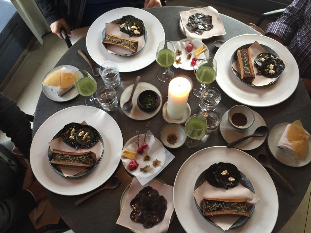 Photogallery






The traditional welcome at Noma: the chefs from the service kitchen greet the guests. In the middle, Italian Riccardo Canella, who will help us describing the last menu in detail (photo gallery by Luca Iaccarino and Gabriele Zanatta)









Warm broth of cloudberries. It’s the last welcome dish at Noma. It’s cold outside but as soon as you sit inside, you get warm thanks to this hot broth made with cloudberries enriched with rhubarb root oil. You dip a bouquet of hay, lemon thyme and mountain pine. Corroborating









Riccardo Canella brings a preview of what will follow









It’s a dish with seafood, including a huge (and alive) king crab, sea urchins and oysters









Apple of the season









Apple of the season. Once you open the shell, many small apple parisienne appear in a juice made with centrifuged, clarified apple scraps, seasoned with verbena and thyme. There’s also a purée of apples fermented in broth. The dish is finished with oxalis flowers, tagete and oil of blackcurrant wood, made by beating the blackcurrant branches with a hammer, so as to extract their essential oils. A very pleasant dish despite its complex idea.

"The first time I saw it ", added Canella, "I was struck because it reminded me of the stuffed apples they used to make at restaurant Bulesca in Selvazzano, Padua, in the early Eighties. Except in that case it was filled with rolls made with granny smith apple and prosciutto from Montagnana" 









Fresh sliced scallop. It’s a scallop taken from the fish tank and shelled a few moments before serving it. It is then sliced, brushed with a reduction of vegetable whipped butter with cucumber centrifuge juice, then reduced, and piso broth (that is to say miso with dehydrated peas).

The technique is the same used for the broth ice-clarification made famous in the Nineties by Heston Blumenthal at Fat Duck: you freeze the broth then hang a table cloth so as to obtain the “pure” part of the liquid. A trick that adds the same satisfying sensation of a meat jus to a vegetable broth. The scallop is finally dipped into a classic mussel broth. An incredible mouthful of seafood and umami









A Winter Platter. Hidden among the leaves, are four edible tastings









He sums up in just one dish 4 snacks that he might would have served separately a few years back. A fun and tasty idea. In detail:

At 6 o’clock: Pear pressed in fermented red gooseberry with fully ripe common sea buckthorn. It’s a rather tart ensemble made sweeter by piso (again miso made with dried peas) seasoned with coriander seeds (supplied by Redzepi’s historic supplier Soren Wiuff). The external thinner leaf is a peel made with chicken broth and beech leaves preserved in vinegar.

10 o'clock: crispy black currant leaf-shaped sandwich, seasoned with yogurt, kombucha, elderberry flowers and red oxalis 

12 o'clock: malt branch with nasturtium leaves, creme fraiche, salt aromatised with pine and ants

4 o'clock: black garlic leaf with salt aromatised with kelp, a Japanese seaweed 









A detail of the malt branch, with well visible ants. At Noma, the study of the aromatic contribution given by formic acid to dishes continues. And even the service acquires elegance: in the past you might have seen ants floating in a few dishes. This is no longer the case









A Tupperware from the "ant library", on the first floor at Strangade









Radish pie. It’s an emblem of the latest menus at Noma. It’s been in the menu for almost a year. In the crunchy disc on the bottom there’s kelp seaweed and a vegetable reduction made with coriander pesto. The radish roses (22, no more, no less) were pressed in beetroot juice. Another formidable tasting









Interns roll the radish roses together, on the top floor at Noma. Loud music and teamwork help making the job less alienating









Natural fermented bread of Øland wheat and hulless barley.  Øland wheat is Danish, with 83% hydration. “Nerd” bread maker Rasmus Kristensen is obsessed with it: even though it could last a week, he bakes it fresh every day for the two services (see the interview on Vice). It has a crispy yet soft crust, and it’s a great progress compared to the early bread making at the restaurant.

The salted butter is instead Norwegian Røros, according to some “the best butter in the world”. One of the most extraordinary pairings ever tasted. We asked for an encore









Cooked oyster and broccoli stems. The oyster is blanched for two minutes and placed on a shell with the edges powdered with salicornia. Between the broccoli and the oyster there are some diced stalks of sorrel. There’s a reduction with kelp seaweed, whisked with butter, thyme and “capers” made with white currants [they’re not real capers but the currants are preserved for a year in 2% salt, like capers). The sauce for the oyster is made with white gooseberries. An artwork, but less convincing than the other tastings









Sea urchin and cabbage. It’s a cabbage leaf pressed with hazelnut oil, filled with sea urchin roe and seasoned with pine vinegar, water from fermented porcini and pickled chanterelle mushrooms. On top, there’s parsley pesto and salt aromatised with pine. It’s a dish that changes greatly according to the season: compared to September, the leaves are now smaller and woodier. Two extraordinary mouthfuls, the result of a rather simple intuition









Sea urchin and cabbage, a detail. Northern sea urchins are creamier than Italian ones. A blast









Langoustine, onion and lavender. The langoustine is the precious one from the Far Oer Islands. The onion is Danish and grilled, steamed in a vacuum bag with Koji oil (blended rapeseed oil with fermented oil) and then grilled again, only slightly, so as to get a golden nuance. The langoustine is instead cooked in its shell, seared in butter at 60°C for 2 minutes, then peeled, cut and served. Rose oil, vinegar made with lovage sprouts and dried lavender complete the picture. The dish is focused on the sweetness given by the onion, which has a similar texture to the langoustine. Very nice









Butternut squash, barley and caviar. The butternut squash is confit in oil aromatised with seaweeds later roasted and placed on top. It is completed with beechnuts, a sauce made with fermented barley and butter and a handful of Finnish caviar. A sweet interlude









Claws and heads of a langoustine from the Far Oer Islands, cut in two. The heads of the langoustine are braised with a paste made with the entrails of the langoustine and a reduction of yeast and thyme and lemon on top. A very pleasing neo-primitive tasting with a strong dose of umami









Steamed king crab and egg yolk sauce. A new take on a classic Japanese dish, learnt in Tokyo and applied in Australia to a snow crab. Global nomadism made Redzepi’s cuisine rounder, less extreme than in the past









In this case, the king crab is steamed and seasoned with smoked salt. The sauce is made with egg yolks marinated in beef garum, a trick that gives a significant sour component to the recipe. Finally, there’s a seasoning made of butter and piso. An interesting depth









Charred greens with a scallop paste. There are plenty of seasonal herbs and vegetables, in this case cabbage, black cabbage, sage, verbena, nettle and the first sprouts of wild garlic. The caramel is made with a purée of fresh scallop, rolled out for 48 hours on a silpat. Once dehydrated, it becomes dark orange. They then blend it, powder it, mix it with bees’ wax and rapeseed oil. Finally they cover the caramel with horseradish juice. Another interlocutory tasting, fun and very much appreciated thanks to the crispiness and the bitter-sweet herbs. Trivia fact: the dish is served with a steak knife. That is to say: herb is the new meat






