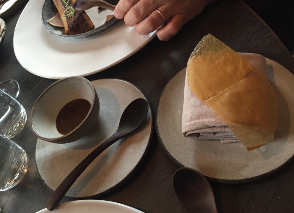 Photogallery






The traditional welcome at Noma: the chefs from the service kitchen greet the guests. In the middle, Italian Riccardo Canella, who will help us describing the last menu in detail (photo gallery by Luca Iaccarino and Gabriele Zanatta)









Warm broth of cloudberries. It’s the last welcome dish at Noma. It’s cold outside but as soon as you sit inside, you get warm thanks to this hot broth made with cloudberries enriched with rhubarb root oil. You dip a bouquet of hay, lemon thyme and mountain pine. Corroborating









Riccardo Canella brings a preview of what will follow









It’s a dish with seafood, including a huge (and alive) king crab, sea urchins and oysters









Apple of the season









Apple of the season. Once you open the shell, many small apple parisienne appear in a juice made with centrifuged, clarified apple scraps, seasoned with verbena and thyme. There’s also a purée of apples fermented in broth. The dish is finished with oxalis flowers, tagete and oil of blackcurrant wood, made by beating the blackcurrant branches with a hammer, so as to extract their essential oils. A very pleasant dish despite its complex idea.

"The first time I saw it ", added Canella, "I was struck because it reminded me of the stuffed apples they used to make at restaurant Bulesca in Selvazzano, Padua, in the early Eighties. Except in that case it was filled with rolls made with granny smith apple and prosciutto from Montagnana" 









Fresh sliced scallop. It’s a scallop taken from the fish tank and shelled a few moments before serving it. It is then sliced, brushed with a reduction of vegetable whipped butter with cucumber centrifuge juice, then reduced, and piso broth (that is to say miso with dehydrated peas).

The technique is the same used for the broth ice-clarification made famous in the Nineties by Heston Blumenthal at Fat Duck: you freeze the broth then hang a table cloth so as to obtain the “pure” part of the liquid. A trick that adds the same satisfying sensation of a meat jus to a vegetable broth. The scallop is finally dipped into a classic mussel broth. An incredible mouthful of seafood and umami









A Winter Platter. Hidden among the leaves, are four edible tastings









He sums up in just one dish 4 snacks that he might would have served separately a few years back. A fun and tasty idea. In detail:

At 6 o’clock: Pear pressed in fermented red gooseberry with fully ripe common sea buckthorn. It’s a rather tart ensemble made sweeter by piso (again miso made with dried peas) seasoned with coriander seeds (supplied by Redzepi’s historic supplier Soren Wiuff). The external thinner leaf is a peel made with chicken broth and beech leaves preserved in vinegar.

10 o'clock: crispy black currant leaf-shaped sandwich, seasoned with yogurt, kombucha, elderberry flowers and red oxalis 

12 o'clock: malt branch with nasturtium leaves, creme fraiche, salt aromatised with pine and ants

4 o'clock: black garlic leaf with salt aromatised with kelp, a Japanese seaweed 









A detail of the malt branch, with well visible ants. At Noma, the study of the aromatic contribution given by formic acid to dishes continues. And even the service acquires elegance: in the past you might have seen ants floating in a few dishes. This is no longer the case









A Tupperware from the "ant library", on the first floor at Strangade









Radish pie. It’s an emblem of the latest menus at Noma. It’s been in the menu for almost a year. In the crunchy disc on the bottom there’s kelp seaweed and a vegetable reduction made with coriander pesto. The radish roses (22, no more, no less) were pressed in beetroot juice. Another formidable tasting









Interns roll the radish roses together, on the top floor at Noma. Loud music and teamwork help making the job less alienating









Natural fermented bread of Øland wheat and hulless barley.  Øland wheat is Danish, with 83% hydration. “Nerd” bread maker Rasmus Kristensen is obsessed with it: even though it could last a week, he bakes it fresh every day for the two services (see the interview on Vice). It has a crispy yet soft crust, and it’s a great progress compared to the early bread making at the restaurant.

The salted butter is instead Norwegian Røros, according to some “the best butter in the world”. One of the most extraordinary pairings ever tasted. We asked for an encore









Cooked oyster and broccoli stems. The oyster is blanched for two minutes and placed on a shell with the edges powdered with salicornia. Between the broccoli and the oyster there are some diced stalks of sorrel. There’s a reduction with kelp seaweed, whisked with butter, thyme and “capers” made with white currants [they’re not real capers but the currants are preserved for a year in 2% salt, like capers). The sauce for the oyster is made with white gooseberries. An artwork, but less convincing than the other tastings









Sea urchin and cabbage. It’s a cabbage leaf pressed with hazelnut oil, filled with sea urchin roe and seasoned with pine vinegar, water from fermented porcini and pickled chanterelle mushrooms. On top, there’s parsley pesto and salt aromatised with pine. It’s a dish that changes greatly according to the season: compared to September, the leaves are now smaller and woodier. Two extraordinary mouthfuls, the result of a rather simple intuition









Sea urchin and cabbage, a detail. Northern sea urchins are creamier than Italian ones. A blast









Langoustine, onion and lavender. The langoustine is the precious one from the Far Oer Islands. The onion is Danish and grilled, steamed in a vacuum bag with Koji oil (blended rapeseed oil with fermented oil) and then grilled again, only slightly, so as to get a golden nuance. The langoustine is instead cooked in its shell, seared in butter at 60°C for 2 minutes, then peeled, cut and served. Rose oil, vinegar made with lovage sprouts and dried lavender complete the picture. The dish is focused on the sweetness given by the onion, which has a similar texture to the langoustine. Very nice









Butternut squash, barley and caviar. The butternut squash is confit in oil aromatised with seaweeds later roasted and placed on top. It is completed with beechnuts, a sauce made with fermented barley and butter and a handful of Finnish caviar. A sweet interlude









Claws and heads of a langoustine from the Far Oer Islands, cut in two. The heads of the langoustine are braised with a paste made with the entrails of the langoustine and a reduction of yeast and thyme and lemon on top. A very pleasing neo-primitive tasting with a strong dose of umami









Steamed king crab and egg yolk sauce. A new take on a classic Japanese dish, learnt in Tokyo and applied in Australia to a snow crab. Global nomadism made Redzepi’s cuisine rounder, less extreme than in the past









In this case, the king crab is steamed and seasoned with smoked salt. The sauce is made with egg yolks marinated in beef garum, a trick that gives a significant sour component to the recipe. Finally, there’s a seasoning made of butter and piso. An interesting depth









Charred greens with a scallop paste. There are plenty of seasonal herbs and vegetables, in this case cabbage, black cabbage, sage, verbena, nettle and the first sprouts of wild garlic. The caramel is made with a purée of fresh scallop, rolled out for 48 hours on a silpat. Once dehydrated, it becomes dark orange. They then blend it, powder it, mix it with bees’ wax and rapeseed oil. Finally they cover the caramel with horseradish juice. Another interlocutory tasting, fun and very much appreciated thanks to the crispiness and the bitter-sweet herbs. Trivia fact: the dish is served with a steak knife. That is to say: herb is the new meat









Roasted Bone Marrow. It’s not the first time they serve grilled bone marrow at Noma, legitimised in fine dining by English Fergus Henderson. What’s new is the way in which they have been serving it in Copenhagen for around one month now: the bone marrow is surrounded by many small plates and garnishes, so guests can enrich it to their liking. A similar idea to what Paolo Lopriore does every day at Portico in Appiano Gentile

 














Among the garnishes that can enrich the bone marrow are pickles, wild mushrooms with beef garum paste, wild herb paste, fresh garlic, leek flower sprouts preserved in salt and salt aromatised with roasted seaweed






