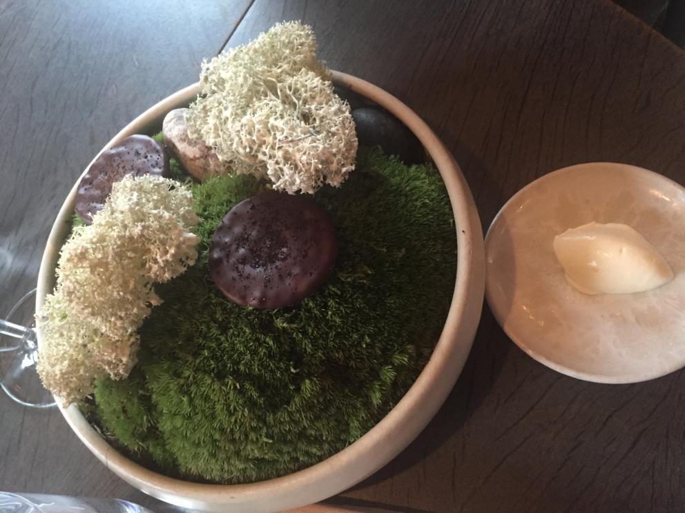 Photogallery






The traditional welcome at Noma: the chefs from the service kitchen greet the guests. In the middle, Italian Riccardo Canella, who will help us describing the last menu in detail (photo gallery by Luca Iaccarino and Gabriele Zanatta)









Warm broth of cloudberries. It’s the last welcome dish at Noma. It’s cold outside but as soon as you sit inside, you get warm thanks to this hot broth made with cloudberries enriched with rhubarb root oil. You dip a bouquet of hay, lemon thyme and mountain pine. Corroborating









Riccardo Canella brings a preview of what will follow









It’s a dish with seafood, including a huge (and alive) king crab, sea urchins and oysters









Apple of the season









Apple of the season. Once you open the shell, many small apple parisienne appear in a juice made with centrifuged, clarified apple scraps, seasoned with verbena and thyme. There’s also a purée of apples fermented in broth. The dish is finished with oxalis flowers, tagete and oil of blackcurrant wood, made by beating the blackcurrant branches with a hammer, so as to extract their essential oils. A very pleasant dish despite its complex idea.

"The first time I saw it ", added Canella, "I was struck because it reminded me of the stuffed apples they used to make at restaurant Bulesca in Selvazzano, Padua, in the early Eighties. Except in that case it was filled with rolls made with granny smith apple and prosciutto from Montagnana" 









Fresh sliced scallop. It’s a scallop taken from the fish tank and shelled a few moments before serving it. It is then sliced, brushed with a reduction of vegetable whipped butter with cucumber centrifuge juice, then reduced, and piso broth (that is to say miso with dehydrated peas).

The technique is the same used for the broth ice-clarification made famous in the Nineties by Heston Blumenthal at Fat Duck: you freeze the broth then hang a table cloth so as to obtain the “pure” part of the liquid. A trick that adds the same satisfying sensation of a meat jus to a vegetable broth. The scallop is finally dipped into a classic mussel broth. An incredible mouthful of seafood and umami









A Winter Platter. Hidden among the leaves, are four edible tastings









He sums up in just one dish 4 snacks that he might would have served separately a few years back. A fun and tasty idea. In detail:

At 6 o’clock: Pear pressed in fermented red gooseberry with fully ripe common sea buckthorn. It’s a rather tart ensemble made sweeter by piso (again miso made with dried peas) seasoned with coriander seeds (supplied by Redzepi’s historic supplier Soren Wiuff). The external thinner leaf is a peel made with chicken broth and beech leaves preserved in vinegar.

10 o'clock: crispy black currant leaf-shaped sandwich, seasoned with yogurt, kombucha, elderberry flowers and red oxalis 

12 o'clock: malt branch with nasturtium leaves, creme fraiche, salt aromatised with pine and ants

4 o'clock: black garlic leaf with salt aromatised with kelp, a Japanese seaweed 









A detail of the malt branch, with well visible ants. At Noma, the study of the aromatic contribution given by formic acid to dishes continues. And even the service acquires elegance: in the past you might have seen ants floating in a few dishes. This is no longer the case









A Tupperware from the "ant library", on the first floor at Strangade









Radish pie. It’s an emblem of the latest menus at Noma. It’s been in the menu for almost a year. In the crunchy disc on the bottom there’s kelp seaweed and a vegetable reduction made with coriander pesto. The radish roses (22, no more, no less) were pressed in beetroot juice. Another formidable tasting









Interns roll the radish roses together, on the top floor at Noma. Loud music and teamwork help making the job less alienating









Natural fermented bread of Øland wheat and hulless barley.  Øland wheat is Danish, with 83% hydration. “Nerd” bread maker Rasmus Kristensen is obsessed with it: even though it could last a week, he bakes it fresh every day for the two services (see the interview on Vice). It has a crispy yet soft crust, and it’s a great progress compared to the early bread making at the restaurant.

The salted butter is instead Norwegian Røros, according to some “the best butter in the world”. One of the most extraordinary pairings ever tasted. We asked for an encore









Cooked oyster and broccoli stems. The oyster is blanched for two minutes and placed on a shell with the edges powdered with salicornia. Between the broccoli and the oyster there are some diced stalks of sorrel. There’s a reduction with kelp seaweed, whisked with butter, thyme and “capers” made with white currants [they’re not real capers but the currants are preserved for a year in 2% salt, like capers). The sauce for the oyster is made with white gooseberries. An artwork, but less convincing than the other tastings









Sea urchin and cabbage. It’s a cabbage leaf pressed with hazelnut oil, filled with sea urchin roe and seasoned with pine vinegar, water from fermented porcini and pickled chanterelle mushrooms. On top, there’s parsley pesto and salt aromatised with pine. It’s a dish that changes greatly according to the season: compared to September, the leaves are now smaller and woodier. Two extraordinary mouthfuls, the result of a rather simple intuition









Sea urchin and cabbage, a detail. Northern sea urchins are creamier than Italian ones. A blast









Langoustine, onion and lavender. The langoustine is the precious one from the Far Oer Islands. The onion is Danish and grilled, steamed in a vacuum bag with Koji oil (blended rapeseed oil with fermented oil) and then grilled again, only slightly, so as to get a golden nuance. The langoustine is instead cooked in its shell, seared in butter at 60°C for 2 minutes, then peeled, cut and served. Rose oil, vinegar made with lovage sprouts and dried lavender complete the picture. The dish is focused on the sweetness given by the onion, which has a similar texture to the langoustine. Very nice









Butternut squash, barley and caviar. The butternut squash is confit in oil aromatised with seaweeds later roasted and placed on top. It is completed with beechnuts, a sauce made with fermented barley and butter and a handful of Finnish caviar. A sweet interlude









Claws and heads of a langoustine from the Far Oer Islands, cut in two. The heads of the langoustine are braised with a paste made with the entrails of the langoustine and a reduction of yeast and thyme and lemon on top. A very pleasing neo-primitive tasting with a strong dose of umami









Steamed king crab and egg yolk sauce. A new take on a classic Japanese dish, learnt in Tokyo and applied in Australia to a snow crab. Global nomadism made Redzepi’s cuisine rounder, less extreme than in the past









In this case, the king crab is steamed and seasoned with smoked salt. The sauce is made with egg yolks marinated in beef garum, a trick that gives a significant sour component to the recipe. Finally, there’s a seasoning made of butter and piso. An interesting depth









Charred greens with a scallop paste. There are plenty of seasonal herbs and vegetables, in this case cabbage, black cabbage, sage, verbena, nettle and the first sprouts of wild garlic. The caramel is made with a purée of fresh scallop, rolled out for 48 hours on a silpat. Once dehydrated, it becomes dark orange. They then blend it, powder it, mix it with bees’ wax and rapeseed oil. Finally they cover the caramel with horseradish juice. Another interlocutory tasting, fun and very much appreciated thanks to the crispiness and the bitter-sweet herbs. Trivia fact: the dish is served with a steak knife. That is to say: herb is the new meat









Roasted Bone Marrow. It’s not the first time they serve grilled bone marrow at Noma, legitimised in fine dining by English Fergus Henderson. What’s new is the way in which they have been serving it in Copenhagen for around one month now: the bone marrow is surrounded by many small plates and garnishes, so guests can enrich it to their liking. A similar idea to what Paolo Lopriore does every day at Portico in Appiano Gentile

 














Among the garnishes that can enrich the bone marrow are pickles, wild mushrooms with beef garum paste, wild herb paste, fresh garlic, leek flower sprouts preserved in salt and salt aromatised with roasted seaweed









Other complements for the bone marrow: to the right, chicken "skin" made with dehydrated jus ("the skin is the best part of a chicken", once Redzepi demonstrated in Belgium) and next to it a vegetal reduction with black garlic









The slices of truffle from Gotland (Sweden) paired with bone marrow are not as strong as those we’re used to. This is why at Noma they add oil aromatised with porcini, aged Danish whiskey and a garum made with Dryad's seddle mushrooms, with a delicate pineapple scent









A dessert of potatoes and plums. Another great emblem of the most recent offer at Noma. Three creams stand out on a sauce of juice and plum aquavit: right to left, a compote of plums (dehydrated in the oven so as to concentrate their aroma), a purée of sweet Danish potatoes and a cream seasoned with plum nuts, which surprisingly recall almonds









Black currant wood ice cream and roasted konini. Also known as "No-Magnum", Noma’s Magnum, unites konini [an ancient Swedish wheat] roasted like coffee, oxalis, a reduction of quince syrup and a few leaves of verbena. Every day the guys sharpen some 200 branches of black currants






