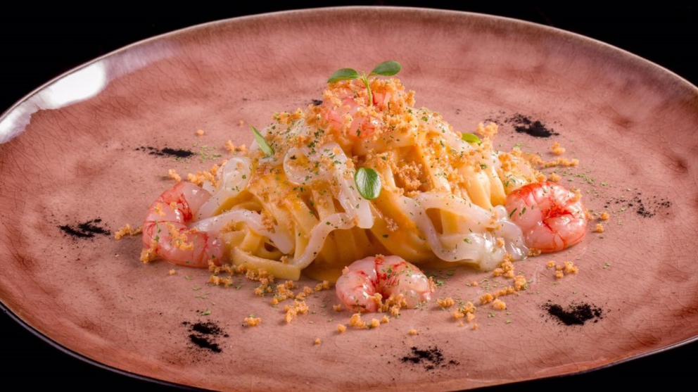 Galleria fotografica






Di grande complessità il Crudo di gambero rosso con stracciatella di burrata al pepe nero e centrifuga di pomodoro datterino al basilico, caviale di storione e polpa di ricci, sferzante, tonico, di mare in tempesta e di terra feconda. Da non perdere per alternanza di tendenze dolci, acidità eterogenee, speziatura e sapidità









La Vitellina a punta di coltello con fonduta di formaggi cremosi e bacche di ginepro dell’Etna affumicata agli aghi di pino investe tre sensi: per la vista è un’immagine evocativa della Muntagna, col rosso della carne al centro a simboleggiare la lava e il bianco della fonduta a rappresentare la neve; per l’olfatto è inebriante il fumo di pino che si diffonde nell’aria quando si solleva la cloche; per il palato è la gioia di un piatto intenso e polposo, bilanciato nella cremosità e nelle acidità silvestri e impreziosito da un delicata affumicatura al ricordo di bosco









Ancora la Vitellina a punta di coltello con fonduta di formaggi cremosi e bacche di ginepro dell’Etna affumicata agli aghi di pino






