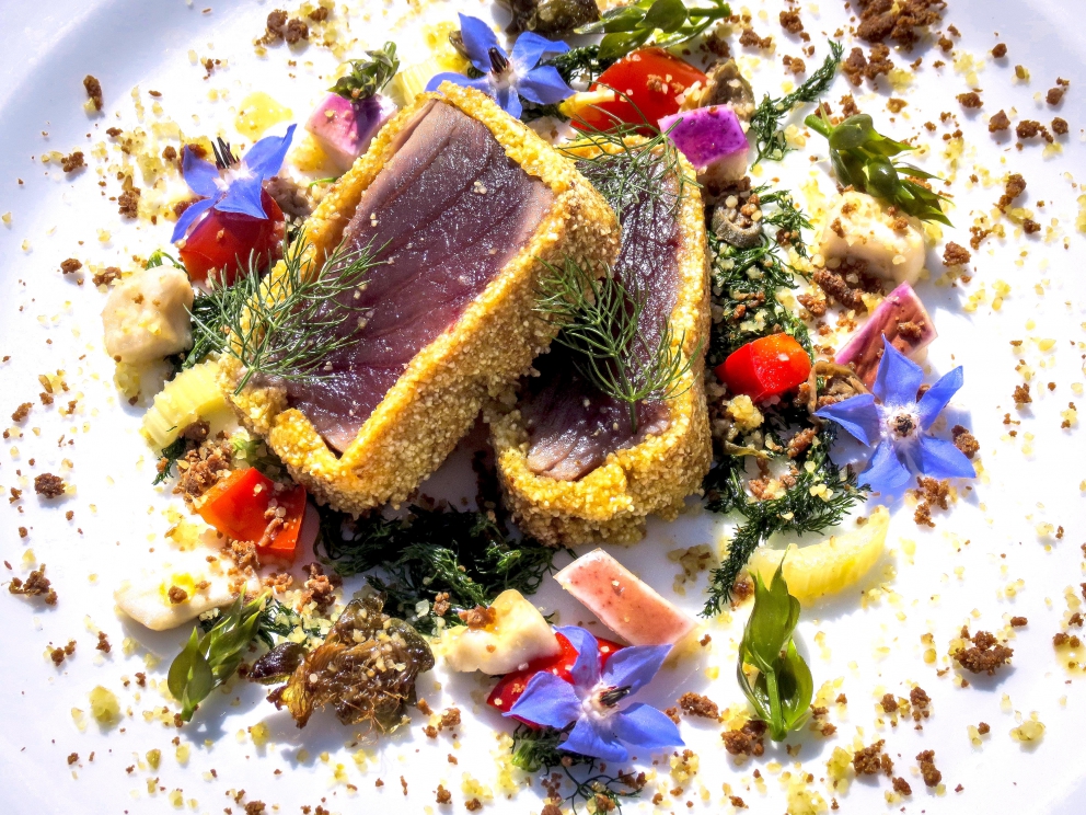 Galleria fotografica






Giuseppe Causarano, Locanda Gulfi, Chiaramonte Gulfi (Ragusa)

Palamita affumicata con foglie di vite, melagrana e azzeruole - Il piatto nasce dalle escursione sul letto del fiume Irminio, territorio sconosciuto e incontaminato che si addentra tra i Monti Iblei e sfocia a Donnalucata, dove poter raccogliere frutti, fiori e erbe selvatiche. Racconta la biodiversità di una terra fantastica come la Sicilia, lavorando uno dei pesci cosiddetti "poveri" come la palamita utilizzando dei prodotti dimenticati come le azzeruole. Il supporto del piatto disegnato da me e realizzato da un artigiano di Modica Giovanni Cerruto ricorda i ciottoli del fiume Irminio









Pino Cuttaia, La Madia, Licata (Agrigento)

Memoria visiva - E' il mio ricordo in una fetta di tonno rosso di Sicilia. Quando ero piccolo mio nonno, che era un ottimo cuoco, marinava con un po' di limone la paillard di vitello, prima di cuocerla. Faccio lo stesso col tonno, ma non lo cuocio anche se l'aspetto è simile, l'impressione della cottura è data proprio dalla marinatura. Se capita lascio che si trovi nel piatto anche il seme del limone: le mamme non si curavano mai se qualche seme cadeva nel piatto. Così presento la ricetta con una volontà evocativa di una quotidianità familiare, che è vita









Peppe Bonsignore, L’Oste e il Sacrestano, Licata (Agrigento)

Evoluzione di un'insalata di mare - Polpo cotto nel tè verde, seppia intagliata, gambero rosso di Licata il tutto servito su una crema di carote e un caramello di soia ottenuto dalla cottura dei cefalopodi. Ricordo che da bambino odiavo il polpo, fin quando mia mamma non decise di farlo con i sottaceti, dove primeggiava la carota, così iniziai ad assaggiarlo. Da quella memoria sono partito; così ho iniziato a lavorare sull'inserimento della carota. Tutto ebbe inizio nel 2009 e ogni anno modifichiamo la ricetta. Studiamo le cotture, aggiungiamo sempre qualche pesce, l’affumicatura del polpo viene fatta con ramoscelli di rosmarino secchi. La buccia di mandorla dona quel profumo di forno a legna che rievoca le nonne. Insomma oggi, nel 2016, dopo 7 anni, non diciamo mai che è una preparazione perfetta, perché è in continua evoluzione









Emanuele Russo, Le Lumìe, Marsala (Trapani)

Filetto di ombrina cotto a bassa temperatura con olio nuovo e miele di timo - Un piatto che unisce il gusto delicato del pesce alla dolcezza del miele e al piccante olio di Nocellara del Belice (la tradizione del pesce con l'innovazione della cottura a bassa temperatura)









Accursio Craparo, Accursio, Modica (Ragusa)

China su te - E' un divertimento che ammalia la vista prima di sorprendere il gusto: rompendo un bottone di seppia che racchiude il suo nero, restiamo ad ammirare la china che fluttua nel brodo di alghe, zenzero e tè nero, come nell'antica arte giapponese del suminagashi









Peppe Barone con Ninni Radicini, Fattoria delle Torri, Modica (Ragusa)

Sovrapposizioni autunnali di fava e fagiolo - Sovrapporre vuol dire in chiave compositiva la necessità, l'aspirazione di ogni essere umano di elevarsi, spingersi verso il cielo, in alto. D'altra parte congiungere due legumi di capitale importanza dà il senso del lavoro del cuoco, che è quello della sintesi di pensiero. Abbinarli alle erbe spontanee era una necessità oggi quasi obbligatoria. Il cuoco unisce sempre e mai separa









Corrado Assenza, Caffè Sicilia, Noto (Siracusa)

Prima che il sole scaldi - Un ragout di seppie e fave di cacao in salsa di broccolo viola, crema di peperoni grigliati. E poi due fili di ottima pasta. Concepito e realizzato col modo di fare di un pasticcere che lavora sul cibo pescando dolcezze e sapidità, costruendo consistenze e incroci con l'utilizzo di quanto la natura ci offre









Salvatore Vicari, Vicari, Noto (Siracusa)

Quaglia, rapa rossa e mela cotogna - Come in un bozzetto campestre ispirato al territorio di Noto, portiamo nel piatto un intero, piccolo ecosistema, che si muove dalle radici al cielo









Massimo Giaquinta, Cortile Arabo, Pachino (Siracusa)

Ostrica Porca - Da un pensiero "piccante" nasce questo piatto, un’ostrica dal mare alla terra, che racchiude l’eleganza della Sicilia. Tre sensazioni differenti ma inscindibili: passione, profumo e dolcezza. La passione trasposta dall'abbraccio tra ostrica e lardo di maialino nero dei Nebrodi, il profumo esaltato da menta peperita, erba citrica e polvere di arancia siciliana, la dolcezza viene sottolineata dalla confettura di gelso nero. Da gustare in un sol boccone - foto Rossana Brancato









Francesco Scarpulla, Brunaccini, Palermo

Ciacuni di patate e farina di tumminia con sparacelli (broccoletti siciliani), cozze, vongole e aria di mare - I ciacuni, gnocchi di patate simili a piccole “ciache” (ciottoli), rivisitazione di un grande classico della tradizione siciliana; la pasta coi frutti di mare con l’introduzione di un elemento terra, lo sparacello, e il tocco finale dellʼaria di mare, che rendono il piatto creativo e innovativo pur mantenendo i sapori tradizionali









Carmelo Trentacosti, Cuvée du Jour del Villa Igiea, Palermo

Triglia farcita con brunoise di verdurine, guazzetto di gamberi bianchi di nassa, crema di lattuga nostrana, bottarga di caviale Calvisius e cracker mediterraneo – E’ una “triglia in guazzetto”, versione moderna della triglia in umido alla messinese che facciamo in Sicilia









Gioacchino Gaglio, Gagini, Palermo

Baccalà profumato al miele di castagne Meli, ceci neri, germogli piccanti e castagne arrosto - Un piatto che racchiude i sapori e gli aromi della Sicilia d'inverno









Alberto Rizzo, Osteria dei Vespri, Palermo

Filetto di cavallo al ginepro, peperoni, patate, cipolla rossa e alici affumicate - Piatto che sintetizza le ispirazioni della mia cucina a cavallo fra le origini emiliane (la “vecchia di cavallo” della tradizione parmigiana) e le suggestioni del patrimonio di materie prime della ragione in cui sono nato (la Sicilia). Toni morbidi e sapidi che dialogano tra di loro in un connubio che realizza l’incontro intrigante fra mare e terra









Ciccio Sultano, Duomo, Ragusa

Pasta, zucca gialla sicula e mandorla pizzuta con ostrica - Una sublimazione del gusto, che racconta un territorio nell'incontro tra terra e mare









Claudio Ruta, La Fenice del Villa Carlotta, Ragusa

Ravioli di carote, scaglie di bottarga di tonno e brodo di pesce affumicato - Due pensieri. L’armonia perfetta nasce dai contrasti ben riusciti; l’equilibrio dei sapori, la materia prima e il rispetto della tradizione. Racconta un percorso di gusto che parte dalla tradizione per poi esaltare in un raffinato mix di verdure e pesce, l'eccellenza delle materie prime. Delicato ed essenziale









Vincenzo Candiano, Locanda Don Serafino, Ragusa

Filetto di mupa in un mare di verdure invernali - La Food Valley ragusana è così chiamata perché ha la fortuna di godere delle bontà che arrivano dal mare che ne bacia le coste, delle delizie ortofrutticole dalle pianure e vallate, dai generosi altopiani per gli ulivi, fino alle verdi e rigogliose alture più a Nord dei Monti iblei, da dove si cava pure qualche ottimo tartufo.In questa pietanza ho portato alcuni dei protagonisti invernali della tavola ragusana: carciofi, topinambur (patacche), cardo selvatico, broccoli e cavolfiori, bietole selvatiche, porro, tartrufo uncinato, il tutto sporcato, come fosse terra umida, dal “terriccio” di pane al nero di seppia bagnato d’olio extravergine. Li ho messi armoniosamente insieme, baciati dal mare rappresentato dall’acqua di cottura del cavolo rosso. A dominare su tutti la succulenta carne della “mupa”, oppure chiamatela occhione: a ogni forchettata la si potrà gustare con una verdura diversa









Andrea Macca, La Cucina di Donnacarmela, Riposto (Catania)

Pacchero sabbiato ripieno di ricotta, maggiorana e funghi porcini con croccante di ragusano dop - Una versione alternativa della pasta al forno, molto amata dai nostri clienti






