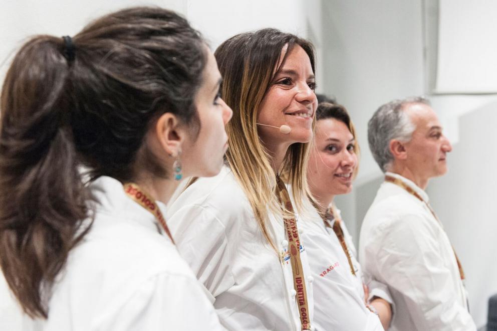 Galleria fotograficaAccompagnata sul palco dalla sorella Emanuela, Daniela Cicioni &ndash; cuoca vegana e crudista capace di trasformare radici e germogli in piatti di alta cucina &ndash; si cimenta con due sfide piuttosto ardue: prima il mondo del dolce, con un insolito tiramis&ugrave; a base di polpa di cocco, alga Irish Moss, latte di mandorle, anacardi, sciroppo d&rsquo;agave, farina di nocciole ed estratto di caff&egrave; con salsa all&rsquo;artemisia. Poi il formaggio vegano, con un erborinato a base di latte di mandorle e anacardi inoculato con il Penicillium roqueforti. Anticipazione della sua linea di formaggi di prossima uscita, accompagna gli spaghetti di konjac infusi nella tisana di fiori di pisello blu con semi di finocchio (tutte le foto sono di Brambilla-Serrani)
Daniela Cicioni con LIsa Casali
Il viaggio di Paolo Lopriore lo ha riportato a casa, alla sua terra tra il lago di Como e la Valtellina, lontano da mode e tendenze; la sua rivoluzione sta soprattutto nel modo di servire il cibo, di immaginare la tavola e la convivialit&agrave;, dando al commensale la libert&agrave; di dosare gli ingredienti, lasciando spazio alla creativit&agrave; gustativa personale oltre che a quella gastronomica del cuoco e a quella artistica di chi realizza piatti e utensili di servizio come l&rsquo;immaginifico affumicatore in legno che sembra uscito dal mondo delle favole. Lui lo usa per aggiungere aromi di legno e chiodi di garofano alle patate con burro salato e bietole che accompagnano gli sciatt con noci, nocino e salsa di noci, frutto del suo lavoro sulle molteplici sfaccettature di un singolo sapore. Come fa pure per la pera proposta in diverse cotture e consistenze.

LEGGI ANCHE:
Lopriore: &laquo;La verit&agrave; &egrave; nel piatto&raquo;, di Paolo Marchi
&Egrave; un viaggio nel mondo dell&rsquo;acido e delle fermentazioni, quello proposto da Mariana M&uuml;ller e dal marito Ernesto, ma anche negli spazi immensi della Patagonia. Cuoca argentina di origini tedesco-ungheresi, al ristorante Cassis&nbsp;propone una cucina insieme indigena e contaminata: ingredienti locali o realizzati da loro stessi &ndash; a cominciare dai tanti tipi di aceto di frutta, fiori, erbe &ndash;, autoctoni o importati nei secoli dai migranti in arrivo da Nord America ed Europa. Cos&igrave; ad esempio la trota, immessa nei laghi di Bariloche dagli Americani, si sposa con l&rsquo;aceto di fiori di dente di leone (autoctoni), grani di senape e nocciole. &laquo;Il segreto del successo -&nbsp;dice la chef - &egrave; avere molti limiti!&raquo;
Del viaggio percepisce soprattutto l&rsquo;elemento del rischio e la paura, ma non per questo Antonia Klugmann, cuoca in una terra di confine e di attraversamenti, si chiude alle contaminazioni, all&rsquo;ascolto, agli scambi. Pronta a cogliere i frutti di nuovi incontri &ndash; come quelli con chi si mette in viaggio e arriva da noi &ndash; presenta un piatto che nasce dalla profonda conoscenza della fermentazione di una sua collaboratrice ucraina, e dalla continua scoperta del territorio circostante. La rapa viene ammorbidita dal burro al tartufo locale, poco pregiato ma dalle potenzialit&agrave; interessanti, e accompagnata dai crauti preparati con aggiunta di mela fermentata secondo l&rsquo;usanza ucraina
Quattro ristoranti tra Milano, Venezia e la Toscana (ed &egrave; annunciata a breve un'altra importante apertura, ndr), altrettante stelle e una cucina raffinata, creativa ma anche sempre pi&ugrave; naturale grazie al menu vegetariano A Green Taste introdotto di recente al Mudec di Milano. Enrico Bartolini&nbsp;con il suo sous Remo Capitaneo presenta l&rsquo;intera sequenza dei piatti, sette portate di cui protagonisti assoluti sono prodotti vegetali, umili ma resi con grande eleganza e gusto. Un assaggio per tutti: il &ldquo;cannolo&rdquo; di cavolo nero con salsa di carpione che nasce dal ricordo della ribollita. &laquo;Da piccolo non mi piaceva, poi mi sono ricordato del rumore diverso che faceva la tostatura delle singole verdure quando la preparava mia zia e ho capito il segreto&raquo;
Il pizzaiolo Antonio Polzella &ndash; all&rsquo;opera a La Ventola a Vada &ndash; sembra aver trovato la pietra filosofale capace di rendere la pizza, oltre che buona e sana, adatta pure a chi ha problemi di diabete o dieta. Nessuna magia ma tanta ricerca, in collaborazione con l&rsquo;educatore alimentare Federico Calzolari. L&rsquo;impasto a base di &ldquo;grano etrusco&rdquo; (Khorasan), farina Petra 9 e altre farine &ldquo;alternative&rdquo; ha un basso indice glicemico, poco glutine, poche calorie. Profumato, croccante e ben lievitato, viene farcito con gli ingredienti della Margherita (estratto di pomodoro e mozzarella light) o &ndash; arricchito dagli scarti della lavorazione del pomodoro &ndash; farcito con una mousse di mozzarella e accompagnato dalla tradizionale pappa al pomodoro toscana
Federico Calzolari, Antonio Polzella, Lisa Casali
