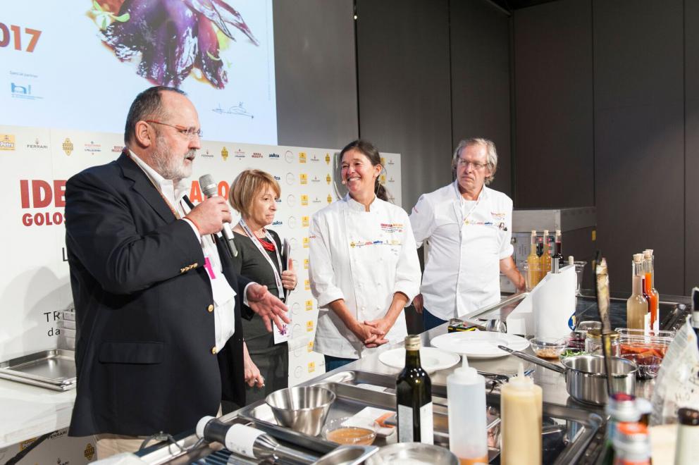 Galleria fotograficaAccompagnata sul palco dalla sorella Emanuela, Daniela Cicioni &ndash; cuoca vegana e crudista capace di trasformare radici e germogli in piatti di alta cucina &ndash; si cimenta con due sfide piuttosto ardue: prima il mondo del dolce, con un insolito tiramis&ugrave; a base di polpa di cocco, alga Irish Moss, latte di mandorle, anacardi, sciroppo d&rsquo;agave, farina di nocciole ed estratto di caff&egrave; con salsa all&rsquo;artemisia. Poi il formaggio vegano, con un erborinato a base di latte di mandorle e anacardi inoculato con il Penicillium roqueforti. Anticipazione della sua linea di formaggi di prossima uscita, accompagna gli spaghetti di konjac infusi nella tisana di fiori di pisello blu con semi di finocchio (tutte le foto sono di Brambilla-Serrani)
Daniela Cicioni con LIsa Casali
Il viaggio di Paolo Lopriore lo ha riportato a casa, alla sua terra tra il lago di Como e la Valtellina, lontano da mode e tendenze; la sua rivoluzione sta soprattutto nel modo di servire il cibo, di immaginare la tavola e la convivialit&agrave;, dando al commensale la libert&agrave; di dosare gli ingredienti, lasciando spazio alla creativit&agrave; gustativa personale oltre che a quella gastronomica del cuoco e a quella artistica di chi realizza piatti e utensili di servizio come l&rsquo;immaginifico affumicatore in legno che sembra uscito dal mondo delle favole. Lui lo usa per aggiungere aromi di legno e chiodi di garofano alle patate con burro salato e bietole che accompagnano gli sciatt con noci, nocino e salsa di noci, frutto del suo lavoro sulle molteplici sfaccettature di un singolo sapore. Come fa pure per la pera proposta in diverse cotture e consistenze.

LEGGI ANCHE:
Lopriore: &laquo;La verit&agrave; &egrave; nel piatto&raquo;, di Paolo Marchi
