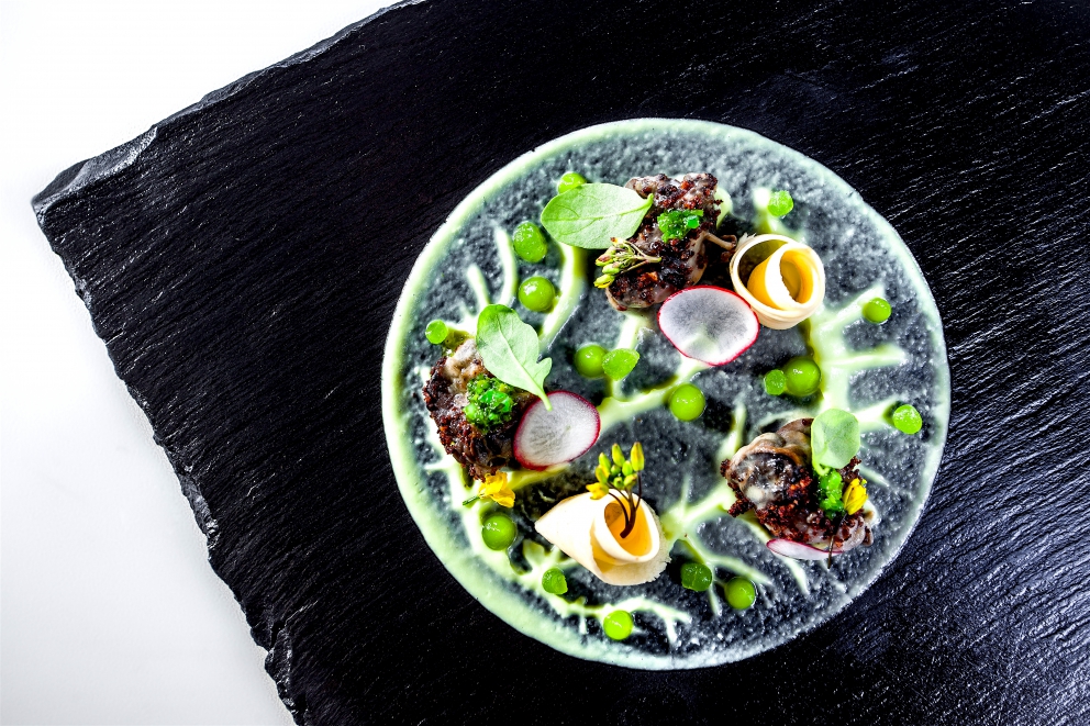 Galleria fotografica






Giorgio Damini, Damini & Affini, Arzignano (Vicenza)

La mia caesar salad - L'idea è sicuramente nata dopo le mie esperienze londinesi, quando ho scoperto come una salsa cambi completamante il gusto dell'insalata. Quindi ho cercato di esaltare tutti gli ingredienti dividendoli uno per uno, senza mescolare nulla, poi un pizzico di macelleria con la carne disidratata al posto del pollo e, dulcis in fundo, il pane di Eugenio Pol









Alessandro Dal Degan, La Tana, Asiago (Vicenza)

Crudo di anatra fiammeggiata, topinambur, foglie di faggio e sorbo dell'uccellatore - E' un piatto che per tonalita amaro-salate e per quelle dei colori è un simbolo della stagione fredda e della monocromia invernale. Un omaggio alla lentezza









Alessio Longhini, Stube Gourmet dell'hotel Europa, Asiago (Vicenza)

Riso carnaroli mantecato alla crema di topinambur, crudo di ricciola, caramello di birra stout, uova di salmone - Piatto che rispecchia le mie esperienze. Raccoglie gusti e consistenze diversi tra loro









Alfio Ghezzi, Locanda Margon, Trento

Non aglio e olio, non cacio e pepe, ma insolito Trentino - Spaghetti Monograno Felicetti, TrentoDoc Ferrari Perlé, Trentingrana e olio extravergine Garda Trentino Dop Uliva... Un piatto che nasce sulla suggestione di Bottura: «...ma siamo proprio sicuri che la tradizione sia rispettosa del territorio?». E che si sviluppa attraverso la tecnica dei due classici, aglio e olio e cacio e pepe, declinati però in chiave trentina









Giuliano Baldessari, Aqua Crua, Barbarano Vicentino (Vicenza)

Mungotto alle capesante, artemisia e argilla - Lo propongo perché offre un punto di vista diverso sul mondo del risotto. Il mungotto è il nome che ho dato al "risotto" fatto con i fagioli mung al posto del riso









Lionello Cera, Antica Osteria Cera, Campagna Lupia (Venezia)

Spaghettino freddo con cavolfiore, champagne rosé, scampo e ostrica - Un piatto che nasce dopo avere cotto il cavolfiore assieme ai gusci delle canocchie. Ho pensato di conferirgli acidità e ho fatto ridurre dello champagne con anice stellato. Poi scampo crudo battuto e un pezzo di ostrica per ricordare il mare in purezza









Nicola Dinato, Feva, Castelfranco Veneto (Treviso)

Risotto al broccolo di Bassano, cannocchie, mandarino, alici - "...with tangerine trees and broccoli skies..". Citiamo, modificandola, una frase del brano Lucy in the Skies with Diamonds, dei Beatles. Proponiamo l'italianità in un primo piatto invernale, che coglie spunti dal territorio limitrofo (il broccolo di Bassano del Grappa, le cannocchie della Laguna di Venezia), ma anche da altrove (i mandarini siciliani, la colatura di alici di Cetara). Il tutto unito da un grande riso, il Principato di Lucedio









Giuseppe D’Aquino, Oseleta, Cavaion Veronese (Verona)

Spaghetti al pomodoro del piennolo, burrata e scorza di limone – Un piatto che nella sua semplicità è diventato il must del ristorante Oseleta. Un piatto per il quale a detta di tanti vale la pena fare il viaggio









Riccardo Gaspari, El Brite de Larieto, Cortina d'Ampezzo (Belluno)

Spaghetto di montagna - Il profumo del bosco sfida la tradizione italiana in un semplice spaghetto aglio e olio









Donato Episcopo, La Corte dell'hotel Villa Abbazia, Follina (Treviso)

Mandorla di Toritto, composta di fichi “paradiso”, spugna all’alloro e gelato moka - Questo dessert nasce da un capriccio di mia mamma che, durante un mio viaggio, decise di mettermi di nascosto, in valigia, un vasetto di fichi secchi. Non so come fece a passare i controlli in aeroporto e comunque quando lo trovai fu una bella sorpresa. Mi ricordo che da ragazzo, quando andavo a casa delle zie o dei nonni, con il caffè offrivano dei fichi secchi con al centro una mandorla e un pezzettino di foglia di alloro (usanza della mia terra, che è il Salento)









Alberto Basso, 3Quarti, Grancona (Vicenza)

Risi e latte, miele, sfere di birra al lampone e ribes - Riso e latte è la tradizione, il cibo povero per eccellenza nelle nostre zone. Siamo partiti quindi da questo e dalla semplicità per sviluppare un dolce inusuale e per certi versi anche un po' estremo. Il riso viene cotto nel latte e mantecato col gorgonzola, per dare un po’ di sapidità, e miele del bosco di Rigoni di Asiago. Lo serviamo con lamponi disidratati, ribes e sfere di birra al lampone









Nicola Portinari, La Peca, Lonigo (Vicenza)

Anguilla in forno di braci con guava e tamarindo - L'anguilla è difficile da affrontare per la clientela a causa della sua grassezza. Quindi la sfida è creare un piatto da consigliare per poi ricevere complimenti e la conseguente voglia di mangiarlo di nuovo. Risulta croccante fuori e morbido dentro, con la guava che con la sua fresca tannicità doma la parte grassa dell'anguilla, mentre il tamarindo addolcisce e rende raffinato e vellutato il suo sapore rustico e leggermente terroso









Leandro Luppi, Vecchia Malcesine, Malcesine (Verona)

Raviolo aperto di spaghetti, lago e zafferano - Un chiaro omaggio al Marchesi del Raviolo aperto e allo Scabin dello spaghetto cotto in sottovuoto. In più, il mio lago









Lorenzo Cogo, El Coq, Marano Vicentino (Vicenza)

Ritorno alla sapidità - Alice sotto sale, rapa, dragoncello, kiwi fermentato, petali di carciofo e umibudo









Piergiorgio Siviero, Lazzaro 1915, Pontelongo (Padova)

Scam-pato verso i colli – Uno scampo di Chioggia tostato in saor, noce salata e tarassaco, chips di topinambur. Risalendo dalle valli di Chioggia lungo il Bacchiglione, il percorso tra storia e identità del mio territorio









Massimiliano Alajmo, Le Calandre, Rubano (Padova)

Mozzarella di mandorle - Una finta mozzarella di pasta cotta di zucchero, miele e albume soffiato come uno zucchero filato, senza l’utilizzo di coloranti o altri elementi artificiali. La ricostruzione olfattiva del piatto rimanda a una vera mozzarella per la presenza dell’acqua, dell’olio extra vergine di oliva, dell’origano e dei canditi vegetali. Ironia e immaginazione per travestire la mandorla e proiettarla in un’altra dimensione, per far riscoprire in pochi istanti una sensazione lattico-tattile-olfattiva e visiva in un dolce che non contiene nemmeno una goccia di latte – foto Bob Noto









Pierchristian Zanotto, Gambrinus, San Polo di Piave (Treviso)

Gamblù – E’ il nostro "blu" vegetale affinato in bacche di uva rabosa bio, sedano rapa e pane al pepe rosa. Seguendo il nostro percorso di cucina etica e responsabile, senza rinunciare alla golosità dei grandi formaggi









Oliver Piras e Alessandra del Favero, Aga dell'hotel Villa Trieste, San Vito di Cadore (Belluno)

Linguine, mirtilli, luppolo e salsiccia di manzo cruda - Abbiamo ricreato con due varietà di mirtilli diverse lo stesso ph del pomodoro e il condimento ricorda il classico sugo alla campidanese delle mie zone d'origine









Fabrizia Meroi, Laite, Sappada (Belluno)

Piatto del Piave - Salmerino leggermente marinato, yogurt alla camomilla di fiume, salsa di patate dolci e olio al crescione, meringhe all'alga spirulina e caramella effervescente.
Il piatto è dedicato al fiume che nasce a Sappada. Nel 2015 ricorreva inoltre il centenario della Prima Guerra Mondiale, evento storico che ha visto protagonista proprio il Piave









Corrado Fasolato, Spinachile Resort, Schio (Vicenza)

Filetto di Triglia con iceberg di ortaggi invernali e moka ai germogli di bosco - È una triglia cotta a bassa temperatura e poi messa su degli iceberg di ortaggi (frullati di verdure sifonati a -40°) e un brodo denso di gallina. Il tutto va irrorato con un’estratto di germogli di piante di bosco profumato con riccioli freschi di legno di castagno. Il calore scioglie gli iceberg e il tutto si trasforma quasi in un passato di verdure









Andrea Stella, Dalla Libera, Sernaglia della Battaglia (Treviso)

Gnocchi di patate soffiati con acciuga di Cetara e puntarelle - Già mia zia Libera circa cinquant'anni preparava ottimi gnocchi; così io ho deciso di riproporli in forma e consistenze nuove. Vengono soffiati in forno, mentre la base viene realizzata con l'acciuga di Cetara che per sua caratteristica è meno salata delle altre. La croccantezza viene data dalle puntarelle









Michele Cella, Basilico Tredici, Treviso

Riso, carbone, baccalà e “saor” - Sono particolarmente legato a questo piatto in quanto è stato premiato come miglior ricetta alla sesta edizione del Festival Triveneto del Baccalà - Trofeo Tagliapietra, vincendo così la manifestazione gastronomica itinerante che quest'anno ha raccolto 28 ristoranti tra Veneto, Friuli Venezia Giulia e Trentino Alto Adige e che rappresenta l’evento simbolo ed esemplare della passione per il baccalà in cui gli chef e le loro brigate si sfidano per ideare “la migliore ricetta innovativa”. Sono particolarmente legato a questo piatto anche perché rappresenta in pieno il mio concetto di cucina, in quanto ci sono prodotti che amo del mio territorio. Rispecchia la mia chiave di lettura della tradizione – foto Tobia Berti









Francesco Brutto, Undicesimo Vineria, Treviso

Riso acido - Si tratta semplicemente di un riso cotto nel succo di melograno fermentato e poi condito con tre polveri: di frutti di bosco, di karkadè e di buccia di chulo key lime bruciato. La cosa interessante per me sono le diverse acidità che lo compongono, nettamente differenti, e tutte riconoscibili: dall'acido-dolce del melograno, all'acido-amaro della polvere di limone. Gli ingredienti sono tutti autoprodotti: il limone è una piantina che mi è stata regalata da un amico di ritorno dalla Florida e che ora sta nel giardino del ristorante; i frutti di bosco sono stati raccolti quest'estate a casa mia, dove mia mamma ha coltivato anche un paio di piante di karkadè; i melograni vengono dal giardino di un nostro cameriere









Alessandro Intini, Nidaba, Montebelluna (Treviso)

Verdure alla griglia, purea di zucca e miso, gel al sakè, cavolo nero, spinacio fritto - Non c'è niente di più semplice del nutrirsi della terra, non c’è niente di più difficile del nutrirsi di essa









Andrea Asoli, Serena Baiano, Michelangelo Doria, Sabina Joksimovic, Venissa, Venezia

Pazzi "a' …mare" - Ruotepazze Benedetto Cavalieri, frutti di mare, acqua di datterini e sabbia di corallo. I frutti di mare cambiano texture, diventano gel e vanno a riempire le ruote che sono mantecate con l’acqua dei molluschi. Un’esplosione di mare in un boccone









Giancarlo Perbellini, Casa Perbellini, Verona

Quaglia affumicata, pomodori confit, carciofi, pistacchi e crema di Grana Padano - Presente nella prima carta del 2016, grande successo del 2015, è il piatto del nuovo corso di Casa Perbellini che ha riscosso lodi da tutta la clientela e che manterremo finché sarà stagione di carciofi









Italo Bassi, Confusion Lounge, Verona

Salmone in guacamole avvolto in carta di riso, con gelatina di ponzu, mandorle tostate, ikurae e leche di tigre al mango - Interpretazione oltre confine di una semplice tartare di salmone. Oriente e Centro America si uniscono in un unico piatto









Matteo Rizzo, Il Desco, Verona

Merluzzo nero e le sue trippe alla parmigiana - Lo propongo per il legame che ha con la storia della mia famiglia. E' espressione delle mie esperienze e idee









Simone Lugoboni, Oste Scuro, Verona

Astice bretone al vapore su crema e chips di topinambur con profumo d'arancio - Piatto stagionale (topinambur e arancio) che rivaluta l'astice bretone o blu (un'altra marcia a confronto col canadese) e che mi ricorda il mio periodo lavorativo trascorso da giovane in Francia






