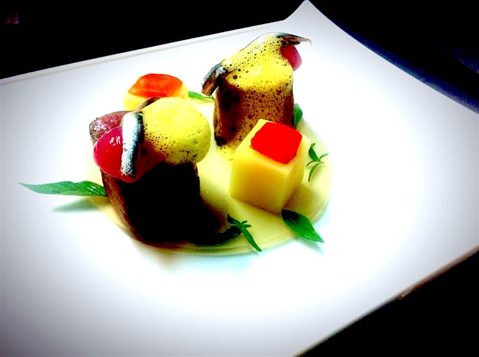 Galleria fotografica






Giuseppe Causarano, Locanda Gulfi, Chiaramonte Gulfi (Ragusa)

Palamita affumicata con foglie di vite, melagrana e azzeruole - Il piatto nasce dalle escursione sul letto del fiume Irminio, territorio sconosciuto e incontaminato che si addentra tra i Monti Iblei e sfocia a Donnalucata, dove poter raccogliere frutti, fiori e erbe selvatiche. Racconta la biodiversità di una terra fantastica come la Sicilia, lavorando uno dei pesci cosiddetti "poveri" come la palamita utilizzando dei prodotti dimenticati come le azzeruole. Il supporto del piatto disegnato da me e realizzato da un artigiano di Modica Giovanni Cerruto ricorda i ciottoli del fiume Irminio









Pino Cuttaia, La Madia, Licata (Agrigento)

Memoria visiva - E' il mio ricordo in una fetta di tonno rosso di Sicilia. Quando ero piccolo mio nonno, che era un ottimo cuoco, marinava con un po' di limone la paillard di vitello, prima di cuocerla. Faccio lo stesso col tonno, ma non lo cuocio anche se l'aspetto è simile, l'impressione della cottura è data proprio dalla marinatura. Se capita lascio che si trovi nel piatto anche il seme del limone: le mamme non si curavano mai se qualche seme cadeva nel piatto. Così presento la ricetta con una volontà evocativa di una quotidianità familiare, che è vita









Peppe Bonsignore, L’Oste e il Sacrestano, Licata (Agrigento)

Evoluzione di un'insalata di mare - Polpo cotto nel tè verde, seppia intagliata, gambero rosso di Licata il tutto servito su una crema di carote e un caramello di soia ottenuto dalla cottura dei cefalopodi. Ricordo che da bambino odiavo il polpo, fin quando mia mamma non decise di farlo con i sottaceti, dove primeggiava la carota, così iniziai ad assaggiarlo. Da quella memoria sono partito; così ho iniziato a lavorare sull'inserimento della carota. Tutto ebbe inizio nel 2009 e ogni anno modifichiamo la ricetta. Studiamo le cotture, aggiungiamo sempre qualche pesce, l’affumicatura del polpo viene fatta con ramoscelli di rosmarino secchi. La buccia di mandorla dona quel profumo di forno a legna che rievoca le nonne. Insomma oggi, nel 2016, dopo 7 anni, non diciamo mai che è una preparazione perfetta, perché è in continua evoluzione









Emanuele Russo, Le Lumìe, Marsala (Trapani)

Filetto di ombrina cotto a bassa temperatura con olio nuovo e miele di timo - Un piatto che unisce il gusto delicato del pesce alla dolcezza del miele e al piccante olio di Nocellara del Belice (la tradizione del pesce con l'innovazione della cottura a bassa temperatura)









Accursio Craparo, Accursio, Modica (Ragusa)

China su te - E' un divertimento che ammalia la vista prima di sorprendere il gusto: rompendo un bottone di seppia che racchiude il suo nero, restiamo ad ammirare la china che fluttua nel brodo di alghe, zenzero e tè nero, come nell'antica arte giapponese del suminagashi









Peppe Barone con Ninni Radicini, Fattoria delle Torri, Modica (Ragusa)

Sovrapposizioni autunnali di fava e fagiolo - Sovrapporre vuol dire in chiave compositiva la necessità, l'aspirazione di ogni essere umano di elevarsi, spingersi verso il cielo, in alto. D'altra parte congiungere due legumi di capitale importanza dà il senso del lavoro del cuoco, che è quello della sintesi di pensiero. Abbinarli alle erbe spontanee era una necessità oggi quasi obbligatoria. Il cuoco unisce sempre e mai separa









Corrado Assenza, Caffè Sicilia, Noto (Siracusa)

Prima che il sole scaldi - Un ragout di seppie e fave di cacao in salsa di broccolo viola, crema di peperoni grigliati. E poi due fili di ottima pasta. Concepito e realizzato col modo di fare di un pasticcere che lavora sul cibo pescando dolcezze e sapidità, costruendo consistenze e incroci con l'utilizzo di quanto la natura ci offre









Salvatore Vicari, Vicari, Noto (Siracusa)

Quaglia, rapa rossa e mela cotogna - Come in un bozzetto campestre ispirato al territorio di Noto, portiamo nel piatto un intero, piccolo ecosistema, che si muove dalle radici al cielo









Massimo Giaquinta, Cortile Arabo, Pachino (Siracusa)

Ostrica Porca - Da un pensiero "piccante" nasce questo piatto, un’ostrica dal mare alla terra, che racchiude l’eleganza della Sicilia. Tre sensazioni differenti ma inscindibili: passione, profumo e dolcezza. La passione trasposta dall'abbraccio tra ostrica e lardo di maialino nero dei Nebrodi, il profumo esaltato da menta peperita, erba citrica e polvere di arancia siciliana, la dolcezza viene sottolineata dalla confettura di gelso nero. Da gustare in un sol boccone - foto Rossana Brancato









Francesco Scarpulla, Brunaccini, Palermo

Ciacuni di patate e farina di tumminia con sparacelli (broccoletti siciliani), cozze, vongole e aria di mare - I ciacuni, gnocchi di patate simili a piccole “ciache” (ciottoli), rivisitazione di un grande classico della tradizione siciliana; la pasta coi frutti di mare con l’introduzione di un elemento terra, lo sparacello, e il tocco finale dellʼaria di mare, che rendono il piatto creativo e innovativo pur mantenendo i sapori tradizionali









Carmelo Trentacosti, Cuvée du Jour del Villa Igiea, Palermo

Triglia farcita con brunoise di verdurine, guazzetto di gamberi bianchi di nassa, crema di lattuga nostrana, bottarga di caviale Calvisius e cracker mediterraneo – E’ una “triglia in guazzetto”, versione moderna della triglia in umido alla messinese che facciamo in Sicilia









Gioacchino Gaglio, Gagini, Palermo

Baccalà profumato al miele di castagne Meli, ceci neri, germogli piccanti e castagne arrosto - Un piatto che racchiude i sapori e gli aromi della Sicilia d'inverno






