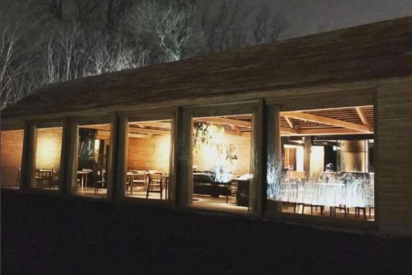 Photogallery






Noma 2.0 is in Christianshavn, the same neighbourhood as the first Noma. They’re 1.5 km apart, a 15 minutes’ walk. This picture shows the distance: to the right, there’s the warehouse of the old location (in Strandgade 93), to the left the smokestacks of Amager Bakke, the futuristic incinerator below which stands the new Noma (in Refshalevej 96)









Weather permitting, you can have a peaceful walk between the previous Noma to today’s Noma 









The new Noma is on an isthmus surrounded by canals. In the future they also want to reclaim some small parts for hydroponic farming









Bucolic scene with incinerator









Bikes left outside Noma. It’s the favourite means of transport among employees and interns









The long path taking you to the restaurant. The fence on the left shows how works are still in progress









On the two sides of the path there are the two new sections of the "Noma village", each with its specialty: grill, hot dishes, snacks, fermentations... In one month’s time, behind the fence we’ll have greenhouses, the test kitchen and the bread making area









To the left, before arriving at the restaurant, the future test kitchen. This will be run by Danish Mette Søberg with Riccardo Canella. "My first challenge?", reveals the latter, for a long time sous chef here, "is to work on the extraction of essential oils" 









The future Test Kitchen









The temporary gangway to the restaurant









Looking from the door to the restaurant, there’s a lake and the smokestacks puffing vapour from the Amager Bakke incinerator. It’s a futuristic project, both in terms of sustainability and architecture. It’s also known as Amager Slope or Copenhill, and its author is starchitect Bjarke Ingels, the same who designed the new Noma. Gradually opened in 2017, it transforms waste into electricity. The goal is to donate electricity to 62500 houses and hot water to 160000. It’s part of an ambitious project to transform Copenhagen into the first city in the world in terms of zero carbon dioxide emissions by 2025. By autumn this year, Amager Slope should open its ski slope, a climbing wall and a hiking track. You’ll be able to slalom on top of the incinerator









The windows from the dining room









Work is still in progress (photo taken on Thursday 22nd February 2018)









Traces of the old building, with barbwire. During WWII, they built bombs here






