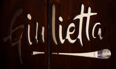 L'insegna della pizzeria romana Giulietta così come la si trova sulla porta che conduce alla cucina, da cui escono i molti fritti presenti in carta: scagliozze, mozzarella in carrozza, panzerotti, frittata di pasta, zeppole e tanto altro
