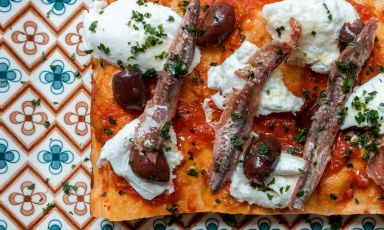 Trancio di pizza con fiordilatte, olive nere e alici di Cetara: è una delle tante proposte golose di Forbici Pizza a Padova
