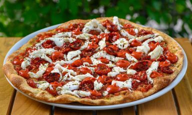 Ma Che…Rita! 3.0 (con fiordilatte in treccia sfilacciato a mano, pomodorini ciliegini confit, salsa di datteri, origano di Pantelleria): una delle proposte di Sandro Cubeddu alla pizzeria Re|Mi di Sassari. L'impasto in questo caso è croccante e sottile con farina 100% macinata a pietra da grani italiani, crusca, grano germinato e spezzato
