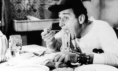 Un celebre scatto che ritrae Alberto Sordi in una scena di Un americano a Roma, film diretto da Steno e uscito nelle sale proprio in quello stesso 1954 in cui Elizabeth David dava alle stampe il suo Italian food
