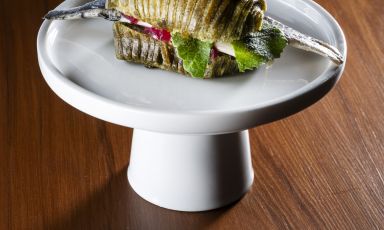 Panino sfogliato alle alghe, con alici, senape e kimchi di okra, tra gli snack di benvenuto del menu Spine del ristorante due stelle Michelin a Senigallia, Ancona, La Madonnina del Pescatore. Foto a cura di Brambilla/Serrani
