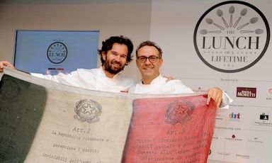 Carlo Cracco and Massimo Bottura fold out the Italian flag at the super-lunch held at Harrods in London on 28th April 2013 when seven Italian chefs gave life to what the English called The Lunch of a Lifetime 
