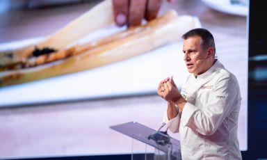 Oriol Castro on stage at Identità Milano 2024. In the background, the presentation of the Calçotada 
