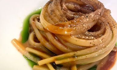 Come recuperare il pane e il formaggio che avanzano al ristorante?
Ragionando su un possibile utilizzo che prolunghi la vita degli ingredienti. Le bucce dei formaggi (disponibili al carrello) e il pane in esubero diventano - il primo - un garum di latte, intenso, che raccoglie tutti gli umori di queste delizie dalla sapidità burrosa, e - il secondo - un aceto di pane, aggiunto sul finale di questo primo piatto, servito come chiusura della parte salata. Poi, polvere di cappero per virare su una sapidità più vegetale e polvere di noccioli di oliva, con pepe Sichuan che accende di freschezza il piatto. Accade al DEG, ristorante a Busto Arsizio (Varese) dello chef e patron Stefano De Gregorio
