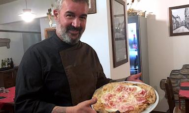 Massimo Bosco e una delle sue pizze, in particolare quella con fior di latte, peretta di Berchidda (formaggio a pasta filata locale), pancetta arrotolata e scaglie di GranAnglona
