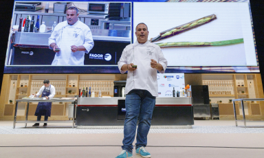 Ángel León nei giorni scorsi sul palco di Gastronomika 2021 a San Sebastiàn, in Spagna. Alle sue spalle, sulla destra, una foto della Zostera marina, una posidonia che presenta chicchi simili al riso. Lo chef andaluso ne sta sperimentando la coltivazione, che promette tantissimo...
